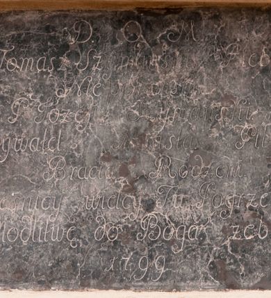 Zdjęcie nr 1: Płyta w formie leżącego prostokąta. W polu inskrypcja „D(eo) O(ptimo) M(aximo) / X(iądz) Tomasz Szymański Pleban / Niepołomki / y P(an) Józef Szymański. / Obywatel Miasta Pilzna / Bracia Rodzeni. / Grześnicy wielcy Tu Pogrzebani. / O Modlitwę do Boga żebrzą. / 1799”.