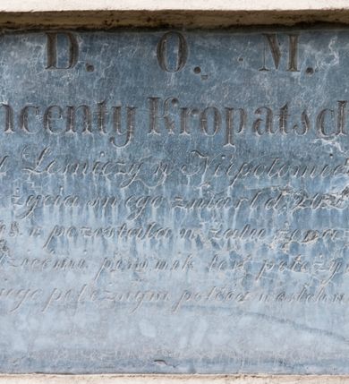 Zdjęcie nr 1: Płyta w formie leżącego prostokąta. W polu inskrypcja „D(eo) O(ptimo) M(aximo) / Wincenty Kropatschek / Caal Leśniczy w Niepołomicach / w 65. r(oku) życia swego zmarł d(nia) 20 Listopa/da 1848. r(oku) pozostała w żalu żona wraz / z dziećmi pomnik ten położyła, / duszę jego pobożnym poleca westchnieniom.”