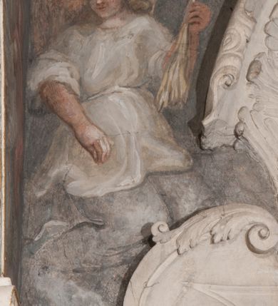 Zdjęcie nr 31: Iluzjonistyczną dekoracją malarską pokryto ściany kaplicy oraz strefę ponadcokołową: ściany tarczowe, pendentywy wokół stiukowych kartuszy herbowych oraz czaszę kopuły i wnętrze latarni. Ściany dolnej części podzielono na dwie strefy. Dolną tworzą zlokalizowane w narożach ścian iluzjonistycznie malowane pary nisz o konchach wypełnionych muszlą. W niszach ukazano osiem stojących frontalnie postaci starców, bez atrybutów i nimbów. Zapewne w ten sposób przedstawiono proroków lub apostołów. Każda z postaci ubrana jest w tunikę oraz płaszcz. Różnicuje je jedynie układ rąk, sposób kształtowania zarostu oraz kolorystyka szat. W drugiej strefie w przyłuczach arkad ukazano całopostaciowe przedstawienia uskrzydlonych aniołów trzymających narzędzia męki Pańskiej. Na ścianie wschodniej anioł prezentuje chustę Weroniki (z prawej) oraz latarnię (z lewej). Po bokach wejścia do kaplicy na ścianie północnej po prawej stronie anioł trzyma lancę i koronę cierniową, a po lewej krzyż. Z kolei na ścianie wschodniej po prawej ukazano anioła z drabiną, a po lewej z gąbką na trzcinie. Natomiast na ścianie południowej, po obu stronach zwieńczenia nagrobka, przedstawiono z prawej anioła z włócznią, a po lewej anioła z wiązką do biczowania. W tej strefie bezpośrednio przy łukach arkad wyobrażono leżące postacie geniuszy malowanych w technice en grisaille. Pod arkadą na ścianie wschodniej (ołtarzowej), ukazano dolną część owalnego jasno ugrowego baldachimu z lambrekinem i zielone, opadające paludamentum, rozsuwane kotarowo przez dwa uskrzydlone anioły. Dekoracja stanowi oprawę dla wiszącego tu obrazu Matki Boskiej z Dzieciątkiem w bogato rzeźbionej ramie. Z kolei na ścianie zachodniej wyobrażono monumentalną scenę Zdjęcia z krzyża. Jest to zwarta kompozycja ogniskująca się na wysokim drewnianym krzyżu, z którego ściągane jest martwe ciało Chrystusa. Z dwóch stron dłuższych ramion krzyż podtrzymują dwaj aniołowie. Ciało Jezusa opuszczane jest na białym pasie tkaniny przewiązanym pod jego ramionami. Chrystus ze zwisającą głową ma ręce ułożone wzdłuż ciała. Biodra przepasane ma białym perizonium. Jego skrzyżowane nogi są ugięte i jeszcze przybite gwoździem do krzyża. Gwóźdź wyciąga z nich obcęgami mężczyzna w niebieskiej, podwiniętej koszuli. Ciało opuszczają dwaj mężczyźni widoczni za poprzecznymi ramionami krzyża, trzymający końce taśmy. Człowiek z lewej strony w niebieskiej koszuli dodatkowo odbiera drugą białą taśmę od mężczyzny ubranego w szaroczarny strój. Osoba ta stoi na drabinie opartej o poprzeczne ramię krzyża. Drugi mężczyzna za krzyżem, w brązowej koszuli, lewą ręką trzyma koniec taśmy, a w uniesionej prawej młotek. Ciało Zbawiciela podtrzymuje lewą ręką kolejny mężczyzna stojący tyłem do widza na drugiej drabinie opartej o lewe ramię krzyża. Jest on ubrany w krótkie brązowe spodenki i bladozieloną koszulę. Pod krzyżem stoi zwarta siedmioosobowa grupa. Najprawdopodobniej z prawej strony ukazano św. Jana i Matkę Boską, na środku dwóch żołnierzy w ostro zakończonych hełmach, dwie kobiety, w tym zapewne Marię Magdalenę i starca widocznego z lewej strony kompozycji. Na ścianach tarczowych nad gzymsem wyobrażono po bokach okrągłych okien siedzących czterech ewangelistów i czterech ojców Kościoła. Na ścianie wschodniej znalazł się z prawej św. Jan z orłem, który w dziobie trzyma złoty kałamarz, a po lewej św. Mateusz rozmawiający z aniołem. Z kolei na ścianie południowej po lewej stronie przedstawiono św. Marka z lwem oraz św. Ambrożego trzymającego w prawej ręce naczynie z wylewającym się miodem. Na ścianie zachodniej z lewej znalazł się czytający św. Augustyn z sercem na dłoni, a z prawej św. Grzegorz Wielki z widoczną za nim tiarą i sową. Na ścianie północnej po lewej ukazano św. Hieronima z leżącym lwem, a po prawej stronie św. Łukasz z wołem. W pendentywach wykonano malarską dekorację w formie wijącej się wstęgi, na tle której widnieją stiukowe kartusze rollwerkowe, o owalnych kaboszonowych polach czwórdzielnych w krzyż. Po stronie wschodniej w pendentywach znajdują się dwa puste kartusze z niezachowanymi herbami. Natomiast herby zachowały się w pendentywach po stronie zachodniej. Na pendentywie północno-zachodnim: Jastrzębiec, Nowina, Gozdawa, Pobóg, a na południowo-zachodnim Gryf, Kotwicz, Kotwicz, Zabawa. W kopule wyobrażono Koronację Matki Boskiej adorowanej przez różnych świętych. Scenę koronacji Marii przez Trójcę Świętą przedstawiono w części wschodniej czaszy. Ukazana frontalnie Maria klęczy ze złożonymi rękami do modlitwy na obłokach. Ma owalną twarz okoloną jasnymi długimi włosami rozsypującymi się na jej ramiona. Na uniesionej ku górze głowie ma ubraną zsuwającą się białą chustę okrywającą włosy. Madonna ubrana jest w zasłaniający jej ramiona bladoniebieski płaszcz, opadający po bokach na obłoki. Nieznacznie wyżej z prawej strony na obłokach siedzi Bóg Ojciec. Wyobrażono go w trzech czwartych w prawo. Jest to starszy mężczyzna o siwych włosach i brodzie. W wyciągniętej prawej ręce nad głową Marii wraz z Chrystusem trzyma złotą koronę w typie zamkniętym. Z kolei w lewej podtrzymuje glob ze złotym krzyżykiem. Bóg Ojciec na głowie ma tiarę papieską. Ubrany jest w szaro-niebieską szatę oraz wzorzystą złotą kapę narzuconą na ramiona i spiętą pod szyją klamrą, z połami okrywającymi nogi. Naprzeciwko siedzi Chrystus widoczny w trzech czwartych w lewo z twarzą ukazaną w profilu. W wyciągniętej prawej ręce trzyma wraz z Bogiem Ojcem koronę, a lewą podtrzymuje złote berło. Chrystus ma jasne włosy opadające puklami na ramiona i podobną krótką brodę. Na głowie ma otwartą złotą koronę. Został przedstawiony z nagim torsem, na którym zaznaczono przebity bok. Jego postać otacza narzucony na ramiona bladoczerwony całun udrapowany w formie płaszcza. Nad koroną bliżej głowy Boga Ojca widoczna jest gołębica Ducha Świętego otoczona świetlistym otokiem. Ponad sceną koronacji wokół otworu do latarni wyobrażono wirujące złocisto-szare obłoki, na tle których widać uskrzydlone główki aniołków oraz postacie mniejszych i większych aniołków, które muzykują na różnych instrumentach, bądź też trzymają gałązki palmowe lub kwiaty albo kwiaty rozsypują. Uskrzydlone główki aniołków widoczne są także pośród obłoków, na których klęczy Madonna. Z prawej strony koronacji wyobrażono dwóch biskupów. Starszy, być może św. Wojciech, został przedstawiony w postawie półklęczącej w trzech czwartych w lewo. Prawą ręką zdaje się wskazywać na scenę koronacji, lewą zaś przyciska do piersi. Ma odkrytą głowę z widocznymi siwymi włosami i taką samą brodą. Ubrany jest w niebiesko-zielonkawą kapę ze złotym kapturem zakończonym chwostem. Na ziemi przy jego stopie widoczna jest złota infuła. Świętemu przyglądają się dwaj aniołowie widoczni z tyłu. Za nim klęczy młodszy biskup z leżącym przy nim na ziemi pastorałem i mieczem. Zapewne jest to św. Stanisław ze Szczepanowa. Święty ukazany został frontalnie z prawą ręką przyciśniętą do piersi, a z lewą nieznacznie odsuniętą w bok. Ma pociągłą twarz o krótkich jasnych włosach i podobnym zaroście. Ubrany jest w albę oraz szaro-bordową kapę o złotym kapturze. Przy jego kolanach stoi złota infuła, a za nim widoczny jest anioł z gałązką palmową. Za św. Stanisławem w rozwianych szatach klęczy św. Jadwiga Śląska, którą identyfikuje bryła kościoła widoczna przy jej stopach. Postać Jadwigi ukazano w profilu z założonymi rękami przed sobą. Na głowie ma niewielką złotą koronę, spod której widoczna jest biała chusta okrywająca włosy. Ubrana jest w bladoczerwoną suknię przepasaną w talii i narzucony na ramiona bladoszkarłatny płaszcz z gronostajowym kołnierzem i obszyciem. Za św. Jadwigą stoi inna święta z odsłoniętą lewą ręką wspartą o bok. Brak atrybutu nie pozwala na jej identyfikację. Ukazano ją w trzech czwartych w prawo z głową w profilu. Ma owalną twarz z wydatnym nosem. Na głowie ma niewielką złotą koronę, spod której widać jasną chustę okrywającą włosy. Ubrana jest w złocisto-szarą suknię z krótkimi rękawami i bladoczerwony rozwiany płaszcz. Pomiędzy obiema kobietami widać dwie postacie uskrzydlonych aniołów. Za świętymi siedzi z otwartą księgą wyobrażony frontalnie św. Jana Kanty. Jest to mężczyzna w średnim wieku z wysokim czołem, krótkimi brązowymi włosami i podobną brodą. Ubrany jest w bladofioletową togę akademicką z gronostajową peleryną. Trzymana przez niego księga ma czerwone okładki. Obok św. Jana Kantego namalowano czteroosobową grupę starszych mężczyzn. Pierwszy z nich, ujętych w trzech czwartych w prawo, zdaje się przyklękając, odbierać prawą ręką palmę męczeństwa podawaną mu przez widocznego nad nim anioła. Lewą ma ułożoną wzdłuż ciała. Ma podłużną twarz widoczną z profilu, otoczoną białymi włosami i spiczastą białą brodą. Ubrany jest w rozwianą jasnobeżową szatę przewiązaną w pasie i taki sam płaszcz narzucony na prawe ramię. Lewy rękaw tuniki jest podciągnięty, odsłaniając przedramię ręki. Na lewej nodze widoczny jest sandał. Za nim przedstawiono klęczącego w ujęciu trzech czwartych w lewo zakonnika eremitę, być może św. Pawła Pustelnika w białym habicie paulińskim. Zakonnik na wysokości bioder ma rozsunięte ręce. Jego twarz o wydatnym nosie otacza krzaczasta, długa, biała broda oraz białe włosy. W głębi za nim częściowo widać dwóch innych brodatych mężczyzn w beżowych szatach. Jeden z nich trzyma w dłoni palmę. W niewielkiej odległości za grupą mężczyzn na pierwszym planie klęczy na obłoku ukazany frontalnie św. Jacek. W rękach uniesionych na wysokości piersi trzyma wieżycową, złotą monstrancję i figurę Matki Boskiej. Dominikanin został przedstawiony z wysokim łysym czołem i wianuszkiem siwiejących włosów. Jego pociągła twarz o wyrazistym nosie i wąskich, nieznacznie zaciśniętych ustach pozbawiona jest zarostu. Ubrany jest w dominikański habit z czarnoniebieskim płaszczem. Z lewej strony sceny koronacji namalowano grupę czterech świętych. Na pierwszym planie widać klęczącego św. Stanisława Kostkę, wspartego na długim kiju z przywiązanym do niego węzełkiem. Święty został przedstawiony w profilu. Ma młodzieńczą, owalną twarz z krótkimi brązowymi włosami i rumianymi policzkami. Ubrany jest w bladobeżowy płaszcz, spod którego widać jasnoseledynową szatę. Za Stanisławem Kostką wyłania się w półpostaci św. Jan Nepomucen z drewnianym krzyżem podtrzymywanym lewą ręką. Jest to dojrzały mężczyzna o pociągłej twarzy, z brązowymi włosami i brodą. Z prawej strony św. Stanisława Kostki ukazano stojące dwie zakonnice, św. Kingę i zapewne bł. Salomeę. Kingę ukazano frontalnie w kontrapoście z głową uniesioną ku niebu w jasnobeżowym habicie klaryski wpadającym w brąz. Księżna prawą ręką przyciska do piersi bryłę soli, a w opuszczonej lewej trzyma kwiat lilii. U jej stóp widać model kościoła klasztornego w Starym Sączu. Obok stoi najprawdopodobniej bł. Salomea. Ukazano ją w mocnym kontrapoście, z dłońmi splecionymi na piersi i spojrzeniem skierowanym ku ziemi. Ubrana jest w rozwiany szaroniebieski habit i jasny welon. Wnętrze latarni wypełniają uskrzydlone głowy aniołków na tle złocisto-szarych obłoków.    







