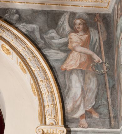 Zdjęcie nr 36: Iluzjonistyczną dekoracją malarską pokryto ściany kaplicy oraz strefę ponadcokołową: ściany tarczowe, pendentywy wokół stiukowych kartuszy herbowych oraz czaszę kopuły i wnętrze latarni. Ściany dolnej części podzielono na dwie strefy. Dolną tworzą zlokalizowane w narożach ścian iluzjonistycznie malowane pary nisz o konchach wypełnionych muszlą. W niszach ukazano osiem stojących frontalnie postaci starców, bez atrybutów i nimbów. Zapewne w ten sposób przedstawiono proroków lub apostołów. Każda z postaci ubrana jest w tunikę oraz płaszcz. Różnicuje je jedynie układ rąk, sposób kształtowania zarostu oraz kolorystyka szat. W drugiej strefie w przyłuczach arkad ukazano całopostaciowe przedstawienia uskrzydlonych aniołów trzymających narzędzia męki Pańskiej. Na ścianie wschodniej anioł prezentuje chustę Weroniki (z prawej) oraz latarnię (z lewej). Po bokach wejścia do kaplicy na ścianie północnej po prawej stronie anioł trzyma lancę i koronę cierniową, a po lewej krzyż. Z kolei na ścianie wschodniej po prawej ukazano anioła z drabiną, a po lewej z gąbką na trzcinie. Natomiast na ścianie południowej, po obu stronach zwieńczenia nagrobka, przedstawiono z prawej anioła z włócznią, a po lewej anioła z wiązką do biczowania. W tej strefie bezpośrednio przy łukach arkad wyobrażono leżące postacie geniuszy malowanych w technice en grisaille. Pod arkadą na ścianie wschodniej (ołtarzowej), ukazano dolną część owalnego jasno ugrowego baldachimu z lambrekinem i zielone, opadające paludamentum, rozsuwane kotarowo przez dwa uskrzydlone anioły. Dekoracja stanowi oprawę dla wiszącego tu obrazu Matki Boskiej z Dzieciątkiem w bogato rzeźbionej ramie. Z kolei na ścianie zachodniej wyobrażono monumentalną scenę Zdjęcia z krzyża. Jest to zwarta kompozycja ogniskująca się na wysokim drewnianym krzyżu, z którego ściągane jest martwe ciało Chrystusa. Z dwóch stron dłuższych ramion krzyż podtrzymują dwaj aniołowie. Ciało Jezusa opuszczane jest na białym pasie tkaniny przewiązanym pod jego ramionami. Chrystus ze zwisającą głową ma ręce ułożone wzdłuż ciała. Biodra przepasane ma białym perizonium. Jego skrzyżowane nogi są ugięte i jeszcze przybite gwoździem do krzyża. Gwóźdź wyciąga z nich obcęgami mężczyzna w niebieskiej, podwiniętej koszuli. Ciało opuszczają dwaj mężczyźni widoczni za poprzecznymi ramionami krzyża, trzymający końce taśmy. Człowiek z lewej strony w niebieskiej koszuli dodatkowo odbiera drugą białą taśmę od mężczyzny ubranego w szaroczarny strój. Osoba ta stoi na drabinie opartej o poprzeczne ramię krzyża. Drugi mężczyzna za krzyżem, w brązowej koszuli, lewą ręką trzyma koniec taśmy, a w uniesionej prawej młotek. Ciało Zbawiciela podtrzymuje lewą ręką kolejny mężczyzna stojący tyłem do widza na drugiej drabinie opartej o lewe ramię krzyża. Jest on ubrany w krótkie brązowe spodenki i bladozieloną koszulę. Pod krzyżem stoi zwarta siedmioosobowa grupa. Najprawdopodobniej z prawej strony ukazano św. Jana i Matkę Boską, na środku dwóch żołnierzy w ostro zakończonych hełmach, dwie kobiety, w tym zapewne Marię Magdalenę i starca widocznego z lewej strony kompozycji. Na ścianach tarczowych nad gzymsem wyobrażono po bokach okrągłych okien siedzących czterech ewangelistów i czterech ojców Kościoła. Na ścianie wschodniej znalazł się z prawej św. Jan z orłem, który w dziobie trzyma złoty kałamarz, a po lewej św. Mateusz rozmawiający z aniołem. Z kolei na ścianie południowej po lewej stronie przedstawiono św. Marka z lwem oraz św. Ambrożego trzymającego w prawej ręce naczynie z wylewającym się miodem. Na ścianie zachodniej z lewej znalazł się czytający św. Augustyn z sercem na dłoni, a z prawej św. Grzegorz Wielki z widoczną za nim tiarą i sową. Na ścianie północnej po lewej ukazano św. Hieronima z leżącym lwem, a po prawej stronie św. Łukasz z wołem. W pendentywach wykonano malarską dekorację w formie wijącej się wstęgi, na tle której widnieją stiukowe kartusze rollwerkowe, o owalnych kaboszonowych polach czwórdzielnych w krzyż. Po stronie wschodniej w pendentywach znajdują się dwa puste kartusze z niezachowanymi herbami. Natomiast herby zachowały się w pendentywach po stronie zachodniej. Na pendentywie północno-zachodnim: Jastrzębiec, Nowina, Gozdawa, Pobóg, a na południowo-zachodnim Gryf, Kotwicz, Kotwicz, Zabawa. W kopule wyobrażono Koronację Matki Boskiej adorowanej przez różnych świętych. Scenę koronacji Marii przez Trójcę Świętą przedstawiono w części wschodniej czaszy. Ukazana frontalnie Maria klęczy ze złożonymi rękami do modlitwy na obłokach. Ma owalną twarz okoloną jasnymi długimi włosami rozsypującymi się na jej ramiona. Na uniesionej ku górze głowie ma ubraną zsuwającą się białą chustę okrywającą włosy. Madonna ubrana jest w zasłaniający jej ramiona bladoniebieski płaszcz, opadający po bokach na obłoki. Nieznacznie wyżej z prawej strony na obłokach siedzi Bóg Ojciec. Wyobrażono go w trzech czwartych w prawo. Jest to starszy mężczyzna o siwych włosach i brodzie. W wyciągniętej prawej ręce nad głową Marii wraz z Chrystusem trzyma złotą koronę w typie zamkniętym. Z kolei w lewej podtrzymuje glob ze złotym krzyżykiem. Bóg Ojciec na głowie ma tiarę papieską. Ubrany jest w szaro-niebieską szatę oraz wzorzystą złotą kapę narzuconą na ramiona i spiętą pod szyją klamrą, z połami okrywającymi nogi. Naprzeciwko siedzi Chrystus widoczny w trzech czwartych w lewo z twarzą ukazaną w profilu. W wyciągniętej prawej ręce trzyma wraz z Bogiem Ojcem koronę, a lewą podtrzymuje złote berło. Chrystus ma jasne włosy opadające puklami na ramiona i podobną krótką brodę. Na głowie ma otwartą złotą koronę. Został przedstawiony z nagim torsem, na którym zaznaczono przebity bok. Jego postać otacza narzucony na ramiona bladoczerwony całun udrapowany w formie płaszcza. Nad koroną bliżej głowy Boga Ojca widoczna jest gołębica Ducha Świętego otoczona świetlistym otokiem. Ponad sceną koronacji wokół otworu do latarni wyobrażono wirujące złocisto-szare obłoki, na tle których widać uskrzydlone główki aniołków oraz postacie mniejszych i większych aniołków, które muzykują na różnych instrumentach, bądź też trzymają gałązki palmowe lub kwiaty albo kwiaty rozsypują. Uskrzydlone główki aniołków widoczne są także pośród obłoków, na których klęczy Madonna. Z prawej strony koronacji wyobrażono dwóch biskupów. Starszy, być może św. Wojciech, został przedstawiony w postawie półklęczącej w trzech czwartych w lewo. Prawą ręką zdaje się wskazywać na scenę koronacji, lewą zaś przyciska do piersi. Ma odkrytą głowę z widocznymi siwymi włosami i taką samą brodą. Ubrany jest w niebiesko-zielonkawą kapę ze złotym kapturem zakończonym chwostem. Na ziemi przy jego stopie widoczna jest złota infuła. Świętemu przyglądają się dwaj aniołowie widoczni z tyłu. Za nim klęczy młodszy biskup z leżącym przy nim na ziemi pastorałem i mieczem. Zapewne jest to św. Stanisław ze Szczepanowa. Święty ukazany został frontalnie z prawą ręką przyciśniętą do piersi, a z lewą nieznacznie odsuniętą w bok. Ma pociągłą twarz o krótkich jasnych włosach i podobnym zaroście. Ubrany jest w albę oraz szaro-bordową kapę o złotym kapturze. Przy jego kolanach stoi złota infuła, a za nim widoczny jest anioł z gałązką palmową. Za św. Stanisławem w rozwianych szatach klęczy św. Jadwiga Śląska, którą identyfikuje bryła kościoła widoczna przy jej stopach. Postać Jadwigi ukazano w profilu z założonymi rękami przed sobą. Na głowie ma niewielką złotą koronę, spod której widoczna jest biała chusta okrywająca włosy. Ubrana jest w bladoczerwoną suknię przepasaną w talii i narzucony na ramiona bladoszkarłatny płaszcz z gronostajowym kołnierzem i obszyciem. Za św. Jadwigą stoi inna święta z odsłoniętą lewą ręką wspartą o bok. Brak atrybutu nie pozwala na jej identyfikację. Ukazano ją w trzech czwartych w prawo z głową w profilu. Ma owalną twarz z wydatnym nosem. Na głowie ma niewielką złotą koronę, spod której widać jasną chustę okrywającą włosy. Ubrana jest w złocisto-szarą suknię z krótkimi rękawami i bladoczerwony rozwiany płaszcz. Pomiędzy obiema kobietami widać dwie postacie uskrzydlonych aniołów. Za świętymi siedzi z otwartą księgą wyobrażony frontalnie św. Jana Kanty. Jest to mężczyzna w średnim wieku z wysokim czołem, krótkimi brązowymi włosami i podobną brodą. Ubrany jest w bladofioletową togę akademicką z gronostajową peleryną. Trzymana przez niego księga ma czerwone okładki. Obok św. Jana Kantego namalowano czteroosobową grupę starszych mężczyzn. Pierwszy z nich, ujętych w trzech czwartych w prawo, zdaje się przyklękając, odbierać prawą ręką palmę męczeństwa podawaną mu przez widocznego nad nim anioła. Lewą ma ułożoną wzdłuż ciała. Ma podłużną twarz widoczną z profilu, otoczoną białymi włosami i spiczastą białą brodą. Ubrany jest w rozwianą jasnobeżową szatę przewiązaną w pasie i taki sam płaszcz narzucony na prawe ramię. Lewy rękaw tuniki jest podciągnięty, odsłaniając przedramię ręki. Na lewej nodze widoczny jest sandał. Za nim przedstawiono klęczącego w ujęciu trzech czwartych w lewo zakonnika eremitę, być może św. Pawła Pustelnika w białym habicie paulińskim. Zakonnik na wysokości bioder ma rozsunięte ręce. Jego twarz o wydatnym nosie otacza krzaczasta, długa, biała broda oraz białe włosy. W głębi za nim częściowo widać dwóch innych brodatych mężczyzn w beżowych szatach. Jeden z nich trzyma w dłoni palmę. W niewielkiej odległości za grupą mężczyzn na pierwszym planie klęczy na obłoku ukazany frontalnie św. Jacek. W rękach uniesionych na wysokości piersi trzyma wieżycową, złotą monstrancję i figurę Matki Boskiej. Dominikanin został przedstawiony z wysokim łysym czołem i wianuszkiem siwiejących włosów. Jego pociągła twarz o wyrazistym nosie i wąskich, nieznacznie zaciśniętych ustach pozbawiona jest zarostu. Ubrany jest w dominikański habit z czarnoniebieskim płaszczem. Z lewej strony sceny koronacji namalowano grupę czterech świętych. Na pierwszym planie widać klęczącego św. Stanisława Kostkę, wspartego na długim kiju z przywiązanym do niego węzełkiem. Święty został przedstawiony w profilu. Ma młodzieńczą, owalną twarz z krótkimi brązowymi włosami i rumianymi policzkami. Ubrany jest w bladobeżowy płaszcz, spod którego widać jasnoseledynową szatę. Za Stanisławem Kostką wyłania się w półpostaci św. Jan Nepomucen z drewnianym krzyżem podtrzymywanym lewą ręką. Jest to dojrzały mężczyzna o pociągłej twarzy, z brązowymi włosami i brodą. Z prawej strony św. Stanisława Kostki ukazano stojące dwie zakonnice, św. Kingę i zapewne bł. Salomeę. Kingę ukazano frontalnie w kontrapoście z głową uniesioną ku niebu w jasnobeżowym habicie klaryski wpadającym w brąz. Księżna prawą ręką przyciska do piersi bryłę soli, a w opuszczonej lewej trzyma kwiat lilii. U jej stóp widać model kościoła klasztornego w Starym Sączu. Obok stoi najprawdopodobniej bł. Salomea. Ukazano ją w mocnym kontrapoście, z dłońmi splecionymi na piersi i spojrzeniem skierowanym ku ziemi. Ubrana jest w rozwiany szaroniebieski habit i jasny welon. Wnętrze latarni wypełniają uskrzydlone głowy aniołków na tle złocisto-szarych obłoków.    







