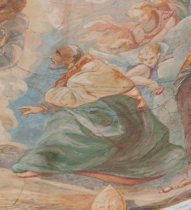 Zdjęcie nr 114: Iluzjonistyczną dekoracją malarską pokryto ściany kaplicy oraz strefę ponadcokołową: ściany tarczowe, pendentywy wokół stiukowych kartuszy herbowych oraz czaszę kopuły i wnętrze latarni. Ściany dolnej części podzielono na dwie strefy. Dolną tworzą zlokalizowane w narożach ścian iluzjonistycznie malowane pary nisz o konchach wypełnionych muszlą. W niszach ukazano osiem stojących frontalnie postaci starców, bez atrybutów i nimbów. Zapewne w ten sposób przedstawiono proroków lub apostołów. Każda z postaci ubrana jest w tunikę oraz płaszcz. Różnicuje je jedynie układ rąk, sposób kształtowania zarostu oraz kolorystyka szat. W drugiej strefie w przyłuczach arkad ukazano całopostaciowe przedstawienia uskrzydlonych aniołów trzymających narzędzia męki Pańskiej. Na ścianie wschodniej anioł prezentuje chustę Weroniki (z prawej) oraz latarnię (z lewej). Po bokach wejścia do kaplicy na ścianie północnej po prawej stronie anioł trzyma lancę i koronę cierniową, a po lewej krzyż. Z kolei na ścianie wschodniej po prawej ukazano anioła z drabiną, a po lewej z gąbką na trzcinie. Natomiast na ścianie południowej, po obu stronach zwieńczenia nagrobka, przedstawiono z prawej anioła z włócznią, a po lewej anioła z wiązką do biczowania. W tej strefie bezpośrednio przy łukach arkad wyobrażono leżące postacie geniuszy malowanych w technice en grisaille. Pod arkadą na ścianie wschodniej (ołtarzowej), ukazano dolną część owalnego jasno ugrowego baldachimu z lambrekinem i zielone, opadające paludamentum, rozsuwane kotarowo przez dwa uskrzydlone anioły. Dekoracja stanowi oprawę dla wiszącego tu obrazu Matki Boskiej z Dzieciątkiem w bogato rzeźbionej ramie. Z kolei na ścianie zachodniej wyobrażono monumentalną scenę Zdjęcia z krzyża. Jest to zwarta kompozycja ogniskująca się na wysokim drewnianym krzyżu, z którego ściągane jest martwe ciało Chrystusa. Z dwóch stron dłuższych ramion krzyż podtrzymują dwaj aniołowie. Ciało Jezusa opuszczane jest na białym pasie tkaniny przewiązanym pod jego ramionami. Chrystus ze zwisającą głową ma ręce ułożone wzdłuż ciała. Biodra przepasane ma białym perizonium. Jego skrzyżowane nogi są ugięte i jeszcze przybite gwoździem do krzyża. Gwóźdź wyciąga z nich obcęgami mężczyzna w niebieskiej, podwiniętej koszuli. Ciało opuszczają dwaj mężczyźni widoczni za poprzecznymi ramionami krzyża, trzymający końce taśmy. Człowiek z lewej strony w niebieskiej koszuli dodatkowo odbiera drugą białą taśmę od mężczyzny ubranego w szaroczarny strój. Osoba ta stoi na drabinie opartej o poprzeczne ramię krzyża. Drugi mężczyzna za krzyżem, w brązowej koszuli, lewą ręką trzyma koniec taśmy, a w uniesionej prawej młotek. Ciało Zbawiciela podtrzymuje lewą ręką kolejny mężczyzna stojący tyłem do widza na drugiej drabinie opartej o lewe ramię krzyża. Jest on ubrany w krótkie brązowe spodenki i bladozieloną koszulę. Pod krzyżem stoi zwarta siedmioosobowa grupa. Najprawdopodobniej z prawej strony ukazano św. Jana i Matkę Boską, na środku dwóch żołnierzy w ostro zakończonych hełmach, dwie kobiety, w tym zapewne Marię Magdalenę i starca widocznego z lewej strony kompozycji. Na ścianach tarczowych nad gzymsem wyobrażono po bokach okrągłych okien siedzących czterech ewangelistów i czterech ojców Kościoła. Na ścianie wschodniej znalazł się z prawej św. Jan z orłem, który w dziobie trzyma złoty kałamarz, a po lewej św. Mateusz rozmawiający z aniołem. Z kolei na ścianie południowej po lewej stronie przedstawiono św. Marka z lwem oraz św. Ambrożego trzymającego w prawej ręce naczynie z wylewającym się miodem. Na ścianie zachodniej z lewej znalazł się czytający św. Augustyn z sercem na dłoni, a z prawej św. Grzegorz Wielki z widoczną za nim tiarą i sową. Na ścianie północnej po lewej ukazano św. Hieronima z leżącym lwem, a po prawej stronie św. Łukasz z wołem. W pendentywach wykonano malarską dekorację w formie wijącej się wstęgi, na tle której widnieją stiukowe kartusze rollwerkowe, o owalnych kaboszonowych polach czwórdzielnych w krzyż. Po stronie wschodniej w pendentywach znajdują się dwa puste kartusze z niezachowanymi herbami. Natomiast herby zachowały się w pendentywach po stronie zachodniej. Na pendentywie północno-zachodnim: Jastrzębiec, Nowina, Gozdawa, Pobóg, a na południowo-zachodnim Gryf, Kotwicz, Kotwicz, Zabawa. W kopule wyobrażono Koronację Matki Boskiej adorowanej przez różnych świętych. Scenę koronacji Marii przez Trójcę Świętą przedstawiono w części wschodniej czaszy. Ukazana frontalnie Maria klęczy ze złożonymi rękami do modlitwy na obłokach. Ma owalną twarz okoloną jasnymi długimi włosami rozsypującymi się na jej ramiona. Na uniesionej ku górze głowie ma ubraną zsuwającą się białą chustę okrywającą włosy. Madonna ubrana jest w zasłaniający jej ramiona bladoniebieski płaszcz, opadający po bokach na obłoki. Nieznacznie wyżej z prawej strony na obłokach siedzi Bóg Ojciec. Wyobrażono go w trzech czwartych w prawo. Jest to starszy mężczyzna o siwych włosach i brodzie. W wyciągniętej prawej ręce nad głową Marii wraz z Chrystusem trzyma złotą koronę w typie zamkniętym. Z kolei w lewej podtrzymuje glob ze złotym krzyżykiem. Bóg Ojciec na głowie ma tiarę papieską. Ubrany jest w szaro-niebieską szatę oraz wzorzystą złotą kapę narzuconą na ramiona i spiętą pod szyją klamrą, z połami okrywającymi nogi. Naprzeciwko siedzi Chrystus widoczny w trzech czwartych w lewo z twarzą ukazaną w profilu. W wyciągniętej prawej ręce trzyma wraz z Bogiem Ojcem koronę, a lewą podtrzymuje złote berło. Chrystus ma jasne włosy opadające puklami na ramiona i podobną krótką brodę. Na głowie ma otwartą złotą koronę. Został przedstawiony z nagim torsem, na którym zaznaczono przebity bok. Jego postać otacza narzucony na ramiona bladoczerwony całun udrapowany w formie płaszcza. Nad koroną bliżej głowy Boga Ojca widoczna jest gołębica Ducha Świętego otoczona świetlistym otokiem. Ponad sceną koronacji wokół otworu do latarni wyobrażono wirujące złocisto-szare obłoki, na tle których widać uskrzydlone główki aniołków oraz postacie mniejszych i większych aniołków, które muzykują na różnych instrumentach, bądź też trzymają gałązki palmowe lub kwiaty albo kwiaty rozsypują. Uskrzydlone główki aniołków widoczne są także pośród obłoków, na których klęczy Madonna. Z prawej strony koronacji wyobrażono dwóch biskupów. Starszy, być może św. Wojciech, został przedstawiony w postawie półklęczącej w trzech czwartych w lewo. Prawą ręką zdaje się wskazywać na scenę koronacji, lewą zaś przyciska do piersi. Ma odkrytą głowę z widocznymi siwymi włosami i taką samą brodą. Ubrany jest w niebiesko-zielonkawą kapę ze złotym kapturem zakończonym chwostem. Na ziemi przy jego stopie widoczna jest złota infuła. Świętemu przyglądają się dwaj aniołowie widoczni z tyłu. Za nim klęczy młodszy biskup z leżącym przy nim na ziemi pastorałem i mieczem. Zapewne jest to św. Stanisław ze Szczepanowa. Święty ukazany został frontalnie z prawą ręką przyciśniętą do piersi, a z lewą nieznacznie odsuniętą w bok. Ma pociągłą twarz o krótkich jasnych włosach i podobnym zaroście. Ubrany jest w albę oraz szaro-bordową kapę o złotym kapturze. Przy jego kolanach stoi złota infuła, a za nim widoczny jest anioł z gałązką palmową. Za św. Stanisławem w rozwianych szatach klęczy św. Jadwiga Śląska, którą identyfikuje bryła kościoła widoczna przy jej stopach. Postać Jadwigi ukazano w profilu z założonymi rękami przed sobą. Na głowie ma niewielką złotą koronę, spod której widoczna jest biała chusta okrywająca włosy. Ubrana jest w bladoczerwoną suknię przepasaną w talii i narzucony na ramiona bladoszkarłatny płaszcz z gronostajowym kołnierzem i obszyciem. Za św. Jadwigą stoi inna święta z odsłoniętą lewą ręką wspartą o bok. Brak atrybutu nie pozwala na jej identyfikację. Ukazano ją w trzech czwartych w prawo z głową w profilu. Ma owalną twarz z wydatnym nosem. Na głowie ma niewielką złotą koronę, spod której widać jasną chustę okrywającą włosy. Ubrana jest w złocisto-szarą suknię z krótkimi rękawami i bladoczerwony rozwiany płaszcz. Pomiędzy obiema kobietami widać dwie postacie uskrzydlonych aniołów. Za świętymi siedzi z otwartą księgą wyobrażony frontalnie św. Jana Kanty. Jest to mężczyzna w średnim wieku z wysokim czołem, krótkimi brązowymi włosami i podobną brodą. Ubrany jest w bladofioletową togę akademicką z gronostajową peleryną. Trzymana przez niego księga ma czerwone okładki. Obok św. Jana Kantego namalowano czteroosobową grupę starszych mężczyzn. Pierwszy z nich, ujętych w trzech czwartych w prawo, zdaje się przyklękając, odbierać prawą ręką palmę męczeństwa podawaną mu przez widocznego nad nim anioła. Lewą ma ułożoną wzdłuż ciała. Ma podłużną twarz widoczną z profilu, otoczoną białymi włosami i spiczastą białą brodą. Ubrany jest w rozwianą jasnobeżową szatę przewiązaną w pasie i taki sam płaszcz narzucony na prawe ramię. Lewy rękaw tuniki jest podciągnięty, odsłaniając przedramię ręki. Na lewej nodze widoczny jest sandał. Za nim przedstawiono klęczącego w ujęciu trzech czwartych w lewo zakonnika eremitę, być może św. Pawła Pustelnika w białym habicie paulińskim. Zakonnik na wysokości bioder ma rozsunięte ręce. Jego twarz o wydatnym nosie otacza krzaczasta, długa, biała broda oraz białe włosy. W głębi za nim częściowo widać dwóch innych brodatych mężczyzn w beżowych szatach. Jeden z nich trzyma w dłoni palmę. W niewielkiej odległości za grupą mężczyzn na pierwszym planie klęczy na obłoku ukazany frontalnie św. Jacek. W rękach uniesionych na wysokości piersi trzyma wieżycową, złotą monstrancję i figurę Matki Boskiej. Dominikanin został przedstawiony z wysokim łysym czołem i wianuszkiem siwiejących włosów. Jego pociągła twarz o wyrazistym nosie i wąskich, nieznacznie zaciśniętych ustach pozbawiona jest zarostu. Ubrany jest w dominikański habit z czarnoniebieskim płaszczem. Z lewej strony sceny koronacji namalowano grupę czterech świętych. Na pierwszym planie widać klęczącego św. Stanisława Kostkę, wspartego na długim kiju z przywiązanym do niego węzełkiem. Święty został przedstawiony w profilu. Ma młodzieńczą, owalną twarz z krótkimi brązowymi włosami i rumianymi policzkami. Ubrany jest w bladobeżowy płaszcz, spod którego widać jasnoseledynową szatę. Za Stanisławem Kostką wyłania się w półpostaci św. Jan Nepomucen z drewnianym krzyżem podtrzymywanym lewą ręką. Jest to dojrzały mężczyzna o pociągłej twarzy, z brązowymi włosami i brodą. Z prawej strony św. Stanisława Kostki ukazano stojące dwie zakonnice, św. Kingę i zapewne bł. Salomeę. Kingę ukazano frontalnie w kontrapoście z głową uniesioną ku niebu w jasnobeżowym habicie klaryski wpadającym w brąz. Księżna prawą ręką przyciska do piersi bryłę soli, a w opuszczonej lewej trzyma kwiat lilii. U jej stóp widać model kościoła klasztornego w Starym Sączu. Obok stoi najprawdopodobniej bł. Salomea. Ukazano ją w mocnym kontrapoście, z dłońmi splecionymi na piersi i spojrzeniem skierowanym ku ziemi. Ubrana jest w rozwiany szaroniebieski habit i jasny welon. Wnętrze latarni wypełniają uskrzydlone głowy aniołków na tle złocisto-szarych obłoków.    







