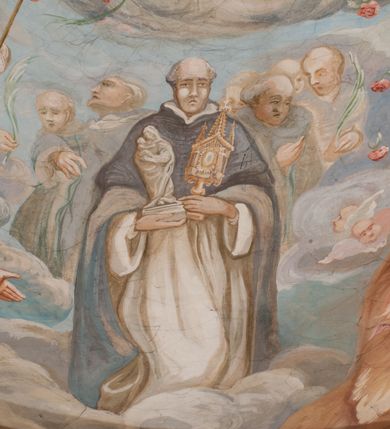 Zdjęcie nr 136: Iluzjonistyczną dekoracją malarską pokryto ściany kaplicy oraz strefę ponadcokołową: ściany tarczowe, pendentywy wokół stiukowych kartuszy herbowych oraz czaszę kopuły i wnętrze latarni. Ściany dolnej części podzielono na dwie strefy. Dolną tworzą zlokalizowane w narożach ścian iluzjonistycznie malowane pary nisz o konchach wypełnionych muszlą. W niszach ukazano osiem stojących frontalnie postaci starców, bez atrybutów i nimbów. Zapewne w ten sposób przedstawiono proroków lub apostołów. Każda z postaci ubrana jest w tunikę oraz płaszcz. Różnicuje je jedynie układ rąk, sposób kształtowania zarostu oraz kolorystyka szat. W drugiej strefie w przyłuczach arkad ukazano całopostaciowe przedstawienia uskrzydlonych aniołów trzymających narzędzia męki Pańskiej. Na ścianie wschodniej anioł prezentuje chustę Weroniki (z prawej) oraz latarnię (z lewej). Po bokach wejścia do kaplicy na ścianie północnej po prawej stronie anioł trzyma lancę i koronę cierniową, a po lewej krzyż. Z kolei na ścianie wschodniej po prawej ukazano anioła z drabiną, a po lewej z gąbką na trzcinie. Natomiast na ścianie południowej, po obu stronach zwieńczenia nagrobka, przedstawiono z prawej anioła z włócznią, a po lewej anioła z wiązką do biczowania. W tej strefie bezpośrednio przy łukach arkad wyobrażono leżące postacie geniuszy malowanych w technice en grisaille. Pod arkadą na ścianie wschodniej (ołtarzowej), ukazano dolną część owalnego jasno ugrowego baldachimu z lambrekinem i zielone, opadające paludamentum, rozsuwane kotarowo przez dwa uskrzydlone anioły. Dekoracja stanowi oprawę dla wiszącego tu obrazu Matki Boskiej z Dzieciątkiem w bogato rzeźbionej ramie. Z kolei na ścianie zachodniej wyobrażono monumentalną scenę Zdjęcia z krzyża. Jest to zwarta kompozycja ogniskująca się na wysokim drewnianym krzyżu, z którego ściągane jest martwe ciało Chrystusa. Z dwóch stron dłuższych ramion krzyż podtrzymują dwaj aniołowie. Ciało Jezusa opuszczane jest na białym pasie tkaniny przewiązanym pod jego ramionami. Chrystus ze zwisającą głową ma ręce ułożone wzdłuż ciała. Biodra przepasane ma białym perizonium. Jego skrzyżowane nogi są ugięte i jeszcze przybite gwoździem do krzyża. Gwóźdź wyciąga z nich obcęgami mężczyzna w niebieskiej, podwiniętej koszuli. Ciało opuszczają dwaj mężczyźni widoczni za poprzecznymi ramionami krzyża, trzymający końce taśmy. Człowiek z lewej strony w niebieskiej koszuli dodatkowo odbiera drugą białą taśmę od mężczyzny ubranego w szaroczarny strój. Osoba ta stoi na drabinie opartej o poprzeczne ramię krzyża. Drugi mężczyzna za krzyżem, w brązowej koszuli, lewą ręką trzyma koniec taśmy, a w uniesionej prawej młotek. Ciało Zbawiciela podtrzymuje lewą ręką kolejny mężczyzna stojący tyłem do widza na drugiej drabinie opartej o lewe ramię krzyża. Jest on ubrany w krótkie brązowe spodenki i bladozieloną koszulę. Pod krzyżem stoi zwarta siedmioosobowa grupa. Najprawdopodobniej z prawej strony ukazano św. Jana i Matkę Boską, na środku dwóch żołnierzy w ostro zakończonych hełmach, dwie kobiety, w tym zapewne Marię Magdalenę i starca widocznego z lewej strony kompozycji. Na ścianach tarczowych nad gzymsem wyobrażono po bokach okrągłych okien siedzących czterech ewangelistów i czterech ojców Kościoła. Na ścianie wschodniej znalazł się z prawej św. Jan z orłem, który w dziobie trzyma złoty kałamarz, a po lewej św. Mateusz rozmawiający z aniołem. Z kolei na ścianie południowej po lewej stronie przedstawiono św. Marka z lwem oraz św. Ambrożego trzymającego w prawej ręce naczynie z wylewającym się miodem. Na ścianie zachodniej z lewej znalazł się czytający św. Augustyn z sercem na dłoni, a z prawej św. Grzegorz Wielki z widoczną za nim tiarą i sową. Na ścianie północnej po lewej ukazano św. Hieronima z leżącym lwem, a po prawej stronie św. Łukasz z wołem. W pendentywach wykonano malarską dekorację w formie wijącej się wstęgi, na tle której widnieją stiukowe kartusze rollwerkowe, o owalnych kaboszonowych polach czwórdzielnych w krzyż. Po stronie wschodniej w pendentywach znajdują się dwa puste kartusze z niezachowanymi herbami. Natomiast herby zachowały się w pendentywach po stronie zachodniej. Na pendentywie północno-zachodnim: Jastrzębiec, Nowina, Gozdawa, Pobóg, a na południowo-zachodnim Gryf, Kotwicz, Kotwicz, Zabawa. W kopule wyobrażono Koronację Matki Boskiej adorowanej przez różnych świętych. Scenę koronacji Marii przez Trójcę Świętą przedstawiono w części wschodniej czaszy. Ukazana frontalnie Maria klęczy ze złożonymi rękami do modlitwy na obłokach. Ma owalną twarz okoloną jasnymi długimi włosami rozsypującymi się na jej ramiona. Na uniesionej ku górze głowie ma ubraną zsuwającą się białą chustę okrywającą włosy. Madonna ubrana jest w zasłaniający jej ramiona bladoniebieski płaszcz, opadający po bokach na obłoki. Nieznacznie wyżej z prawej strony na obłokach siedzi Bóg Ojciec. Wyobrażono go w trzech czwartych w prawo. Jest to starszy mężczyzna o siwych włosach i brodzie. W wyciągniętej prawej ręce nad głową Marii wraz z Chrystusem trzyma złotą koronę w typie zamkniętym. Z kolei w lewej podtrzymuje glob ze złotym krzyżykiem. Bóg Ojciec na głowie ma tiarę papieską. Ubrany jest w szaro-niebieską szatę oraz wzorzystą złotą kapę narzuconą na ramiona i spiętą pod szyją klamrą, z połami okrywającymi nogi. Naprzeciwko siedzi Chrystus widoczny w trzech czwartych w lewo z twarzą ukazaną w profilu. W wyciągniętej prawej ręce trzyma wraz z Bogiem Ojcem koronę, a lewą podtrzymuje złote berło. Chrystus ma jasne włosy opadające puklami na ramiona i podobną krótką brodę. Na głowie ma otwartą złotą koronę. Został przedstawiony z nagim torsem, na którym zaznaczono przebity bok. Jego postać otacza narzucony na ramiona bladoczerwony całun udrapowany w formie płaszcza. Nad koroną bliżej głowy Boga Ojca widoczna jest gołębica Ducha Świętego otoczona świetlistym otokiem. Ponad sceną koronacji wokół otworu do latarni wyobrażono wirujące złocisto-szare obłoki, na tle których widać uskrzydlone główki aniołków oraz postacie mniejszych i większych aniołków, które muzykują na różnych instrumentach, bądź też trzymają gałązki palmowe lub kwiaty albo kwiaty rozsypują. Uskrzydlone główki aniołków widoczne są także pośród obłoków, na których klęczy Madonna. Z prawej strony koronacji wyobrażono dwóch biskupów. Starszy, być może św. Wojciech, został przedstawiony w postawie półklęczącej w trzech czwartych w lewo. Prawą ręką zdaje się wskazywać na scenę koronacji, lewą zaś przyciska do piersi. Ma odkrytą głowę z widocznymi siwymi włosami i taką samą brodą. Ubrany jest w niebiesko-zielonkawą kapę ze złotym kapturem zakończonym chwostem. Na ziemi przy jego stopie widoczna jest złota infuła. Świętemu przyglądają się dwaj aniołowie widoczni z tyłu. Za nim klęczy młodszy biskup z leżącym przy nim na ziemi pastorałem i mieczem. Zapewne jest to św. Stanisław ze Szczepanowa. Święty ukazany został frontalnie z prawą ręką przyciśniętą do piersi, a z lewą nieznacznie odsuniętą w bok. Ma pociągłą twarz o krótkich jasnych włosach i podobnym zaroście. Ubrany jest w albę oraz szaro-bordową kapę o złotym kapturze. Przy jego kolanach stoi złota infuła, a za nim widoczny jest anioł z gałązką palmową. Za św. Stanisławem w rozwianych szatach klęczy św. Jadwiga Śląska, którą identyfikuje bryła kościoła widoczna przy jej stopach. Postać Jadwigi ukazano w profilu z założonymi rękami przed sobą. Na głowie ma niewielką złotą koronę, spod której widoczna jest biała chusta okrywająca włosy. Ubrana jest w bladoczerwoną suknię przepasaną w talii i narzucony na ramiona bladoszkarłatny płaszcz z gronostajowym kołnierzem i obszyciem. Za św. Jadwigą stoi inna święta z odsłoniętą lewą ręką wspartą o bok. Brak atrybutu nie pozwala na jej identyfikację. Ukazano ją w trzech czwartych w prawo z głową w profilu. Ma owalną twarz z wydatnym nosem. Na głowie ma niewielką złotą koronę, spod której widać jasną chustę okrywającą włosy. Ubrana jest w złocisto-szarą suknię z krótkimi rękawami i bladoczerwony rozwiany płaszcz. Pomiędzy obiema kobietami widać dwie postacie uskrzydlonych aniołów. Za świętymi siedzi z otwartą księgą wyobrażony frontalnie św. Jana Kanty. Jest to mężczyzna w średnim wieku z wysokim czołem, krótkimi brązowymi włosami i podobną brodą. Ubrany jest w bladofioletową togę akademicką z gronostajową peleryną. Trzymana przez niego księga ma czerwone okładki. Obok św. Jana Kantego namalowano czteroosobową grupę starszych mężczyzn. Pierwszy z nich, ujętych w trzech czwartych w prawo, zdaje się przyklękając, odbierać prawą ręką palmę męczeństwa podawaną mu przez widocznego nad nim anioła. Lewą ma ułożoną wzdłuż ciała. Ma podłużną twarz widoczną z profilu, otoczoną białymi włosami i spiczastą białą brodą. Ubrany jest w rozwianą jasnobeżową szatę przewiązaną w pasie i taki sam płaszcz narzucony na prawe ramię. Lewy rękaw tuniki jest podciągnięty, odsłaniając przedramię ręki. Na lewej nodze widoczny jest sandał. Za nim przedstawiono klęczącego w ujęciu trzech czwartych w lewo zakonnika eremitę, być może św. Pawła Pustelnika w białym habicie paulińskim. Zakonnik na wysokości bioder ma rozsunięte ręce. Jego twarz o wydatnym nosie otacza krzaczasta, długa, biała broda oraz białe włosy. W głębi za nim częściowo widać dwóch innych brodatych mężczyzn w beżowych szatach. Jeden z nich trzyma w dłoni palmę. W niewielkiej odległości za grupą mężczyzn na pierwszym planie klęczy na obłoku ukazany frontalnie św. Jacek. W rękach uniesionych na wysokości piersi trzyma wieżycową, złotą monstrancję i figurę Matki Boskiej. Dominikanin został przedstawiony z wysokim łysym czołem i wianuszkiem siwiejących włosów. Jego pociągła twarz o wyrazistym nosie i wąskich, nieznacznie zaciśniętych ustach pozbawiona jest zarostu. Ubrany jest w dominikański habit z czarnoniebieskim płaszczem. Z lewej strony sceny koronacji namalowano grupę czterech świętych. Na pierwszym planie widać klęczącego św. Stanisława Kostkę, wspartego na długim kiju z przywiązanym do niego węzełkiem. Święty został przedstawiony w profilu. Ma młodzieńczą, owalną twarz z krótkimi brązowymi włosami i rumianymi policzkami. Ubrany jest w bladobeżowy płaszcz, spod którego widać jasnoseledynową szatę. Za Stanisławem Kostką wyłania się w półpostaci św. Jan Nepomucen z drewnianym krzyżem podtrzymywanym lewą ręką. Jest to dojrzały mężczyzna o pociągłej twarzy, z brązowymi włosami i brodą. Z prawej strony św. Stanisława Kostki ukazano stojące dwie zakonnice, św. Kingę i zapewne bł. Salomeę. Kingę ukazano frontalnie w kontrapoście z głową uniesioną ku niebu w jasnobeżowym habicie klaryski wpadającym w brąz. Księżna prawą ręką przyciska do piersi bryłę soli, a w opuszczonej lewej trzyma kwiat lilii. U jej stóp widać model kościoła klasztornego w Starym Sączu. Obok stoi najprawdopodobniej bł. Salomea. Ukazano ją w mocnym kontrapoście, z dłońmi splecionymi na piersi i spojrzeniem skierowanym ku ziemi. Ubrana jest w rozwiany szaroniebieski habit i jasny welon. Wnętrze latarni wypełniają uskrzydlone głowy aniołków na tle złocisto-szarych obłoków.    







