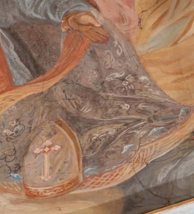 Zdjęcie nr 149: Iluzjonistyczną dekoracją malarską pokryto ściany kaplicy oraz strefę ponadcokołową: ściany tarczowe, pendentywy wokół stiukowych kartuszy herbowych oraz czaszę kopuły i wnętrze latarni. Ściany dolnej części podzielono na dwie strefy. Dolną tworzą zlokalizowane w narożach ścian iluzjonistycznie malowane pary nisz o konchach wypełnionych muszlą. W niszach ukazano osiem stojących frontalnie postaci starców, bez atrybutów i nimbów. Zapewne w ten sposób przedstawiono proroków lub apostołów. Każda z postaci ubrana jest w tunikę oraz płaszcz. Różnicuje je jedynie układ rąk, sposób kształtowania zarostu oraz kolorystyka szat. W drugiej strefie w przyłuczach arkad ukazano całopostaciowe przedstawienia uskrzydlonych aniołów trzymających narzędzia męki Pańskiej. Na ścianie wschodniej anioł prezentuje chustę Weroniki (z prawej) oraz latarnię (z lewej). Po bokach wejścia do kaplicy na ścianie północnej po prawej stronie anioł trzyma lancę i koronę cierniową, a po lewej krzyż. Z kolei na ścianie wschodniej po prawej ukazano anioła z drabiną, a po lewej z gąbką na trzcinie. Natomiast na ścianie południowej, po obu stronach zwieńczenia nagrobka, przedstawiono z prawej anioła z włócznią, a po lewej anioła z wiązką do biczowania. W tej strefie bezpośrednio przy łukach arkad wyobrażono leżące postacie geniuszy malowanych w technice en grisaille. Pod arkadą na ścianie wschodniej (ołtarzowej), ukazano dolną część owalnego jasno ugrowego baldachimu z lambrekinem i zielone, opadające paludamentum, rozsuwane kotarowo przez dwa uskrzydlone anioły. Dekoracja stanowi oprawę dla wiszącego tu obrazu Matki Boskiej z Dzieciątkiem w bogato rzeźbionej ramie. Z kolei na ścianie zachodniej wyobrażono monumentalną scenę Zdjęcia z krzyża. Jest to zwarta kompozycja ogniskująca się na wysokim drewnianym krzyżu, z którego ściągane jest martwe ciało Chrystusa. Z dwóch stron dłuższych ramion krzyż podtrzymują dwaj aniołowie. Ciało Jezusa opuszczane jest na białym pasie tkaniny przewiązanym pod jego ramionami. Chrystus ze zwisającą głową ma ręce ułożone wzdłuż ciała. Biodra przepasane ma białym perizonium. Jego skrzyżowane nogi są ugięte i jeszcze przybite gwoździem do krzyża. Gwóźdź wyciąga z nich obcęgami mężczyzna w niebieskiej, podwiniętej koszuli. Ciało opuszczają dwaj mężczyźni widoczni za poprzecznymi ramionami krzyża, trzymający końce taśmy. Człowiek z lewej strony w niebieskiej koszuli dodatkowo odbiera drugą białą taśmę od mężczyzny ubranego w szaroczarny strój. Osoba ta stoi na drabinie opartej o poprzeczne ramię krzyża. Drugi mężczyzna za krzyżem, w brązowej koszuli, lewą ręką trzyma koniec taśmy, a w uniesionej prawej młotek. Ciało Zbawiciela podtrzymuje lewą ręką kolejny mężczyzna stojący tyłem do widza na drugiej drabinie opartej o lewe ramię krzyża. Jest on ubrany w krótkie brązowe spodenki i bladozieloną koszulę. Pod krzyżem stoi zwarta siedmioosobowa grupa. Najprawdopodobniej z prawej strony ukazano św. Jana i Matkę Boską, na środku dwóch żołnierzy w ostro zakończonych hełmach, dwie kobiety, w tym zapewne Marię Magdalenę i starca widocznego z lewej strony kompozycji. Na ścianach tarczowych nad gzymsem wyobrażono po bokach okrągłych okien siedzących czterech ewangelistów i czterech ojców Kościoła. Na ścianie wschodniej znalazł się z prawej św. Jan z orłem, który w dziobie trzyma złoty kałamarz, a po lewej św. Mateusz rozmawiający z aniołem. Z kolei na ścianie południowej po lewej stronie przedstawiono św. Marka z lwem oraz św. Ambrożego trzymającego w prawej ręce naczynie z wylewającym się miodem. Na ścianie zachodniej z lewej znalazł się czytający św. Augustyn z sercem na dłoni, a z prawej św. Grzegorz Wielki z widoczną za nim tiarą i sową. Na ścianie północnej po lewej ukazano św. Hieronima z leżącym lwem, a po prawej stronie św. Łukasz z wołem. W pendentywach wykonano malarską dekorację w formie wijącej się wstęgi, na tle której widnieją stiukowe kartusze rollwerkowe, o owalnych kaboszonowych polach czwórdzielnych w krzyż. Po stronie wschodniej w pendentywach znajdują się dwa puste kartusze z niezachowanymi herbami. Natomiast herby zachowały się w pendentywach po stronie zachodniej. Na pendentywie północno-zachodnim: Jastrzębiec, Nowina, Gozdawa, Pobóg, a na południowo-zachodnim Gryf, Kotwicz, Kotwicz, Zabawa. W kopule wyobrażono Koronację Matki Boskiej adorowanej przez różnych świętych. Scenę koronacji Marii przez Trójcę Świętą przedstawiono w części wschodniej czaszy. Ukazana frontalnie Maria klęczy ze złożonymi rękami do modlitwy na obłokach. Ma owalną twarz okoloną jasnymi długimi włosami rozsypującymi się na jej ramiona. Na uniesionej ku górze głowie ma ubraną zsuwającą się białą chustę okrywającą włosy. Madonna ubrana jest w zasłaniający jej ramiona bladoniebieski płaszcz, opadający po bokach na obłoki. Nieznacznie wyżej z prawej strony na obłokach siedzi Bóg Ojciec. Wyobrażono go w trzech czwartych w prawo. Jest to starszy mężczyzna o siwych włosach i brodzie. W wyciągniętej prawej ręce nad głową Marii wraz z Chrystusem trzyma złotą koronę w typie zamkniętym. Z kolei w lewej podtrzymuje glob ze złotym krzyżykiem. Bóg Ojciec na głowie ma tiarę papieską. Ubrany jest w szaro-niebieską szatę oraz wzorzystą złotą kapę narzuconą na ramiona i spiętą pod szyją klamrą, z połami okrywającymi nogi. Naprzeciwko siedzi Chrystus widoczny w trzech czwartych w lewo z twarzą ukazaną w profilu. W wyciągniętej prawej ręce trzyma wraz z Bogiem Ojcem koronę, a lewą podtrzymuje złote berło. Chrystus ma jasne włosy opadające puklami na ramiona i podobną krótką brodę. Na głowie ma otwartą złotą koronę. Został przedstawiony z nagim torsem, na którym zaznaczono przebity bok. Jego postać otacza narzucony na ramiona bladoczerwony całun udrapowany w formie płaszcza. Nad koroną bliżej głowy Boga Ojca widoczna jest gołębica Ducha Świętego otoczona świetlistym otokiem. Ponad sceną koronacji wokół otworu do latarni wyobrażono wirujące złocisto-szare obłoki, na tle których widać uskrzydlone główki aniołków oraz postacie mniejszych i większych aniołków, które muzykują na różnych instrumentach, bądź też trzymają gałązki palmowe lub kwiaty albo kwiaty rozsypują. Uskrzydlone główki aniołków widoczne są także pośród obłoków, na których klęczy Madonna. Z prawej strony koronacji wyobrażono dwóch biskupów. Starszy, być może św. Wojciech, został przedstawiony w postawie półklęczącej w trzech czwartych w lewo. Prawą ręką zdaje się wskazywać na scenę koronacji, lewą zaś przyciska do piersi. Ma odkrytą głowę z widocznymi siwymi włosami i taką samą brodą. Ubrany jest w niebiesko-zielonkawą kapę ze złotym kapturem zakończonym chwostem. Na ziemi przy jego stopie widoczna jest złota infuła. Świętemu przyglądają się dwaj aniołowie widoczni z tyłu. Za nim klęczy młodszy biskup z leżącym przy nim na ziemi pastorałem i mieczem. Zapewne jest to św. Stanisław ze Szczepanowa. Święty ukazany został frontalnie z prawą ręką przyciśniętą do piersi, a z lewą nieznacznie odsuniętą w bok. Ma pociągłą twarz o krótkich jasnych włosach i podobnym zaroście. Ubrany jest w albę oraz szaro-bordową kapę o złotym kapturze. Przy jego kolanach stoi złota infuła, a za nim widoczny jest anioł z gałązką palmową. Za św. Stanisławem w rozwianych szatach klęczy św. Jadwiga Śląska, którą identyfikuje bryła kościoła widoczna przy jej stopach. Postać Jadwigi ukazano w profilu z założonymi rękami przed sobą. Na głowie ma niewielką złotą koronę, spod której widoczna jest biała chusta okrywająca włosy. Ubrana jest w bladoczerwoną suknię przepasaną w talii i narzucony na ramiona bladoszkarłatny płaszcz z gronostajowym kołnierzem i obszyciem. Za św. Jadwigą stoi inna święta z odsłoniętą lewą ręką wspartą o bok. Brak atrybutu nie pozwala na jej identyfikację. Ukazano ją w trzech czwartych w prawo z głową w profilu. Ma owalną twarz z wydatnym nosem. Na głowie ma niewielką złotą koronę, spod której widać jasną chustę okrywającą włosy. Ubrana jest w złocisto-szarą suknię z krótkimi rękawami i bladoczerwony rozwiany płaszcz. Pomiędzy obiema kobietami widać dwie postacie uskrzydlonych aniołów. Za świętymi siedzi z otwartą księgą wyobrażony frontalnie św. Jana Kanty. Jest to mężczyzna w średnim wieku z wysokim czołem, krótkimi brązowymi włosami i podobną brodą. Ubrany jest w bladofioletową togę akademicką z gronostajową peleryną. Trzymana przez niego księga ma czerwone okładki. Obok św. Jana Kantego namalowano czteroosobową grupę starszych mężczyzn. Pierwszy z nich, ujętych w trzech czwartych w prawo, zdaje się przyklękając, odbierać prawą ręką palmę męczeństwa podawaną mu przez widocznego nad nim anioła. Lewą ma ułożoną wzdłuż ciała. Ma podłużną twarz widoczną z profilu, otoczoną białymi włosami i spiczastą białą brodą. Ubrany jest w rozwianą jasnobeżową szatę przewiązaną w pasie i taki sam płaszcz narzucony na prawe ramię. Lewy rękaw tuniki jest podciągnięty, odsłaniając przedramię ręki. Na lewej nodze widoczny jest sandał. Za nim przedstawiono klęczącego w ujęciu trzech czwartych w lewo zakonnika eremitę, być może św. Pawła Pustelnika w białym habicie paulińskim. Zakonnik na wysokości bioder ma rozsunięte ręce. Jego twarz o wydatnym nosie otacza krzaczasta, długa, biała broda oraz białe włosy. W głębi za nim częściowo widać dwóch innych brodatych mężczyzn w beżowych szatach. Jeden z nich trzyma w dłoni palmę. W niewielkiej odległości za grupą mężczyzn na pierwszym planie klęczy na obłoku ukazany frontalnie św. Jacek. W rękach uniesionych na wysokości piersi trzyma wieżycową, złotą monstrancję i figurę Matki Boskiej. Dominikanin został przedstawiony z wysokim łysym czołem i wianuszkiem siwiejących włosów. Jego pociągła twarz o wyrazistym nosie i wąskich, nieznacznie zaciśniętych ustach pozbawiona jest zarostu. Ubrany jest w dominikański habit z czarnoniebieskim płaszczem. Z lewej strony sceny koronacji namalowano grupę czterech świętych. Na pierwszym planie widać klęczącego św. Stanisława Kostkę, wspartego na długim kiju z przywiązanym do niego węzełkiem. Święty został przedstawiony w profilu. Ma młodzieńczą, owalną twarz z krótkimi brązowymi włosami i rumianymi policzkami. Ubrany jest w bladobeżowy płaszcz, spod którego widać jasnoseledynową szatę. Za Stanisławem Kostką wyłania się w półpostaci św. Jan Nepomucen z drewnianym krzyżem podtrzymywanym lewą ręką. Jest to dojrzały mężczyzna o pociągłej twarzy, z brązowymi włosami i brodą. Z prawej strony św. Stanisława Kostki ukazano stojące dwie zakonnice, św. Kingę i zapewne bł. Salomeę. Kingę ukazano frontalnie w kontrapoście z głową uniesioną ku niebu w jasnobeżowym habicie klaryski wpadającym w brąz. Księżna prawą ręką przyciska do piersi bryłę soli, a w opuszczonej lewej trzyma kwiat lilii. U jej stóp widać model kościoła klasztornego w Starym Sączu. Obok stoi najprawdopodobniej bł. Salomea. Ukazano ją w mocnym kontrapoście, z dłońmi splecionymi na piersi i spojrzeniem skierowanym ku ziemi. Ubrana jest w rozwiany szaroniebieski habit i jasny welon. Wnętrze latarni wypełniają uskrzydlone głowy aniołków na tle złocisto-szarych obłoków.    







