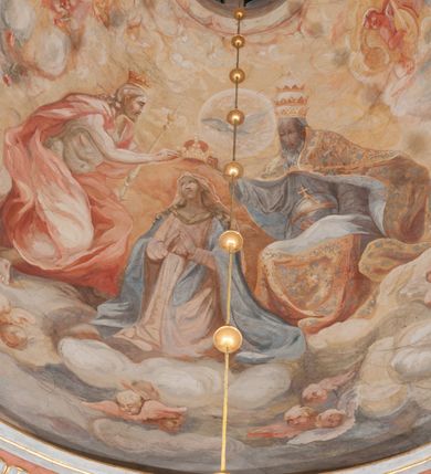 Zdjęcie nr 156: Iluzjonistyczną dekoracją malarską pokryto ściany kaplicy oraz strefę ponadcokołową: ściany tarczowe, pendentywy wokół stiukowych kartuszy herbowych oraz czaszę kopuły i wnętrze latarni. Ściany dolnej części podzielono na dwie strefy. Dolną tworzą zlokalizowane w narożach ścian iluzjonistycznie malowane pary nisz o konchach wypełnionych muszlą. W niszach ukazano osiem stojących frontalnie postaci starców, bez atrybutów i nimbów. Zapewne w ten sposób przedstawiono proroków lub apostołów. Każda z postaci ubrana jest w tunikę oraz płaszcz. Różnicuje je jedynie układ rąk, sposób kształtowania zarostu oraz kolorystyka szat. W drugiej strefie w przyłuczach arkad ukazano całopostaciowe przedstawienia uskrzydlonych aniołów trzymających narzędzia męki Pańskiej. Na ścianie wschodniej anioł prezentuje chustę Weroniki (z prawej) oraz latarnię (z lewej). Po bokach wejścia do kaplicy na ścianie północnej po prawej stronie anioł trzyma lancę i koronę cierniową, a po lewej krzyż. Z kolei na ścianie wschodniej po prawej ukazano anioła z drabiną, a po lewej z gąbką na trzcinie. Natomiast na ścianie południowej, po obu stronach zwieńczenia nagrobka, przedstawiono z prawej anioła z włócznią, a po lewej anioła z wiązką do biczowania. W tej strefie bezpośrednio przy łukach arkad wyobrażono leżące postacie geniuszy malowanych w technice en grisaille. Pod arkadą na ścianie wschodniej (ołtarzowej), ukazano dolną część owalnego jasno ugrowego baldachimu z lambrekinem i zielone, opadające paludamentum, rozsuwane kotarowo przez dwa uskrzydlone anioły. Dekoracja stanowi oprawę dla wiszącego tu obrazu Matki Boskiej z Dzieciątkiem w bogato rzeźbionej ramie. Z kolei na ścianie zachodniej wyobrażono monumentalną scenę Zdjęcia z krzyża. Jest to zwarta kompozycja ogniskująca się na wysokim drewnianym krzyżu, z którego ściągane jest martwe ciało Chrystusa. Z dwóch stron dłuższych ramion krzyż podtrzymują dwaj aniołowie. Ciało Jezusa opuszczane jest na białym pasie tkaniny przewiązanym pod jego ramionami. Chrystus ze zwisającą głową ma ręce ułożone wzdłuż ciała. Biodra przepasane ma białym perizonium. Jego skrzyżowane nogi są ugięte i jeszcze przybite gwoździem do krzyża. Gwóźdź wyciąga z nich obcęgami mężczyzna w niebieskiej, podwiniętej koszuli. Ciało opuszczają dwaj mężczyźni widoczni za poprzecznymi ramionami krzyża, trzymający końce taśmy. Człowiek z lewej strony w niebieskiej koszuli dodatkowo odbiera drugą białą taśmę od mężczyzny ubranego w szaroczarny strój. Osoba ta stoi na drabinie opartej o poprzeczne ramię krzyża. Drugi mężczyzna za krzyżem, w brązowej koszuli, lewą ręką trzyma koniec taśmy, a w uniesionej prawej młotek. Ciało Zbawiciela podtrzymuje lewą ręką kolejny mężczyzna stojący tyłem do widza na drugiej drabinie opartej o lewe ramię krzyża. Jest on ubrany w krótkie brązowe spodenki i bladozieloną koszulę. Pod krzyżem stoi zwarta siedmioosobowa grupa. Najprawdopodobniej z prawej strony ukazano św. Jana i Matkę Boską, na środku dwóch żołnierzy w ostro zakończonych hełmach, dwie kobiety, w tym zapewne Marię Magdalenę i starca widocznego z lewej strony kompozycji. Na ścianach tarczowych nad gzymsem wyobrażono po bokach okrągłych okien siedzących czterech ewangelistów i czterech ojców Kościoła. Na ścianie wschodniej znalazł się z prawej św. Jan z orłem, który w dziobie trzyma złoty kałamarz, a po lewej św. Mateusz rozmawiający z aniołem. Z kolei na ścianie południowej po lewej stronie przedstawiono św. Marka z lwem oraz św. Ambrożego trzymającego w prawej ręce naczynie z wylewającym się miodem. Na ścianie zachodniej z lewej znalazł się czytający św. Augustyn z sercem na dłoni, a z prawej św. Grzegorz Wielki z widoczną za nim tiarą i sową. Na ścianie północnej po lewej ukazano św. Hieronima z leżącym lwem, a po prawej stronie św. Łukasz z wołem. W pendentywach wykonano malarską dekorację w formie wijącej się wstęgi, na tle której widnieją stiukowe kartusze rollwerkowe, o owalnych kaboszonowych polach czwórdzielnych w krzyż. Po stronie wschodniej w pendentywach znajdują się dwa puste kartusze z niezachowanymi herbami. Natomiast herby zachowały się w pendentywach po stronie zachodniej. Na pendentywie północno-zachodnim: Jastrzębiec, Nowina, Gozdawa, Pobóg, a na południowo-zachodnim Gryf, Kotwicz, Kotwicz, Zabawa. W kopule wyobrażono Koronację Matki Boskiej adorowanej przez różnych świętych. Scenę koronacji Marii przez Trójcę Świętą przedstawiono w części wschodniej czaszy. Ukazana frontalnie Maria klęczy ze złożonymi rękami do modlitwy na obłokach. Ma owalną twarz okoloną jasnymi długimi włosami rozsypującymi się na jej ramiona. Na uniesionej ku górze głowie ma ubraną zsuwającą się białą chustę okrywającą włosy. Madonna ubrana jest w zasłaniający jej ramiona bladoniebieski płaszcz, opadający po bokach na obłoki. Nieznacznie wyżej z prawej strony na obłokach siedzi Bóg Ojciec. Wyobrażono go w trzech czwartych w prawo. Jest to starszy mężczyzna o siwych włosach i brodzie. W wyciągniętej prawej ręce nad głową Marii wraz z Chrystusem trzyma złotą koronę w typie zamkniętym. Z kolei w lewej podtrzymuje glob ze złotym krzyżykiem. Bóg Ojciec na głowie ma tiarę papieską. Ubrany jest w szaro-niebieską szatę oraz wzorzystą złotą kapę narzuconą na ramiona i spiętą pod szyją klamrą, z połami okrywającymi nogi. Naprzeciwko siedzi Chrystus widoczny w trzech czwartych w lewo z twarzą ukazaną w profilu. W wyciągniętej prawej ręce trzyma wraz z Bogiem Ojcem koronę, a lewą podtrzymuje złote berło. Chrystus ma jasne włosy opadające puklami na ramiona i podobną krótką brodę. Na głowie ma otwartą złotą koronę. Został przedstawiony z nagim torsem, na którym zaznaczono przebity bok. Jego postać otacza narzucony na ramiona bladoczerwony całun udrapowany w formie płaszcza. Nad koroną bliżej głowy Boga Ojca widoczna jest gołębica Ducha Świętego otoczona świetlistym otokiem. Ponad sceną koronacji wokół otworu do latarni wyobrażono wirujące złocisto-szare obłoki, na tle których widać uskrzydlone główki aniołków oraz postacie mniejszych i większych aniołków, które muzykują na różnych instrumentach, bądź też trzymają gałązki palmowe lub kwiaty albo kwiaty rozsypują. Uskrzydlone główki aniołków widoczne są także pośród obłoków, na których klęczy Madonna. Z prawej strony koronacji wyobrażono dwóch biskupów. Starszy, być może św. Wojciech, został przedstawiony w postawie półklęczącej w trzech czwartych w lewo. Prawą ręką zdaje się wskazywać na scenę koronacji, lewą zaś przyciska do piersi. Ma odkrytą głowę z widocznymi siwymi włosami i taką samą brodą. Ubrany jest w niebiesko-zielonkawą kapę ze złotym kapturem zakończonym chwostem. Na ziemi przy jego stopie widoczna jest złota infuła. Świętemu przyglądają się dwaj aniołowie widoczni z tyłu. Za nim klęczy młodszy biskup z leżącym przy nim na ziemi pastorałem i mieczem. Zapewne jest to św. Stanisław ze Szczepanowa. Święty ukazany został frontalnie z prawą ręką przyciśniętą do piersi, a z lewą nieznacznie odsuniętą w bok. Ma pociągłą twarz o krótkich jasnych włosach i podobnym zaroście. Ubrany jest w albę oraz szaro-bordową kapę o złotym kapturze. Przy jego kolanach stoi złota infuła, a za nim widoczny jest anioł z gałązką palmową. Za św. Stanisławem w rozwianych szatach klęczy św. Jadwiga Śląska, którą identyfikuje bryła kościoła widoczna przy jej stopach. Postać Jadwigi ukazano w profilu z założonymi rękami przed sobą. Na głowie ma niewielką złotą koronę, spod której widoczna jest biała chusta okrywająca włosy. Ubrana jest w bladoczerwoną suknię przepasaną w talii i narzucony na ramiona bladoszkarłatny płaszcz z gronostajowym kołnierzem i obszyciem. Za św. Jadwigą stoi inna święta z odsłoniętą lewą ręką wspartą o bok. Brak atrybutu nie pozwala na jej identyfikację. Ukazano ją w trzech czwartych w prawo z głową w profilu. Ma owalną twarz z wydatnym nosem. Na głowie ma niewielką złotą koronę, spod której widać jasną chustę okrywającą włosy. Ubrana jest w złocisto-szarą suknię z krótkimi rękawami i bladoczerwony rozwiany płaszcz. Pomiędzy obiema kobietami widać dwie postacie uskrzydlonych aniołów. Za świętymi siedzi z otwartą księgą wyobrażony frontalnie św. Jana Kanty. Jest to mężczyzna w średnim wieku z wysokim czołem, krótkimi brązowymi włosami i podobną brodą. Ubrany jest w bladofioletową togę akademicką z gronostajową peleryną. Trzymana przez niego księga ma czerwone okładki. Obok św. Jana Kantego namalowano czteroosobową grupę starszych mężczyzn. Pierwszy z nich, ujętych w trzech czwartych w prawo, zdaje się przyklękając, odbierać prawą ręką palmę męczeństwa podawaną mu przez widocznego nad nim anioła. Lewą ma ułożoną wzdłuż ciała. Ma podłużną twarz widoczną z profilu, otoczoną białymi włosami i spiczastą białą brodą. Ubrany jest w rozwianą jasnobeżową szatę przewiązaną w pasie i taki sam płaszcz narzucony na prawe ramię. Lewy rękaw tuniki jest podciągnięty, odsłaniając przedramię ręki. Na lewej nodze widoczny jest sandał. Za nim przedstawiono klęczącego w ujęciu trzech czwartych w lewo zakonnika eremitę, być może św. Pawła Pustelnika w białym habicie paulińskim. Zakonnik na wysokości bioder ma rozsunięte ręce. Jego twarz o wydatnym nosie otacza krzaczasta, długa, biała broda oraz białe włosy. W głębi za nim częściowo widać dwóch innych brodatych mężczyzn w beżowych szatach. Jeden z nich trzyma w dłoni palmę. W niewielkiej odległości za grupą mężczyzn na pierwszym planie klęczy na obłoku ukazany frontalnie św. Jacek. W rękach uniesionych na wysokości piersi trzyma wieżycową, złotą monstrancję i figurę Matki Boskiej. Dominikanin został przedstawiony z wysokim łysym czołem i wianuszkiem siwiejących włosów. Jego pociągła twarz o wyrazistym nosie i wąskich, nieznacznie zaciśniętych ustach pozbawiona jest zarostu. Ubrany jest w dominikański habit z czarnoniebieskim płaszczem. Z lewej strony sceny koronacji namalowano grupę czterech świętych. Na pierwszym planie widać klęczącego św. Stanisława Kostkę, wspartego na długim kiju z przywiązanym do niego węzełkiem. Święty został przedstawiony w profilu. Ma młodzieńczą, owalną twarz z krótkimi brązowymi włosami i rumianymi policzkami. Ubrany jest w bladobeżowy płaszcz, spod którego widać jasnoseledynową szatę. Za Stanisławem Kostką wyłania się w półpostaci św. Jan Nepomucen z drewnianym krzyżem podtrzymywanym lewą ręką. Jest to dojrzały mężczyzna o pociągłej twarzy, z brązowymi włosami i brodą. Z prawej strony św. Stanisława Kostki ukazano stojące dwie zakonnice, św. Kingę i zapewne bł. Salomeę. Kingę ukazano frontalnie w kontrapoście z głową uniesioną ku niebu w jasnobeżowym habicie klaryski wpadającym w brąz. Księżna prawą ręką przyciska do piersi bryłę soli, a w opuszczonej lewej trzyma kwiat lilii. U jej stóp widać model kościoła klasztornego w Starym Sączu. Obok stoi najprawdopodobniej bł. Salomea. Ukazano ją w mocnym kontrapoście, z dłońmi splecionymi na piersi i spojrzeniem skierowanym ku ziemi. Ubrana jest w rozwiany szaroniebieski habit i jasny welon. Wnętrze latarni wypełniają uskrzydlone głowy aniołków na tle złocisto-szarych obłoków.    







