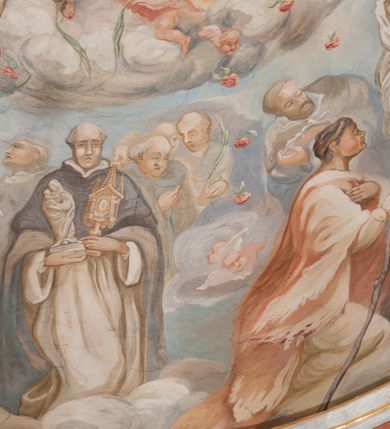 Zdjęcie nr 164: Iluzjonistyczną dekoracją malarską pokryto ściany kaplicy oraz strefę ponadcokołową: ściany tarczowe, pendentywy wokół stiukowych kartuszy herbowych oraz czaszę kopuły i wnętrze latarni. Ściany dolnej części podzielono na dwie strefy. Dolną tworzą zlokalizowane w narożach ścian iluzjonistycznie malowane pary nisz o konchach wypełnionych muszlą. W niszach ukazano osiem stojących frontalnie postaci starców, bez atrybutów i nimbów. Zapewne w ten sposób przedstawiono proroków lub apostołów. Każda z postaci ubrana jest w tunikę oraz płaszcz. Różnicuje je jedynie układ rąk, sposób kształtowania zarostu oraz kolorystyka szat. W drugiej strefie w przyłuczach arkad ukazano całopostaciowe przedstawienia uskrzydlonych aniołów trzymających narzędzia męki Pańskiej. Na ścianie wschodniej anioł prezentuje chustę Weroniki (z prawej) oraz latarnię (z lewej). Po bokach wejścia do kaplicy na ścianie północnej po prawej stronie anioł trzyma lancę i koronę cierniową, a po lewej krzyż. Z kolei na ścianie wschodniej po prawej ukazano anioła z drabiną, a po lewej z gąbką na trzcinie. Natomiast na ścianie południowej, po obu stronach zwieńczenia nagrobka, przedstawiono z prawej anioła z włócznią, a po lewej anioła z wiązką do biczowania. W tej strefie bezpośrednio przy łukach arkad wyobrażono leżące postacie geniuszy malowanych w technice en grisaille. Pod arkadą na ścianie wschodniej (ołtarzowej), ukazano dolną część owalnego jasno ugrowego baldachimu z lambrekinem i zielone, opadające paludamentum, rozsuwane kotarowo przez dwa uskrzydlone anioły. Dekoracja stanowi oprawę dla wiszącego tu obrazu Matki Boskiej z Dzieciątkiem w bogato rzeźbionej ramie. Z kolei na ścianie zachodniej wyobrażono monumentalną scenę Zdjęcia z krzyża. Jest to zwarta kompozycja ogniskująca się na wysokim drewnianym krzyżu, z którego ściągane jest martwe ciało Chrystusa. Z dwóch stron dłuższych ramion krzyż podtrzymują dwaj aniołowie. Ciało Jezusa opuszczane jest na białym pasie tkaniny przewiązanym pod jego ramionami. Chrystus ze zwisającą głową ma ręce ułożone wzdłuż ciała. Biodra przepasane ma białym perizonium. Jego skrzyżowane nogi są ugięte i jeszcze przybite gwoździem do krzyża. Gwóźdź wyciąga z nich obcęgami mężczyzna w niebieskiej, podwiniętej koszuli. Ciało opuszczają dwaj mężczyźni widoczni za poprzecznymi ramionami krzyża, trzymający końce taśmy. Człowiek z lewej strony w niebieskiej koszuli dodatkowo odbiera drugą białą taśmę od mężczyzny ubranego w szaroczarny strój. Osoba ta stoi na drabinie opartej o poprzeczne ramię krzyża. Drugi mężczyzna za krzyżem, w brązowej koszuli, lewą ręką trzyma koniec taśmy, a w uniesionej prawej młotek. Ciało Zbawiciela podtrzymuje lewą ręką kolejny mężczyzna stojący tyłem do widza na drugiej drabinie opartej o lewe ramię krzyża. Jest on ubrany w krótkie brązowe spodenki i bladozieloną koszulę. Pod krzyżem stoi zwarta siedmioosobowa grupa. Najprawdopodobniej z prawej strony ukazano św. Jana i Matkę Boską, na środku dwóch żołnierzy w ostro zakończonych hełmach, dwie kobiety, w tym zapewne Marię Magdalenę i starca widocznego z lewej strony kompozycji. Na ścianach tarczowych nad gzymsem wyobrażono po bokach okrągłych okien siedzących czterech ewangelistów i czterech ojców Kościoła. Na ścianie wschodniej znalazł się z prawej św. Jan z orłem, który w dziobie trzyma złoty kałamarz, a po lewej św. Mateusz rozmawiający z aniołem. Z kolei na ścianie południowej po lewej stronie przedstawiono św. Marka z lwem oraz św. Ambrożego trzymającego w prawej ręce naczynie z wylewającym się miodem. Na ścianie zachodniej z lewej znalazł się czytający św. Augustyn z sercem na dłoni, a z prawej św. Grzegorz Wielki z widoczną za nim tiarą i sową. Na ścianie północnej po lewej ukazano św. Hieronima z leżącym lwem, a po prawej stronie św. Łukasz z wołem. W pendentywach wykonano malarską dekorację w formie wijącej się wstęgi, na tle której widnieją stiukowe kartusze rollwerkowe, o owalnych kaboszonowych polach czwórdzielnych w krzyż. Po stronie wschodniej w pendentywach znajdują się dwa puste kartusze z niezachowanymi herbami. Natomiast herby zachowały się w pendentywach po stronie zachodniej. Na pendentywie północno-zachodnim: Jastrzębiec, Nowina, Gozdawa, Pobóg, a na południowo-zachodnim Gryf, Kotwicz, Kotwicz, Zabawa. W kopule wyobrażono Koronację Matki Boskiej adorowanej przez różnych świętych. Scenę koronacji Marii przez Trójcę Świętą przedstawiono w części wschodniej czaszy. Ukazana frontalnie Maria klęczy ze złożonymi rękami do modlitwy na obłokach. Ma owalną twarz okoloną jasnymi długimi włosami rozsypującymi się na jej ramiona. Na uniesionej ku górze głowie ma ubraną zsuwającą się białą chustę okrywającą włosy. Madonna ubrana jest w zasłaniający jej ramiona bladoniebieski płaszcz, opadający po bokach na obłoki. Nieznacznie wyżej z prawej strony na obłokach siedzi Bóg Ojciec. Wyobrażono go w trzech czwartych w prawo. Jest to starszy mężczyzna o siwych włosach i brodzie. W wyciągniętej prawej ręce nad głową Marii wraz z Chrystusem trzyma złotą koronę w typie zamkniętym. Z kolei w lewej podtrzymuje glob ze złotym krzyżykiem. Bóg Ojciec na głowie ma tiarę papieską. Ubrany jest w szaro-niebieską szatę oraz wzorzystą złotą kapę narzuconą na ramiona i spiętą pod szyją klamrą, z połami okrywającymi nogi. Naprzeciwko siedzi Chrystus widoczny w trzech czwartych w lewo z twarzą ukazaną w profilu. W wyciągniętej prawej ręce trzyma wraz z Bogiem Ojcem koronę, a lewą podtrzymuje złote berło. Chrystus ma jasne włosy opadające puklami na ramiona i podobną krótką brodę. Na głowie ma otwartą złotą koronę. Został przedstawiony z nagim torsem, na którym zaznaczono przebity bok. Jego postać otacza narzucony na ramiona bladoczerwony całun udrapowany w formie płaszcza. Nad koroną bliżej głowy Boga Ojca widoczna jest gołębica Ducha Świętego otoczona świetlistym otokiem. Ponad sceną koronacji wokół otworu do latarni wyobrażono wirujące złocisto-szare obłoki, na tle których widać uskrzydlone główki aniołków oraz postacie mniejszych i większych aniołków, które muzykują na różnych instrumentach, bądź też trzymają gałązki palmowe lub kwiaty albo kwiaty rozsypują. Uskrzydlone główki aniołków widoczne są także pośród obłoków, na których klęczy Madonna. Z prawej strony koronacji wyobrażono dwóch biskupów. Starszy, być może św. Wojciech, został przedstawiony w postawie półklęczącej w trzech czwartych w lewo. Prawą ręką zdaje się wskazywać na scenę koronacji, lewą zaś przyciska do piersi. Ma odkrytą głowę z widocznymi siwymi włosami i taką samą brodą. Ubrany jest w niebiesko-zielonkawą kapę ze złotym kapturem zakończonym chwostem. Na ziemi przy jego stopie widoczna jest złota infuła. Świętemu przyglądają się dwaj aniołowie widoczni z tyłu. Za nim klęczy młodszy biskup z leżącym przy nim na ziemi pastorałem i mieczem. Zapewne jest to św. Stanisław ze Szczepanowa. Święty ukazany został frontalnie z prawą ręką przyciśniętą do piersi, a z lewą nieznacznie odsuniętą w bok. Ma pociągłą twarz o krótkich jasnych włosach i podobnym zaroście. Ubrany jest w albę oraz szaro-bordową kapę o złotym kapturze. Przy jego kolanach stoi złota infuła, a za nim widoczny jest anioł z gałązką palmową. Za św. Stanisławem w rozwianych szatach klęczy św. Jadwiga Śląska, którą identyfikuje bryła kościoła widoczna przy jej stopach. Postać Jadwigi ukazano w profilu z założonymi rękami przed sobą. Na głowie ma niewielką złotą koronę, spod której widoczna jest biała chusta okrywająca włosy. Ubrana jest w bladoczerwoną suknię przepasaną w talii i narzucony na ramiona bladoszkarłatny płaszcz z gronostajowym kołnierzem i obszyciem. Za św. Jadwigą stoi inna święta z odsłoniętą lewą ręką wspartą o bok. Brak atrybutu nie pozwala na jej identyfikację. Ukazano ją w trzech czwartych w prawo z głową w profilu. Ma owalną twarz z wydatnym nosem. Na głowie ma niewielką złotą koronę, spod której widać jasną chustę okrywającą włosy. Ubrana jest w złocisto-szarą suknię z krótkimi rękawami i bladoczerwony rozwiany płaszcz. Pomiędzy obiema kobietami widać dwie postacie uskrzydlonych aniołów. Za świętymi siedzi z otwartą księgą wyobrażony frontalnie św. Jana Kanty. Jest to mężczyzna w średnim wieku z wysokim czołem, krótkimi brązowymi włosami i podobną brodą. Ubrany jest w bladofioletową togę akademicką z gronostajową peleryną. Trzymana przez niego księga ma czerwone okładki. Obok św. Jana Kantego namalowano czteroosobową grupę starszych mężczyzn. Pierwszy z nich, ujętych w trzech czwartych w prawo, zdaje się przyklękając, odbierać prawą ręką palmę męczeństwa podawaną mu przez widocznego nad nim anioła. Lewą ma ułożoną wzdłuż ciała. Ma podłużną twarz widoczną z profilu, otoczoną białymi włosami i spiczastą białą brodą. Ubrany jest w rozwianą jasnobeżową szatę przewiązaną w pasie i taki sam płaszcz narzucony na prawe ramię. Lewy rękaw tuniki jest podciągnięty, odsłaniając przedramię ręki. Na lewej nodze widoczny jest sandał. Za nim przedstawiono klęczącego w ujęciu trzech czwartych w lewo zakonnika eremitę, być może św. Pawła Pustelnika w białym habicie paulińskim. Zakonnik na wysokości bioder ma rozsunięte ręce. Jego twarz o wydatnym nosie otacza krzaczasta, długa, biała broda oraz białe włosy. W głębi za nim częściowo widać dwóch innych brodatych mężczyzn w beżowych szatach. Jeden z nich trzyma w dłoni palmę. W niewielkiej odległości za grupą mężczyzn na pierwszym planie klęczy na obłoku ukazany frontalnie św. Jacek. W rękach uniesionych na wysokości piersi trzyma wieżycową, złotą monstrancję i figurę Matki Boskiej. Dominikanin został przedstawiony z wysokim łysym czołem i wianuszkiem siwiejących włosów. Jego pociągła twarz o wyrazistym nosie i wąskich, nieznacznie zaciśniętych ustach pozbawiona jest zarostu. Ubrany jest w dominikański habit z czarnoniebieskim płaszczem. Z lewej strony sceny koronacji namalowano grupę czterech świętych. Na pierwszym planie widać klęczącego św. Stanisława Kostkę, wspartego na długim kiju z przywiązanym do niego węzełkiem. Święty został przedstawiony w profilu. Ma młodzieńczą, owalną twarz z krótkimi brązowymi włosami i rumianymi policzkami. Ubrany jest w bladobeżowy płaszcz, spod którego widać jasnoseledynową szatę. Za Stanisławem Kostką wyłania się w półpostaci św. Jan Nepomucen z drewnianym krzyżem podtrzymywanym lewą ręką. Jest to dojrzały mężczyzna o pociągłej twarzy, z brązowymi włosami i brodą. Z prawej strony św. Stanisława Kostki ukazano stojące dwie zakonnice, św. Kingę i zapewne bł. Salomeę. Kingę ukazano frontalnie w kontrapoście z głową uniesioną ku niebu w jasnobeżowym habicie klaryski wpadającym w brąz. Księżna prawą ręką przyciska do piersi bryłę soli, a w opuszczonej lewej trzyma kwiat lilii. U jej stóp widać model kościoła klasztornego w Starym Sączu. Obok stoi najprawdopodobniej bł. Salomea. Ukazano ją w mocnym kontrapoście, z dłońmi splecionymi na piersi i spojrzeniem skierowanym ku ziemi. Ubrana jest w rozwiany szaroniebieski habit i jasny welon. Wnętrze latarni wypełniają uskrzydlone głowy aniołków na tle złocisto-szarych obłoków.    







