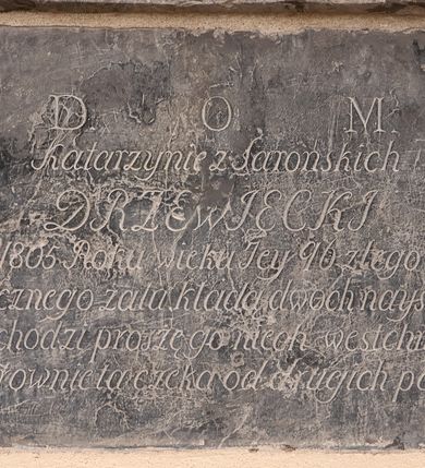 Zdjęcie nr 1: Płyta o formie leżącego prostokąta. W polu inskrypcja
„D(eo) O(ptimo) M(aximo) / Katarzynie z Sarońskich / DRZEWIECKI / dnia 2 Grudnia 1805 Roku wieku Iey 96 z tego Światu zeszła / Świadectwo wiecznego żalu kładą dwoch naystarszych Wnuko / kto przechodzi proszę go niech westchnie do Nieba / Bo go rownie ta czeka od drugich potrzeba”.