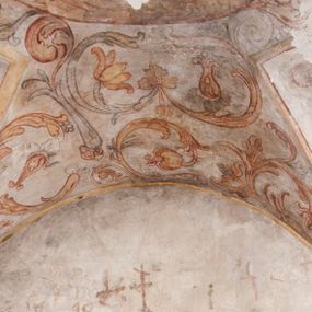 Zdjęcie nr 1: Polichromia pokrywa ściany i sklepienie kolebkowe z lunetami czworobocznej, dwuprzęsłowej zakrystii. Pole sklepienia wypełnia dekoracja ornamentalna utworzona ze zawijanych liści akantu, stylizowanych kwiatów oraz wazonów z kwiatami. Pośrodku sklepienia umieszczono w owalu w kartuszu fragmentarycznie zachowaną scenę Koronacji Marii. W centrum kompozycji zachowała się głowa Marii ujęta w trzy czwarte w prawo z widocznym fragmentem prawego ramienia i ułożonej do modlitwy prawej ręki. Po prawej stronie widać postać tronującego Boga Ojca w złotej koronie, z brodą, trzymającego złotą koronę nad głową Marii. Z lewej można dostrzec fragment ręki Chrystusa oraz fragment jego czerwonej szaty i lewej stopy. Na ścianie wschodniej dekorację malarską w postaci wici utworzonej ze stylizowanych liści akantu i kwiatów poprowadzono w glifie okiennym. Wokół okna utworzono malowane obramienie z motywami stylizowanego ornamentu rollwerkowego. Ponad oknem w glifie znajduje się malowany chrystogram "IHS". Po prawej stronie okna widoczne jest całopostaciowe przedstawienie proroka Eliasza z rozłożonymi rękami. Postać została ujęta w trzech czwartych w prawo. Ma pociągłą twarz okoloną zarostem z wydatnym nosem i ustami. Ubrana jest w strój wschodni - długą szatę z bladoczerwonym płaszczem z kołnierzykiem spiętym przy szyi oraz z rozciętymi rękawami. Na głowie ma szaroniebieski turban. Ponad nim widać lecącego kruka. Obok mężczyzny z prawej strony widoczna jest niewielka sekwencja krajobrazowa z motywem drzewa. Eliasz zwrócony jest w stronę sceny z Ostatnią Wieczerzą wykonaną w pierwszym przęśle ściany południowej zakrystii. Ostatnią Wieczerzę z prawej strony zamyka malowana kolumna z kapitelem rozdzielająca ścianę na dwa przęsła. Na tle altany ze schodami po lewej, flankowanej trzema kolumnami na wysokich cokołach, ukazano Chrystusa i dwunastu apostołów siedzący przy okrągłym, okazałym stole. Ponad stołem wisi płonącą lampa. Stół nakryto białym obrusem zastawionym siedmioma talerzami, owalną misą pośrodku, trzema okrągłymi bochenkami chleba, dwoma nożami i kielichem. Siedzący centralnie za stołem Chrystus został ukazany frontalnie. Zbawiciel ma zmęczoną twarz otoczoną brodą i długimi włosami, spływającymi na ramiona. Ubrany jest w białą tunikę i niebieski płaszcz przerzucony przez lewe ramię. O jego pierś opiera się zamyślony św. Jan, wspierający głowę na prawej ręce trzymanej na stole. Lewą rękę położoną na blacie ma zgiętą w łokciu. Wokół stołu siedzą rozmawiający ze sobą pozostali apostołowie. Są to starsi, brodaci mężczyźni, niektórzy z nich są łysi. Ubrani są w tuniki i narzucone na ramionach płaszcze. Można spośród nich wyróżnić siedzącego po prawe strony Chrystusa św. Piotra oraz Judasza widocznego jako pierwszego po lewej stronie kompozycji. Judasza ukazanego frontalnie identyfikuje żółta szata oraz trzymany w prawej ręce mieszek ze srebnikami. Powyżej w podłuczu lunety namalowano siedzącego, starszego brodatego mężczyznę ujętego w trzech czwartych w prawo. Jest to ewangelista widoczny do kolan. Prawą rękę przyciska do piersi lewą zaś opiera o stół ustawiony z prawej strony kompozycji z ułożoną na nim księgą. Jego twarz charakteryzuje wydatny nos i usta oraz spojrzenie skierowane na widza. W drugim przęśle ściany  
południowej dekoracje tworzy stylizowana wić akantowo-kwiatowa w glifie okiennym oraz otaczające okno obramienie utworzone z motywów rollwerkowych. Nie zachowała się polichromia w lunecie powyżej okna. Na zachodniej ścianie w glifie dawnego otworu wejściowego obramionego żółtą listwą, wykonano dekorację malarską składającą się z malowanych romboidalnych płycin pokrytych czerwonawą marmoryzacją. Ponad glifem na ścianie znajduje się czerwony krzyż równoramienny rozdzielający datę 16 / 46. Na ścianie z prawej strony otworu wyobrażono Ukrzyżowanie Chrystusa na polu pokrytym licznymi, stojącymi krzyżami. Postać Zbawiciela zachowała się fragmentarycznie w partii tułowia i nóg. Powyżej pole w lunecie ozdobiono stylizowaną wicią akantowo-kwiatową. Ścianę północną w pierwszym przęśle wypełnionym szafą zakrystyjną udekorowano rozpostartym, czerwonym paludamentum z baldachimem. Powyżej w lunecie zachowało się bardzo zniszczone przedstawienie św. Jana Ewangelisty, którego można rozpoznać po młodzieńczej, pociągłej twarz o wydatnych rysach. Z postaci zachowały się jeszcze  fragmenty stóp widoczne nad baldachimem. W drugim prześle w dolnej strefie przepruto drzwi z otworem zamkniętym łukiem odcinkowym, obramienionym złocistą taśmą. W nadprożu znalazła się stylizowana wić akantowo-kwiatowa. Powyżej, w górnej strefie namalowano modlitwę Chrystusa w Ogrójcu. Na pierwszym planie kompozycji widoczny jest klęczący na ziemi Zbawiciel ujęty w trzech czwartych w prawo. Lewą rękę ma przyłożoną do piersi, drugą zaś odsuniętą od tułowia. Jego uniesioną głowę ku górze otacza ciemna broda i długie włosy spływające na plecy. Chrystus ma wydatny nos i usta. Ubrany jest w obszerną, jasnooliwkową tunikę przewiązaną w pasie oraz niebieskoszary płaszcz przerzucony przez lewe ramię i rękę. Jezus wpatruje się w zjawiającego mu się powyżej uskrzydlonego anioła ukazanego w dwóch trzecich na obłokach. Anioł w wyciągniętej prawej ręce trzyma złoty kielich, a prawą podtrzymuje opary o ramię krzyż. Ubrany jest w baldoczerwoną tunikę przewiązaną w pasie. Z prawej strony Jezusa widocznych jest trzech śpiących apostołów. Na pierwszym planie ukazano leżącego św. Piotra z głową wspartą na lewej ręce. Jest to starszy mężczyzna z łysym czołem i siwiejącymi włosami i brodą. Ubrany jest w bladoniebieską tunikę i ciemnoochrowy płaszcz. Za nim widać siedzącego św. Jana z głową wspartą na ręce, którą podpiera o prawe kolano. Jest to młodzieniec o długich włosach, ubrany w blado oliwkową tunikę i baldoczerwony płaszcz. O niewielki wzgórek z lewej strony Jana oparty jest św. Jakub. Jest to starszy mężczyzna z brązową brodą i włosami ubrany w bladooliwkowy płaszcz. Za Zbawicielem z lewej strony kompozycji widać drewniany płot z bramką, przez którą do ogrodu wchodzi Judasz w jasno-chórowej szacie, prowadzący zbrojny oddział sług świątynnych. W głębi kompozycji ukazano panoramę Jerozolimy. Powyżej na sklepieniu lunety wyobrażono siedzącego ewangelistę, który ukazany został jako starzec z długą siwą brodą i łysiejącym czołem. Mężczyzna wspierając prawą rękę o stół podpiera nią głowę. Lewą ma położoną na kolanie. Ubrany jest w szarą tunikę oraz bladoczerwony płaszcz przerzucony przez prawe ramię i okrywający kolana.    
