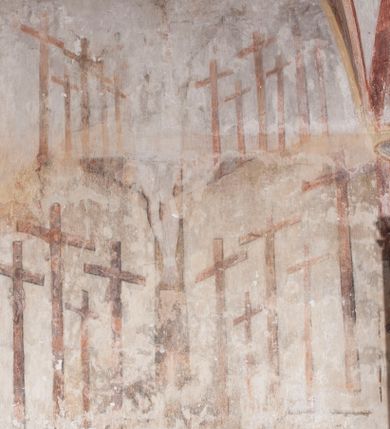 Zdjęcie nr 6: Polichromia pokrywa ściany i sklepienie kolebkowe z lunetami czworobocznej, dwuprzęsłowej zakrystii. Pole sklepienia wypełnia dekoracja ornamentalna utworzona ze zawijanych liści akantu, stylizowanych kwiatów oraz wazonów z kwiatami. Pośrodku sklepienia umieszczono w owalu w kartuszu fragmentarycznie zachowaną scenę Koronacji Marii. W centrum kompozycji zachowała się głowa Marii ujęta w trzy czwarte w prawo z widocznym fragmentem prawego ramienia i ułożonej do modlitwy prawej ręki. Po prawej stronie widać postać tronującego Boga Ojca w złotej koronie, z brodą, trzymającego złotą koronę nad głową Marii. Z lewej można dostrzec fragment ręki Chrystusa oraz fragment jego czerwonej szaty i lewej stopy. Na ścianie wschodniej dekorację malarską w postaci wici utworzonej ze stylizowanych liści akantu i kwiatów poprowadzono w glifie okiennym. Wokół okna utworzono malowane obramienie z motywami stylizowanego ornamentu rollwerkowego. Ponad oknem w glifie znajduje się malowany chrystogram "IHS". Po prawej stronie okna widoczne jest całopostaciowe przedstawienie proroka Eliasza z rozłożonymi rękami. Postać została ujęta w trzech czwartych w prawo. Ma pociągłą twarz okoloną zarostem z wydatnym nosem i ustami. Ubrana jest w strój wschodni - długą szatę z bladoczerwonym płaszczem z kołnierzykiem spiętym przy szyi oraz z rozciętymi rękawami. Na głowie ma szaroniebieski turban. Ponad nim widać lecącego kruka. Obok mężczyzny z prawej strony widoczna jest niewielka sekwencja krajobrazowa z motywem drzewa. Eliasz zwrócony jest w stronę sceny z Ostatnią Wieczerzą wykonaną w pierwszym przęśle ściany południowej zakrystii. Ostatnią Wieczerzę z prawej strony zamyka malowana kolumna z kapitelem rozdzielająca ścianę na dwa przęsła. Na tle altany ze schodami po lewej, flankowanej trzema kolumnami na wysokich cokołach, ukazano Chrystusa i dwunastu apostołów siedzący przy okrągłym, okazałym stole. Ponad stołem wisi płonącą lampa. Stół nakryto białym obrusem zastawionym siedmioma talerzami, owalną misą pośrodku, trzema okrągłymi bochenkami chleba, dwoma nożami i kielichem. Siedzący centralnie za stołem Chrystus został ukazany frontalnie. Zbawiciel ma zmęczoną twarz otoczoną brodą i długimi włosami, spływającymi na ramiona. Ubrany jest w białą tunikę i niebieski płaszcz przerzucony przez lewe ramię. O jego pierś opiera się zamyślony św. Jan, wspierający głowę na prawej ręce trzymanej na stole. Lewą rękę położoną na blacie ma zgiętą w łokciu. Wokół stołu siedzą rozmawiający ze sobą pozostali apostołowie. Są to starsi, brodaci mężczyźni, niektórzy z nich są łysi. Ubrani są w tuniki i narzucone na ramionach płaszcze. Można spośród nich wyróżnić siedzącego po prawe strony Chrystusa św. Piotra oraz Judasza widocznego jako pierwszego po lewej stronie kompozycji. Judasza ukazanego frontalnie identyfikuje żółta szata oraz trzymany w prawej ręce mieszek ze srebnikami. Powyżej w podłuczu lunety namalowano siedzącego, starszego brodatego mężczyznę ujętego w trzech czwartych w prawo. Jest to ewangelista widoczny do kolan. Prawą rękę przyciska do piersi lewą zaś opiera o stół ustawiony z prawej strony kompozycji z ułożoną na nim księgą. Jego twarz charakteryzuje wydatny nos i usta oraz spojrzenie skierowane na widza. W drugim przęśle ściany  
południowej dekoracje tworzy stylizowana wić akantowo-kwiatowa w glifie okiennym oraz otaczające okno obramienie utworzone z motywów rollwerkowych. Nie zachowała się polichromia w lunecie powyżej okna. Na zachodniej ścianie w glifie dawnego otworu wejściowego obramionego żółtą listwą, wykonano dekorację malarską składającą się z malowanych romboidalnych płycin pokrytych czerwonawą marmoryzacją. Ponad glifem na ścianie znajduje się czerwony krzyż równoramienny rozdzielający datę 16 / 46. Na ścianie z prawej strony otworu wyobrażono Ukrzyżowanie Chrystusa na polu pokrytym licznymi, stojącymi krzyżami. Postać Zbawiciela zachowała się fragmentarycznie w partii tułowia i nóg. Powyżej pole w lunecie ozdobiono stylizowaną wicią akantowo-kwiatową. Ścianę północną w pierwszym przęśle wypełnionym szafą zakrystyjną udekorowano rozpostartym, czerwonym paludamentum z baldachimem. Powyżej w lunecie zachowało się bardzo zniszczone przedstawienie św. Jana Ewangelisty, którego można rozpoznać po młodzieńczej, pociągłej twarz o wydatnych rysach. Z postaci zachowały się jeszcze  fragmenty stóp widoczne nad baldachimem. W drugim prześle w dolnej strefie przepruto drzwi z otworem zamkniętym łukiem odcinkowym, obramienionym złocistą taśmą. W nadprożu znalazła się stylizowana wić akantowo-kwiatowa. Powyżej, w górnej strefie namalowano modlitwę Chrystusa w Ogrójcu. Na pierwszym planie kompozycji widoczny jest klęczący na ziemi Zbawiciel ujęty w trzech czwartych w prawo. Lewą rękę ma przyłożoną do piersi, drugą zaś odsuniętą od tułowia. Jego uniesioną głowę ku górze otacza ciemna broda i długie włosy spływające na plecy. Chrystus ma wydatny nos i usta. Ubrany jest w obszerną, jasnooliwkową tunikę przewiązaną w pasie oraz niebieskoszary płaszcz przerzucony przez lewe ramię i rękę. Jezus wpatruje się w zjawiającego mu się powyżej uskrzydlonego anioła ukazanego w dwóch trzecich na obłokach. Anioł w wyciągniętej prawej ręce trzyma złoty kielich, a prawą podtrzymuje opary o ramię krzyż. Ubrany jest w baldoczerwoną tunikę przewiązaną w pasie. Z prawej strony Jezusa widocznych jest trzech śpiących apostołów. Na pierwszym planie ukazano leżącego św. Piotra z głową wspartą na lewej ręce. Jest to starszy mężczyzna z łysym czołem i siwiejącymi włosami i brodą. Ubrany jest w bladoniebieską tunikę i ciemnoochrowy płaszcz. Za nim widać siedzącego św. Jana z głową wspartą na ręce, którą podpiera o prawe kolano. Jest to młodzieniec o długich włosach, ubrany w blado oliwkową tunikę i baldoczerwony płaszcz. O niewielki wzgórek z lewej strony Jana oparty jest św. Jakub. Jest to starszy mężczyzna z brązową brodą i włosami ubrany w bladooliwkowy płaszcz. Za Zbawicielem z lewej strony kompozycji widać drewniany płot z bramką, przez którą do ogrodu wchodzi Judasz w jasno-chórowej szacie, prowadzący zbrojny oddział sług świątynnych. W głębi kompozycji ukazano panoramę Jerozolimy. Powyżej na sklepieniu lunety wyobrażono siedzącego ewangelistę, który ukazany został jako starzec z długą siwą brodą i łysiejącym czołem. Mężczyzna wspierając prawą rękę o stół podpiera nią głowę. Lewą ma położoną na kolanie. Ubrany jest w szarą tunikę oraz bladoczerwony płaszcz przerzucony przez prawe ramię i okrywający kolana.    
