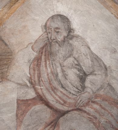 Zdjęcie nr 17: Polichromia pokrywa ściany i sklepienie kolebkowe z lunetami czworobocznej, dwuprzęsłowej zakrystii. Pole sklepienia wypełnia dekoracja ornamentalna utworzona ze zawijanych liści akantu, stylizowanych kwiatów oraz wazonów z kwiatami. Pośrodku sklepienia umieszczono w owalu w kartuszu fragmentarycznie zachowaną scenę Koronacji Marii. W centrum kompozycji zachowała się głowa Marii ujęta w trzy czwarte w prawo z widocznym fragmentem prawego ramienia i ułożonej do modlitwy prawej ręki. Po prawej stronie widać postać tronującego Boga Ojca w złotej koronie, z brodą, trzymającego złotą koronę nad głową Marii. Z lewej można dostrzec fragment ręki Chrystusa oraz fragment jego czerwonej szaty i lewej stopy. Na ścianie wschodniej dekorację malarską w postaci wici utworzonej ze stylizowanych liści akantu i kwiatów poprowadzono w glifie okiennym. Wokół okna utworzono malowane obramienie z motywami stylizowanego ornamentu rollwerkowego. Ponad oknem w glifie znajduje się malowany chrystogram &quot;IHS&quot;. Po prawej stronie okna widoczne jest całopostaciowe przedstawienie proroka Eliasza z rozłożonymi rękami. Postać została ujęta w trzech czwartych w prawo. Ma pociągłą twarz okoloną zarostem z wydatnym nosem i ustami. Ubrana jest w strój wschodni - długą szatę z bladoczerwonym płaszczem z kołnierzykiem spiętym przy szyi oraz z rozciętymi rękawami. Na głowie ma szaroniebieski turban. Ponad nim widać lecącego kruka. Obok mężczyzny z prawej strony widoczna jest niewielka sekwencja krajobrazowa z motywem drzewa. Eliasz zwrócony jest w stronę sceny z Ostatnią Wieczerzą wykonaną w pierwszym przęśle ściany południowej zakrystii. Ostatnią Wieczerzę z prawej strony zamyka malowana kolumna z kapitelem rozdzielająca ścianę na dwa przęsła. Na tle altany ze schodami po lewej, flankowanej trzema kolumnami na wysokich cokołach, ukazano Chrystusa i dwunastu apostołów siedzący przy okrągłym, okazałym stole. Ponad stołem wisi płonącą lampa. Stół nakryto białym obrusem zastawionym siedmioma talerzami, owalną misą pośrodku, trzema okrągłymi bochenkami chleba, dwoma nożami i kielichem. Siedzący centralnie za stołem Chrystus został ukazany frontalnie. Zbawiciel ma zmęczoną twarz otoczoną brodą i długimi włosami, spływającymi na ramiona. Ubrany jest w białą tunikę i niebieski płaszcz przerzucony przez lewe ramię. O jego pierś opiera się zamyślony św. Jan, wspierający głowę na prawej ręce trzymanej na stole. Lewą rękę położoną na blacie ma zgiętą w łokciu. Wokół stołu siedzą rozmawiający ze sobą pozostali apostołowie. Są to starsi, brodaci mężczyźni, niektórzy z nich są łysi. Ubrani są w tuniki i narzucone na ramionach płaszcze. Można spośród nich wyróżnić siedzącego po prawe strony Chrystusa św. Piotra oraz Judasza widocznego jako pierwszego po lewej stronie kompozycji. Judasza ukazanego frontalnie identyfikuje żółta szata oraz trzymany w prawej ręce mieszek ze srebnikami. Powyżej w podłuczu lunety namalowano siedzącego, starszego brodatego mężczyznę ujętego w trzech czwartych w prawo. Jest to ewangelista widoczny do kolan. Prawą rękę przyciska do piersi lewą zaś opiera o stół ustawiony z prawej strony kompozycji z ułożoną na nim księgą. Jego twarz charakteryzuje wydatny nos i usta oraz spojrzenie skierowane na widza. W drugim przęśle ściany  
południowej dekoracje tworzy stylizowana wić akantowo-kwiatowa w glifie okiennym oraz otaczające okno obramienie utworzone z motywów rollwerkowych. Nie zachowała się polichromia w lunecie powyżej okna. Na zachodniej ścianie w glifie dawnego otworu wejściowego obramionego żółtą listwą, wykonano dekorację malarską składającą się z malowanych romboidalnych płycin pokrytych czerwonawą marmoryzacją. Ponad glifem na ścianie znajduje się czerwony krzyż równoramienny rozdzielający datę 16 / 46. Na ścianie z prawej strony otworu wyobrażono Ukrzyżowanie Chrystusa na polu pokrytym licznymi, stojącymi krzyżami. Postać Zbawiciela zachowała się fragmentarycznie w partii tułowia i nóg. Powyżej pole w lunecie ozdobiono stylizowaną wicią akantowo-kwiatową. Ścianę północną w pierwszym przęśle wypełnionym szafą zakrystyjną udekorowano rozpostartym, czerwonym paludamentum z baldachimem. Powyżej w lunecie zachowało się bardzo zniszczone przedstawienie św. Jana Ewangelisty, którego można rozpoznać po młodzieńczej, pociągłej twarz o wydatnych rysach. Z postaci zachowały się jeszcze  fragmenty stóp widoczne nad baldachimem. W drugim prześle w dolnej strefie przepruto drzwi z otworem zamkniętym łukiem odcinkowym, obramienionym złocistą taśmą. W nadprożu znalazła się stylizowana wić akantowo-kwiatowa. Powyżej, w górnej strefie namalowano modlitwę Chrystusa w Ogrójcu. Na pierwszym planie kompozycji widoczny jest klęczący na ziemi Zbawiciel ujęty w trzech czwartych w prawo. Lewą rękę ma przyłożoną do piersi, drugą zaś odsuniętą od tułowia. Jego uniesioną głowę ku górze otacza ciemna broda i długie włosy spływające na plecy. Chrystus ma wydatny nos i usta. Ubrany jest w obszerną, jasnooliwkową tunikę przewiązaną w pasie oraz niebieskoszary płaszcz przerzucony przez lewe ramię i rękę. Jezus wpatruje się w zjawiającego mu się powyżej uskrzydlonego anioła ukazanego w dwóch trzecich na obłokach. Anioł w wyciągniętej prawej ręce trzyma złoty kielich, a prawą podtrzymuje opary o ramię krzyż. Ubrany jest w baldoczerwoną tunikę przewiązaną w pasie. Z prawej strony Jezusa widocznych jest trzech śpiących apostołów. Na pierwszym planie ukazano leżącego św. Piotra z głową wspartą na lewej ręce. Jest to starszy mężczyzna z łysym czołem i siwiejącymi włosami i brodą. Ubrany jest w bladoniebieską tunikę i ciemnoochrowy płaszcz. Za nim widać siedzącego św. Jana z głową wspartą na ręce, którą podpiera o prawe kolano. Jest to młodzieniec o długich włosach, ubrany w blado oliwkową tunikę i baldoczerwony płaszcz. O niewielki wzgórek z lewej strony Jana oparty jest św. Jakub. Jest to starszy mężczyzna z brązową brodą i włosami ubrany w bladooliwkowy płaszcz. Za Zbawicielem z lewej strony kompozycji widać drewniany płot z bramką, przez którą do ogrodu wchodzi Judasz w jasno-chórowej szacie, prowadzący zbrojny oddział sług świątynnych. W głębi kompozycji ukazano panoramę Jerozolimy. Powyżej na sklepieniu lunety wyobrażono siedzącego ewangelistę, który ukazany został jako starzec z długą siwą brodą i łysiejącym czołem. Mężczyzna wspierając prawą rękę o stół podpiera nią głowę. Lewą ma położoną na kolanie. Ubrany jest w szarą tunikę oraz bladoczerwony płaszcz przerzucony przez prawe ramię i okrywający kolana.    
