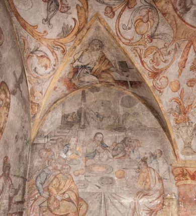 Zdjęcie nr 31: Polichromia pokrywa ściany i sklepienie kolebkowe z lunetami czworobocznej, dwuprzęsłowej zakrystii. Pole sklepienia wypełnia dekoracja ornamentalna utworzona ze zawijanych liści akantu, stylizowanych kwiatów oraz wazonów z kwiatami. Pośrodku sklepienia umieszczono w owalu w kartuszu fragmentarycznie zachowaną scenę Koronacji Marii. W centrum kompozycji zachowała się głowa Marii ujęta w trzy czwarte w prawo z widocznym fragmentem prawego ramienia i ułożonej do modlitwy prawej ręki. Po prawej stronie widać postać tronującego Boga Ojca w złotej koronie, z brodą, trzymającego złotą koronę nad głową Marii. Z lewej można dostrzec fragment ręki Chrystusa oraz fragment jego czerwonej szaty i lewej stopy. Na ścianie wschodniej dekorację malarską w postaci wici utworzonej ze stylizowanych liści akantu i kwiatów poprowadzono w glifie okiennym. Wokół okna utworzono malowane obramienie z motywami stylizowanego ornamentu rollwerkowego. Ponad oknem w glifie znajduje się malowany chrystogram "IHS". Po prawej stronie okna widoczne jest całopostaciowe przedstawienie proroka Eliasza z rozłożonymi rękami. Postać została ujęta w trzech czwartych w prawo. Ma pociągłą twarz okoloną zarostem z wydatnym nosem i ustami. Ubrana jest w strój wschodni - długą szatę z bladoczerwonym płaszczem z kołnierzykiem spiętym przy szyi oraz z rozciętymi rękawami. Na głowie ma szaroniebieski turban. Ponad nim widać lecącego kruka. Obok mężczyzny z prawej strony widoczna jest niewielka sekwencja krajobrazowa z motywem drzewa. Eliasz zwrócony jest w stronę sceny z Ostatnią Wieczerzą wykonaną w pierwszym przęśle ściany południowej zakrystii. Ostatnią Wieczerzę z prawej strony zamyka malowana kolumna z kapitelem rozdzielająca ścianę na dwa przęsła. Na tle altany ze schodami po lewej, flankowanej trzema kolumnami na wysokich cokołach, ukazano Chrystusa i dwunastu apostołów siedzący przy okrągłym, okazałym stole. Ponad stołem wisi płonącą lampa. Stół nakryto białym obrusem zastawionym siedmioma talerzami, owalną misą pośrodku, trzema okrągłymi bochenkami chleba, dwoma nożami i kielichem. Siedzący centralnie za stołem Chrystus został ukazany frontalnie. Zbawiciel ma zmęczoną twarz otoczoną brodą i długimi włosami, spływającymi na ramiona. Ubrany jest w białą tunikę i niebieski płaszcz przerzucony przez lewe ramię. O jego pierś opiera się zamyślony św. Jan, wspierający głowę na prawej ręce trzymanej na stole. Lewą rękę położoną na blacie ma zgiętą w łokciu. Wokół stołu siedzą rozmawiający ze sobą pozostali apostołowie. Są to starsi, brodaci mężczyźni, niektórzy z nich są łysi. Ubrani są w tuniki i narzucone na ramionach płaszcze. Można spośród nich wyróżnić siedzącego po prawe strony Chrystusa św. Piotra oraz Judasza widocznego jako pierwszego po lewej stronie kompozycji. Judasza ukazanego frontalnie identyfikuje żółta szata oraz trzymany w prawej ręce mieszek ze srebnikami. Powyżej w podłuczu lunety namalowano siedzącego, starszego brodatego mężczyznę ujętego w trzech czwartych w prawo. Jest to ewangelista widoczny do kolan. Prawą rękę przyciska do piersi lewą zaś opiera o stół ustawiony z prawej strony kompozycji z ułożoną na nim księgą. Jego twarz charakteryzuje wydatny nos i usta oraz spojrzenie skierowane na widza. W drugim przęśle ściany  
południowej dekoracje tworzy stylizowana wić akantowo-kwiatowa w glifie okiennym oraz otaczające okno obramienie utworzone z motywów rollwerkowych. Nie zachowała się polichromia w lunecie powyżej okna. Na zachodniej ścianie w glifie dawnego otworu wejściowego obramionego żółtą listwą, wykonano dekorację malarską składającą się z malowanych romboidalnych płycin pokrytych czerwonawą marmoryzacją. Ponad glifem na ścianie znajduje się czerwony krzyż równoramienny rozdzielający datę 16 / 46. Na ścianie z prawej strony otworu wyobrażono Ukrzyżowanie Chrystusa na polu pokrytym licznymi, stojącymi krzyżami. Postać Zbawiciela zachowała się fragmentarycznie w partii tułowia i nóg. Powyżej pole w lunecie ozdobiono stylizowaną wicią akantowo-kwiatową. Ścianę północną w pierwszym przęśle wypełnionym szafą zakrystyjną udekorowano rozpostartym, czerwonym paludamentum z baldachimem. Powyżej w lunecie zachowało się bardzo zniszczone przedstawienie św. Jana Ewangelisty, którego można rozpoznać po młodzieńczej, pociągłej twarz o wydatnych rysach. Z postaci zachowały się jeszcze  fragmenty stóp widoczne nad baldachimem. W drugim prześle w dolnej strefie przepruto drzwi z otworem zamkniętym łukiem odcinkowym, obramienionym złocistą taśmą. W nadprożu znalazła się stylizowana wić akantowo-kwiatowa. Powyżej, w górnej strefie namalowano modlitwę Chrystusa w Ogrójcu. Na pierwszym planie kompozycji widoczny jest klęczący na ziemi Zbawiciel ujęty w trzech czwartych w prawo. Lewą rękę ma przyłożoną do piersi, drugą zaś odsuniętą od tułowia. Jego uniesioną głowę ku górze otacza ciemna broda i długie włosy spływające na plecy. Chrystus ma wydatny nos i usta. Ubrany jest w obszerną, jasnooliwkową tunikę przewiązaną w pasie oraz niebieskoszary płaszcz przerzucony przez lewe ramię i rękę. Jezus wpatruje się w zjawiającego mu się powyżej uskrzydlonego anioła ukazanego w dwóch trzecich na obłokach. Anioł w wyciągniętej prawej ręce trzyma złoty kielich, a prawą podtrzymuje opary o ramię krzyż. Ubrany jest w baldoczerwoną tunikę przewiązaną w pasie. Z prawej strony Jezusa widocznych jest trzech śpiących apostołów. Na pierwszym planie ukazano leżącego św. Piotra z głową wspartą na lewej ręce. Jest to starszy mężczyzna z łysym czołem i siwiejącymi włosami i brodą. Ubrany jest w bladoniebieską tunikę i ciemnoochrowy płaszcz. Za nim widać siedzącego św. Jana z głową wspartą na ręce, którą podpiera o prawe kolano. Jest to młodzieniec o długich włosach, ubrany w blado oliwkową tunikę i baldoczerwony płaszcz. O niewielki wzgórek z lewej strony Jana oparty jest św. Jakub. Jest to starszy mężczyzna z brązową brodą i włosami ubrany w bladooliwkowy płaszcz. Za Zbawicielem z lewej strony kompozycji widać drewniany płot z bramką, przez którą do ogrodu wchodzi Judasz w jasno-chórowej szacie, prowadzący zbrojny oddział sług świątynnych. W głębi kompozycji ukazano panoramę Jerozolimy. Powyżej na sklepieniu lunety wyobrażono siedzącego ewangelistę, który ukazany został jako starzec z długą siwą brodą i łysiejącym czołem. Mężczyzna wspierając prawą rękę o stół podpiera nią głowę. Lewą ma położoną na kolanie. Ubrany jest w szarą tunikę oraz bladoczerwony płaszcz przerzucony przez prawe ramię i okrywający kolana.    
