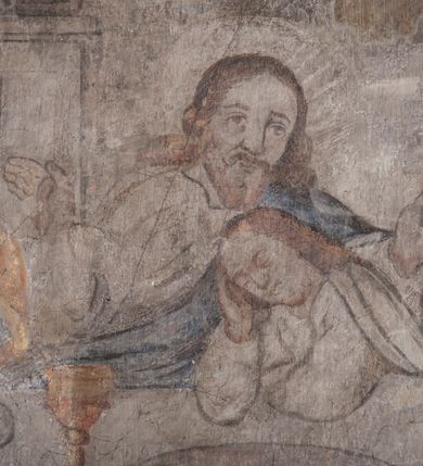 Zdjęcie nr 33: Polichromia pokrywa ściany i sklepienie kolebkowe z lunetami czworobocznej, dwuprzęsłowej zakrystii. Pole sklepienia wypełnia dekoracja ornamentalna utworzona ze zawijanych liści akantu, stylizowanych kwiatów oraz wazonów z kwiatami. Pośrodku sklepienia umieszczono w owalu w kartuszu fragmentarycznie zachowaną scenę Koronacji Marii. W centrum kompozycji zachowała się głowa Marii ujęta w trzy czwarte w prawo z widocznym fragmentem prawego ramienia i ułożonej do modlitwy prawej ręki. Po prawej stronie widać postać tronującego Boga Ojca w złotej koronie, z brodą, trzymającego złotą koronę nad głową Marii. Z lewej można dostrzec fragment ręki Chrystusa oraz fragment jego czerwonej szaty i lewej stopy. Na ścianie wschodniej dekorację malarską w postaci wici utworzonej ze stylizowanych liści akantu i kwiatów poprowadzono w glifie okiennym. Wokół okna utworzono malowane obramienie z motywami stylizowanego ornamentu rollwerkowego. Ponad oknem w glifie znajduje się malowany chrystogram &quot;IHS&quot;. Po prawej stronie okna widoczne jest całopostaciowe przedstawienie proroka Eliasza z rozłożonymi rękami. Postać została ujęta w trzech czwartych w prawo. Ma pociągłą twarz okoloną zarostem z wydatnym nosem i ustami. Ubrana jest w strój wschodni - długą szatę z bladoczerwonym płaszczem z kołnierzykiem spiętym przy szyi oraz z rozciętymi rękawami. Na głowie ma szaroniebieski turban. Ponad nim widać lecącego kruka. Obok mężczyzny z prawej strony widoczna jest niewielka sekwencja krajobrazowa z motywem drzewa. Eliasz zwrócony jest w stronę sceny z Ostatnią Wieczerzą wykonaną w pierwszym przęśle ściany południowej zakrystii. Ostatnią Wieczerzę z prawej strony zamyka malowana kolumna z kapitelem rozdzielająca ścianę na dwa przęsła. Na tle altany ze schodami po lewej, flankowanej trzema kolumnami na wysokich cokołach, ukazano Chrystusa i dwunastu apostołów siedzący przy okrągłym, okazałym stole. Ponad stołem wisi płonącą lampa. Stół nakryto białym obrusem zastawionym siedmioma talerzami, owalną misą pośrodku, trzema okrągłymi bochenkami chleba, dwoma nożami i kielichem. Siedzący centralnie za stołem Chrystus został ukazany frontalnie. Zbawiciel ma zmęczoną twarz otoczoną brodą i długimi włosami, spływającymi na ramiona. Ubrany jest w białą tunikę i niebieski płaszcz przerzucony przez lewe ramię. O jego pierś opiera się zamyślony św. Jan, wspierający głowę na prawej ręce trzymanej na stole. Lewą rękę położoną na blacie ma zgiętą w łokciu. Wokół stołu siedzą rozmawiający ze sobą pozostali apostołowie. Są to starsi, brodaci mężczyźni, niektórzy z nich są łysi. Ubrani są w tuniki i narzucone na ramionach płaszcze. Można spośród nich wyróżnić siedzącego po prawe strony Chrystusa św. Piotra oraz Judasza widocznego jako pierwszego po lewej stronie kompozycji. Judasza ukazanego frontalnie identyfikuje żółta szata oraz trzymany w prawej ręce mieszek ze srebnikami. Powyżej w podłuczu lunety namalowano siedzącego, starszego brodatego mężczyznę ujętego w trzech czwartych w prawo. Jest to ewangelista widoczny do kolan. Prawą rękę przyciska do piersi lewą zaś opiera o stół ustawiony z prawej strony kompozycji z ułożoną na nim księgą. Jego twarz charakteryzuje wydatny nos i usta oraz spojrzenie skierowane na widza. W drugim przęśle ściany  
południowej dekoracje tworzy stylizowana wić akantowo-kwiatowa w glifie okiennym oraz otaczające okno obramienie utworzone z motywów rollwerkowych. Nie zachowała się polichromia w lunecie powyżej okna. Na zachodniej ścianie w glifie dawnego otworu wejściowego obramionego żółtą listwą, wykonano dekorację malarską składającą się z malowanych romboidalnych płycin pokrytych czerwonawą marmoryzacją. Ponad glifem na ścianie znajduje się czerwony krzyż równoramienny rozdzielający datę 16 / 46. Na ścianie z prawej strony otworu wyobrażono Ukrzyżowanie Chrystusa na polu pokrytym licznymi, stojącymi krzyżami. Postać Zbawiciela zachowała się fragmentarycznie w partii tułowia i nóg. Powyżej pole w lunecie ozdobiono stylizowaną wicią akantowo-kwiatową. Ścianę północną w pierwszym przęśle wypełnionym szafą zakrystyjną udekorowano rozpostartym, czerwonym paludamentum z baldachimem. Powyżej w lunecie zachowało się bardzo zniszczone przedstawienie św. Jana Ewangelisty, którego można rozpoznać po młodzieńczej, pociągłej twarz o wydatnych rysach. Z postaci zachowały się jeszcze  fragmenty stóp widoczne nad baldachimem. W drugim prześle w dolnej strefie przepruto drzwi z otworem zamkniętym łukiem odcinkowym, obramienionym złocistą taśmą. W nadprożu znalazła się stylizowana wić akantowo-kwiatowa. Powyżej, w górnej strefie namalowano modlitwę Chrystusa w Ogrójcu. Na pierwszym planie kompozycji widoczny jest klęczący na ziemi Zbawiciel ujęty w trzech czwartych w prawo. Lewą rękę ma przyłożoną do piersi, drugą zaś odsuniętą od tułowia. Jego uniesioną głowę ku górze otacza ciemna broda i długie włosy spływające na plecy. Chrystus ma wydatny nos i usta. Ubrany jest w obszerną, jasnooliwkową tunikę przewiązaną w pasie oraz niebieskoszary płaszcz przerzucony przez lewe ramię i rękę. Jezus wpatruje się w zjawiającego mu się powyżej uskrzydlonego anioła ukazanego w dwóch trzecich na obłokach. Anioł w wyciągniętej prawej ręce trzyma złoty kielich, a prawą podtrzymuje opary o ramię krzyż. Ubrany jest w baldoczerwoną tunikę przewiązaną w pasie. Z prawej strony Jezusa widocznych jest trzech śpiących apostołów. Na pierwszym planie ukazano leżącego św. Piotra z głową wspartą na lewej ręce. Jest to starszy mężczyzna z łysym czołem i siwiejącymi włosami i brodą. Ubrany jest w bladoniebieską tunikę i ciemnoochrowy płaszcz. Za nim widać siedzącego św. Jana z głową wspartą na ręce, którą podpiera o prawe kolano. Jest to młodzieniec o długich włosach, ubrany w blado oliwkową tunikę i baldoczerwony płaszcz. O niewielki wzgórek z lewej strony Jana oparty jest św. Jakub. Jest to starszy mężczyzna z brązową brodą i włosami ubrany w bladooliwkowy płaszcz. Za Zbawicielem z lewej strony kompozycji widać drewniany płot z bramką, przez którą do ogrodu wchodzi Judasz w jasno-chórowej szacie, prowadzący zbrojny oddział sług świątynnych. W głębi kompozycji ukazano panoramę Jerozolimy. Powyżej na sklepieniu lunety wyobrażono siedzącego ewangelistę, który ukazany został jako starzec z długą siwą brodą i łysiejącym czołem. Mężczyzna wspierając prawą rękę o stół podpiera nią głowę. Lewą ma położoną na kolanie. Ubrany jest w szarą tunikę oraz bladoczerwony płaszcz przerzucony przez prawe ramię i okrywający kolana.    
