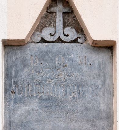 Zdjęcie nr 1: Płyta w formie leżącego prostokąta, zwieńczona szczytem z krzyżem na wolutowej podstawie. W polu inskrypcja „D(eo) O(ptimo) M(aximo) / Tomasz / GREGOROWICZ / Sędzia dobr kamar. Niepołomice Krzeczo[wice] / + 3 Listopada 1824 r(oku) / żył lat 39.”