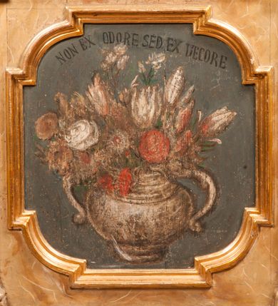 Zdjęcie nr 8: Para przyściennych stalli ustawionych po obu stronach prezbiterium w Niepołomicach uzyskała formę architektoniczną z wysokimi zapleckami i obudowanymi klęcznikami ustawionymi z przodu. Każda z nich otrzymała pięć siedzisk. Wejście do każdej znajduje się z boku i na środku. Przy wejściach z boku na przedpiersiu ustawiono cebulaste sterczyny na prostopadłościennych cokolikach. Zaplecki artykułowano za pomocą pilastrów o kompozytowych kapitelach dźwigających niepełne belkowanie z wydatnym gzymsem, wyłamane na ich osiach. Całość została zwieńczona pięcioma dekoracyjnymi wazami płomienistymi ustawionymi na prostopadłościennych cokolikach. W polach pomiędzy pilastrami umieszczono cztery profilowane, złocone ramy o rożnym kształcie (owalnym, czworobocznym, półkolistym i wielobocznym) z pojedynczymi przedstawieniami  świętych. W stalli południowej od lewej wyobrażono: św. Jana Kantego, Marcina Baryczkę, Świętosława Milczącego, św. Feliksa z Noli. Z kolei w stalli północnej od prawej ukazano: św. Filipa Nereusza, św. Jana Nepomucena, św. Walentego i św. Faustyna z Bresci. Świętych identyfikują czarne, majuskułowe podpisy, których kształt liter sugeruje, że zostały wprowadzone w pierwszej połowie XIX wieku. Poniżej każdego wizerunku na cokołach zaplecków w płycinach wyznaczonych prostokątnymi, złoconymi i profilowanymi ramkami znalazły się łacińskie sentencje. Także lica przedpiersi zostały artykułowane pilastrami na cokołach, jednakże bez dekoracyjnych głowic. Pomiędzy nimi w czworobocznych, profilowanych i złoconych ramach o wklęsłych narożach wyobrażono bukiety kwiatów. Kwiaty ukazano naprzemiennie w płaskich koszach lub wazach na niebieskim tle. Na niektórych bukietach widoczne są siedzące ptaki. Ponad bukietami znalazły się pisane czarnymi literami łacińskie sentencje. Elementy architektoniczne zostały pokryte marmuryzcją, a ramy i detale zdobnicze pozłocono. Na stalli na ścianie północnej ponad kapitelem skrajnego pilastra od zachodu widnieje data ich wykonania: A(NNO) D(OMINI) 1766. Z kolei na stalli na ścianie południowej, ponad kapitelem skrajnego pilastra od zachodu widnieją zapewne inicjały fundatora: X(IĄDZ). / TCD. W / P(LEBANUS) N(IEPOLOMICENSIS).