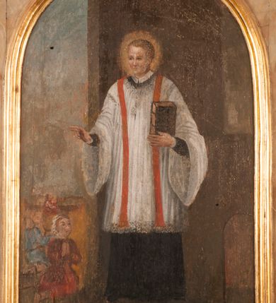 Zdjęcie nr 3: Kompozycja obrazu została zamknięta złoconą, profilowaną ramą zamkniętą półkoliście o uskokowo wyciętych narożach u dołu. W centrum obrazu przedstawiono św. Walentego we wnętrzu otwierającym się z lewej strony na wolną przestrzeń. Święty został ukazany frontalnie w całej postaci. W lewej, zgiętej w łokciu ręce trzyma przy piersi pionowo ustawioną księgę w ciemnych okładkach, spiętych dwiema klamrami. Prawą natomiast udziela błogosławieństwa ludziom widocznym z lewej strony kompozycji. Jego głowa otoczona świetlistym nimbem nieznacznie została ujęta w trzech czwartych w prawo. Jest to młody, szczupły mężczyzna o jasnej karnacji i takich samych krótkich włosach z wyraźnie zaznaczoną grzywką. Ma pociągłą twarz pozbawioną zarostu. Charakteryzuje ją wysokie czoło, drobny nos i usta. Święty ubrany jest w czarną sutannę z koloratką w formie kołnierzyka, sięgającą kolan białą komżę związaną pod szyją o szerokich rękawach, obszytą koronką oraz czerwoną stułę. U stóp świętego, na brązowej posadzce leży miecz ze złotą rękojeścią. Po lewej stronie kompozycji na tle błękitnego, zamglonego nieba ukazano nieznacznie oddalone od sienie trzy klęczące postacie chorych. Są oni ubrani w barwne stroje. Z modlitewnie złożonymi rękami zwracają się w stronę świętego. Na pierwszym planie jest to młoda dziewczyna w czerwonej sukni i białej chustce na głowie. U jej kolan leży drewniana kula. Podobna kula widoczna jest w rękach postaci ubranej na niebiesko znajdującej się za nią. Trzecia, najmniejsza postać ubrana jest na czerwono. Pod obrazem znajduje się czarny napis „S(ANCTUS) VALENTINUS PRES(BYTER)”. Poniżej, na płycinie stalli w prostokątnym, profilowanym i złoconym obramieniu umieszczono drugi napis „MALE HABENTES AD EUM ACCEDEBANT / ET SANITATEM RECIPIEBANT”.