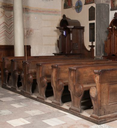 Zdjęcie nr 1: Ławki wykonano na rzucie prostokąta. Są cztero- i dwurzędowe. Przedpiersia udekorowano wydzielonymi dwiema, prostokątnymi płycinami. Z kolei ich boki w partii siedzisk i powyżej klęczników ozdobione zostały charakterystycznymi ślimacznicami.