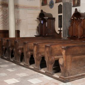 Zdjęcie nr 1: Ławki wykonano na rzucie prostokąta. Są cztero- i dwurzędowe. Przedpiersia udekorowano wydzielonymi dwiema, prostokątnymi płycinami. Z kolei ich boki w partii siedzisk i powyżej klęczników ozdobione zostały charakterystycznymi ślimacznicami.