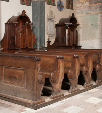 Zdjęcie nr 2: Ławki wykonano na rzucie prostokąta. Są cztero- i dwurzędowe. Przedpiersia udekorowano wydzielonymi dwiema, prostokątnymi płycinami. Z kolei ich boki w partii siedzisk i powyżej klęczników ozdobione zostały charakterystycznymi ślimacznicami.