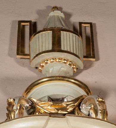 Zdjęcie nr 17: Kamienna chrzcielnica osadzona na wysokim cokole na planie kwadratu, z profilowanym, wielostopniowym trzonem, dekorowanym puklowaniem, liśćmi akantu i uskrzydlonymi główkami anielskimi. Czara puklowana, ozdobiona kartuszem z godłem herbowym Jastrzębiec od frontu oraz kartuszem z godłem herbowym Gryf po przeciwnej stronie, po bokach dwa bukraniony. Chrzcielnica polichromowana w kolorze czerwonym ze złoconymi detalami. Drewniana pokrywa w formie podstawy dekorowanej perełkowaniem i żłobkami, zwieńczona klasycystycznym wazonem zdobionym girlandami, zakończonym kwiatem. 
Chrzcielnica umieszczona w niszy drewnianej oprawy filara arkady tęczowej. Nadbudowa jest architektoniczna, dwukondygnacyjna ze zwieńczeniem. Pierwsza kondygnacja z niszą ujętą dwustrefowym cokołem, zakończonym profilowanym gzymsem dekorowanym żłobkami, zakończonym kartuszem, flankowana kwiatowymi zwisami. Druga kondygnacja z płyciną ujętą pilastrami ozdobionymi kwiatowymi zwisami, zakończonymi gzymsem przechodzącym w woluty, na których znajdują się uskrzydlone główki anielskie. W niszy na rzeźbionym fragmencie skały, flankowanym dwoma drzewami, grupa rzeźbiarska Chrztu Chrystusa. Nad nią na łuku gołębica Ducha Świętego w glorii promienistej. Zwieńczenie w kształcie zbliżonym do kwadratu, ujętego spływami wolutowymi dekorowanymi akantem, zakończone gzymsem i baldachimem. W polu, na obłoku rzeźbiona półpostać Boga Ojca z nimbem trójkątnym i promienistym wokół głowy. Baldachim na planie półkola, w formie niepełnego belkowania, na nim cztery kabłąki podtrzymujące cokół, na którym znajduje się klasycystyczny wazon. Oprawa polichromowana w kolorze seledynowym, ze złoconymi profilami i ornamentyką. 
