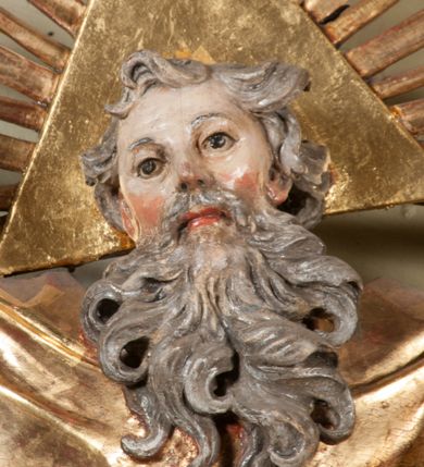 Zdjęcie nr 41: Kamienna chrzcielnica osadzona na wysokim cokole na planie kwadratu, z profilowanym, wielostopniowym trzonem, dekorowanym puklowaniem, liśćmi akantu i uskrzydlonymi główkami anielskimi. Czara puklowana, ozdobiona kartuszem z godłem herbowym Jastrzębiec od frontu oraz kartuszem z godłem herbowym Gryf po przeciwnej stronie, po bokach dwa bukraniony. Chrzcielnica polichromowana w kolorze czerwonym ze złoconymi detalami. Drewniana pokrywa w formie podstawy dekorowanej perełkowaniem i żłobkami, zwieńczona klasycystycznym wazonem zdobionym girlandami, zakończonym kwiatem. 
Chrzcielnica umieszczona w niszy drewnianej oprawy filara arkady tęczowej. Nadbudowa jest architektoniczna, dwukondygnacyjna ze zwieńczeniem. Pierwsza kondygnacja z niszą ujętą dwustrefowym cokołem, zakończonym profilowanym gzymsem dekorowanym żłobkami, zakończonym kartuszem, flankowana kwiatowymi zwisami. Druga kondygnacja z płyciną ujętą pilastrami ozdobionymi kwiatowymi zwisami, zakończonymi gzymsem przechodzącym w woluty, na których znajdują się uskrzydlone główki anielskie. W niszy na rzeźbionym fragmencie skały, flankowanym dwoma drzewami, grupa rzeźbiarska Chrztu Chrystusa. Nad nią na łuku gołębica Ducha Świętego w glorii promienistej. Zwieńczenie w kształcie zbliżonym do kwadratu, ujętego spływami wolutowymi dekorowanymi akantem, zakończone gzymsem i baldachimem. W polu, na obłoku rzeźbiona półpostać Boga Ojca z nimbem trójkątnym i promienistym wokół głowy. Baldachim na planie półkola, w formie niepełnego belkowania, na nim cztery kabłąki podtrzymujące cokół, na którym znajduje się klasycystyczny wazon. Oprawa polichromowana w kolorze seledynowym, ze złoconymi profilami i ornamentyką. 
