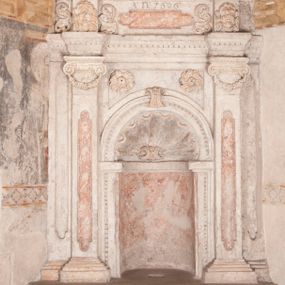 Zdjęcie nr 1: Kamienny lawetarz został osadzony na cokole, którego front zdobi putto trzymające w ręce kartusz herbowy z nieczytelnym godłem. Pod kartuszem widoczna jest czworoboczna wnęka. Nad cokołem znajduje się nisza konchowa z konchą wypełnioną muszlą, ujęta jońskimi pilastrami podtrzymującymi belkowanie, którego fryz ozdobiono główkami aniołków. Archiwolta ponad konchą została na środku przewiązana wolutowym kluczem. Z kolei w przyłuczu konchy znalazły się dwie rozety. Kapitele pilastrów flankujące niszę dodatkowo dekorowane są podwieszonymi girlandami, zaś ich trzony wydłużonymi płycinami. Architraw i gzyms zdobione są kostkowaniem. Na belkowaniu widnieje inskrypcja: „T(HOMAS) O(LINSKI) P(LEBANUS) N(IEPOLOMICENSIS) / A(NNO) D(OMINI) 1696”. Całość wieńczy figura diakona ubranego w białą albę i pomarańczową dalmatykę. W lewej ręce trzyma zamkniętą księgę. Prawa ręka uniesiona na wysokości pasa jest uszkodzona.