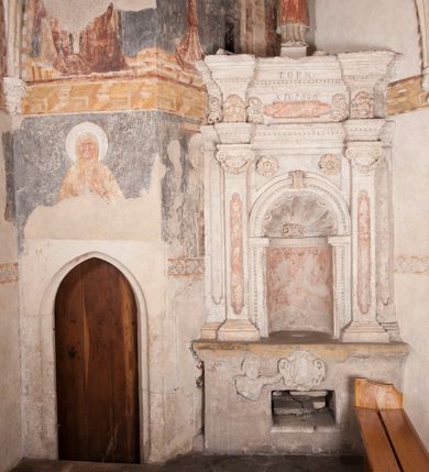 Zdjęcie nr 5: Kamienny lawetarz został osadzony na cokole, którego front zdobi putto trzymające w ręce kartusz herbowy z nieczytelnym godłem. Pod kartuszem widoczna jest czworoboczna wnęka. Nad cokołem znajduje się nisza konchowa z konchą wypełnioną muszlą, ujęta jońskimi pilastrami podtrzymującymi belkowanie, którego fryz ozdobiono główkami aniołków. Archiwolta ponad konchą została na środku przewiązana wolutowym kluczem. Z kolei w przyłuczu konchy znalazły się dwie rozety. Kapitele pilastrów flankujące niszę dodatkowo dekorowane są podwieszonymi girlandami, zaś ich trzony wydłużonymi płycinami. Architraw i gzyms zdobione są kostkowaniem. Na belkowaniu widnieje inskrypcja: „T(HOMAS) O(LINSKI) P(LEBANUS) N(IEPOLOMICENSIS) / A(NNO) D(OMINI) 1696”. Całość wieńczy figura diakona ubranego w białą albę i pomarańczową dalmatykę. W lewej ręce trzyma zamkniętą księgę. Prawa ręka uniesiona na wysokości pasa jest uszkodzona.