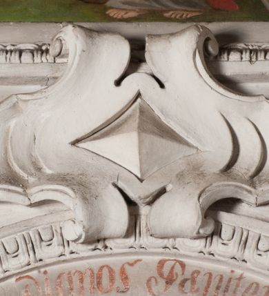 Zdjęcie nr 5: Obraz otrzymał kształt stojącego prostokąta zamkniętego łukiem pełnym. Na tle schematycznie przedstawionego pagórkowatego pejzażu ukazano w nieznacznym kontrapoście w całej postaci św. Karola Boromeusza. Święty został przedstawiony frontalnie z głową lekko pochyloną i zwróconą w trzech czwartych w lewo. Spogląda na drewniany krucyfiks, ułożony ukośnie i oparty o jego lewe ramię, który trzyma obiema dłońmi. Ma owalną twarz z charakterystycznym wydatnym nosem, wąskie usta oraz krótkie ciemnobrązowe włosy. Ubrany jest w strój kardynalski: purpurową sutannę, mucet i piuskę oraz białą komżę. Stopy ma bose. Na ramionach widoczny jest zarzucony powróz pokutny z węzłami, zakończony szeroką pętlą. Ponad obrazem na łuku archiwolty widnieje czerwony łaciński napis: „Iacite ergo fructus dignios Paenitentiae Luc[a]. Cap[ut]. 3 vers[us] 8”. Z kolei pod obrazem na dolnej krawędzi znajduje się napis polski: „Boso na szyi powróz w processyi nosi / i by Bóg karę oddalił z płaczem o to prosi”.   