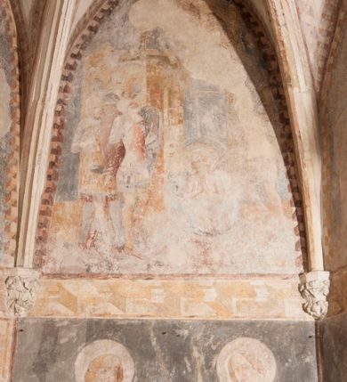 Zdjęcie nr 14: Zachowana dekoracja malarska znajduje się w tzw. starej zakrystii, określanej także jako oratorium królewskie. Dobudowano ją od północy do prezbiterium niepołomickiego kościoła. Jest to niewielka budowla na rzucie wydłużonego prostokąta, nakryta trójprzęsłowym krzyżowo-żebrowym sklepieniem, od wschodu zamknięta dwubocznie. Od zachodu w narożniku południowym widoczne jest załamanie muru, tworzącego dwie ściany wieżyczki schodowej. Do jej wnętrza prowadzi ostrołukowy portal. Oratorium oświetlają trzy ostrołukowe okna. Tylko czwarte, obecnie zamurowane, przeprute w murze północno-wschodnim pochodzi z czasów budowy kościoła. Stara zakrystia połączona jest z kościołem za pomocą ostrołukowego, profilowanego kamiennego portalu umieszczonego w środkowym przęśle ściany południowej. Na sklepieniu znajdują się rzeźbione zworniki z przedstawieniem w przęśle wschodnim głowy Chrystusa w nimbie krzyżowym, w środkowym maski liściastej, a w zachodnim motywów roślinnych. Podobnie rzeźbione motywy roślinne  pokrywają wsporniki, na które spływają żebra. 
Zachowana polichromia tworzy z architekturą starej zakrystii harmonijną całość. Białe wysklepki sklepień otoczone są wielobarwnymi, namalowanymi wzdłuż żeber, iluzjonistyczno-geometrycznymi pasami imitującymi kamienne inkrustacje w typie "arte cosmatesca". Pierwotnie polichromowane były także same żebra oraz rzeźbione zworniki i wsporniki. Pionowym rytmom barwnych pasów przeciwstawiają się na ścianie wschodniej, południowej i zachodniej dwa poziome, iluzjonistyczne malowane fryzy. Górny, w odcieniach brązów jest szerszy i przypomina gzyms. Przebiega w połowie wysokości ścian, na poziomie wsporników. Poniżej znajduje się drugi, o połowę węższy, skomponowany z wielobarwnych geometrycznych rozet w rombowych polach. Fryzy wyznaczają trzy strefy dekoracji. Dolny pas uległ zniszczeniu za wyjątkiem niewielkiego fragmentu iluzjonistycznie malowanej konsolki na ścianie południowej. Dla strefy środkowej głównej tło stanowi niebieska barwa. Niestety oba te pasy obecnie są mocno uszkodzone. 
Pierwotnie pas środkowy ścian zajmowały naturalnej wielkości postacie kobiece, ujęte powyżej kolan. Z namalowanych dwunastu świętych do naszych czasów przetrwało sześć - w całości cztery (na ścianie wschodniej, południowej i zachodniej) oraz jedna bez głowy (ściana południowa) i jedna w połowie (ściana zachodnia). Są to jasno lub ciemnowłose młode kobiety, trzymające palmy męczeństwa. Ubrane są w suknie z narzuconymi płaszczami w kolorach żółtym, oliwkowym, różowym, liliowym, brązowym i błękitnym. Jedna z nich, wyobrażona ponad wejściem na klatkę schodową w wieżyczce, jest ukazana jako kobieta w podeszłym wieku z okrytą głową i dłońmi uniesionymi na wysokość piersi w geście orantki. Głowy męczennic i orantki okalają plastycznie, tłoczone w zaprawie nimby zdobione promieniami. Na niektórych głowach dziewic zachowały się ślady namalowanych brązową farbą koron o niskich sterczynach w kształcie heraldycznych lilii. 
W ścianie północno-wschodniej dwubocznego zamknięcia znajduje się obecnie zamurowane lancetowate, ostrołukowe okno z fragmentami polichromii w glifie okiennym. Pierwotnie tworzyło ją dziesięć czterolistnych obramowań wpisanych w romby, umieszczonych jeden nad drugim. Przedstawiono w nich w półpostaci aniołów z głowami otoczonymi nimbami. W dolnej części okno do  poziomu gotyckich wsporników otacza iluzjonistycznie malowana dekoracja utworzona z motywów kamiennych płyt.  
W górnej strefie oratorium wyobrażono cykl hagiograficzny, składający się z sześciu scen namalowanych w ostrołukowych polach, wyznaczonych łukami tarczowymi sklepień i ujętych w obramienia z plastycznie malowanych zębów. Ograniczający je od dołu, iluzjonistycznie malowany, jakby wystający gzyms nadaje przedstawieniom teatralną głębie. 
Na ścianie południowo-wschodniej przedstawiono bliżej niezidentyfikowaną scenę męczeństwa. Na tle ochrowo-żółtej architektury ukazano z lewej strony na pierwszym planie grupę  rycerzy, z których dwóch widocznych jest w całej postaci w średniowiecznych zbrojach stylizowanych na rzymskie, w hełmach i z ostrołukowymi tarczami trzymanymi w lewych rękach. Ich odzież ma kolor błękitny, granatowy, czerwony, fioletowy, cynobrowy. Rycerze lekko unoszą głowy w stronę półpostaci wychylającej się z okna loggi w górnej części architektury. Był to zapewne władca, dziś jego postać zachowała się tylko fragmentarycznie. Postać z okna wskazuje palcem na centralnie ukazany kocioł zawieszony pod arkadą, stanowiącą część architektury tła. Widoczna w nim jest w półpostaci jasnowłosa kobieta w białej sukni na ramiączkach z modlitewnie złożonymi rękami na piersi. Jej głowę otacza nimb. Kocioł wisi na haku za półokrągły uchwyt, pod nim pali się ognisko. Z prawej strony kotła widoczna jest fragmentarycznie zachowana postać rycerza w zbroi, który oburącz długim kijem miesza w kotle. 
Na prawo od sceny męczeństwa na ścianie południowej namalowano scenę określaną jako "przed władcą". W centrum przedstawienia na tle architektury wyobrażono tron z zasiadającym na nim władcą. Jest to brodaty mężczyzna ukazany z profilu z koroną na głowie, który w prawej dłoni unosi berło skierowane w stronę przyprowadzonej do niego kobiety. Tron i architektoniczne jego obramienie malowane jest w kolorach brązu i ochry. Jego zaplecek dekoruje zawieszona pasiasta tkanina. Ciemnowłosy władca ubrany jest w turkusową szatę z narzuconym na ramiona brązowym płaszczem. Za tronem z lewej strony stoi paź o kędzierzawej fryzurze wsparty na trzymanym ostrzem w dół mieczu. Stojąca przed władcą kobieta ubrana jest w czerwoną długą suknię. Ma jasne włosy, a jej głowę okala nimb. Ręce ma skrzyżowane i związane na wysokości pasa. Obok niej stoi inna postać także w długiej szacie, z uniesioną prawą dłonią. Za świętą widoczne są inne postacie, niestety skala zniszczenia malowidła uniemożliwia ich opis i identyfikację. 
Trzecie malowidło, usytuowane nad wejściem do oratorium, ukazuje scenę dysputyt. W centrum przedstawienia pod architektonicznym zadaszeniem w formie portyku lub altany o kasetonowym stropie, wspartym na dwóch czworobocznych filarach, ukazano widoczne z profilu trzy siedzące  kobiety. Jedna z lewej strony a dwie naprzeciwko z prawej. Kobieta z lewej  ma odkryte jasne, długie włosy. Jej głowę otacza nimb. Na wysokość piersi unosi obie dłonie, sprawiając wrażenie, jakby w nich trzymała owalny przedmiot. Ubrana jest w ciemnoczerwoną długą suknię, zakrywającą nogi. Naprzeciw niej siedzą dwie inne niewiasty o długich, jasnych włosach w prostych koronach na głowach. Jedna z nich unosi swoją prawą rękę. Obie ubrane są w długie suknie w kolorze ochry. Za nimi pomiędzy filarami widoczna jest rozpięta zasłona w pionowe oliwkowe, zielone, białe i czerwone pasy. Na podłodze leży dywan dekorowany w żółte, zielone, niebieskie i czerwone pasy. 
Mocno zniszczone w dolnej części czwarte przedstawienie ilustruje scenę chłosty. Z lewej strony kompozycji wyobrażono budowlę z architektoniczną loggią, z której w półpostaci wychyla się władca. W prawej ręce poziomo trzyma berło skierowane w stronę grupy osób, za którymi wykonywana jest kara chłosty. Władca, podobnie jak w drugiej scenie, został ukazany jako mężczyzna o ciemnym zaroście i takich samych włosach. Na głowie ma koronę. Ubrany jest w brązowe szaty o różnych odcieniach. Centralnie przedstawioną stłoczoną grupę tworzy czterech żołnierzy oraz starszy mężczyzna w zawoju na głowie z siwą, długą brodą. Żołnierze mają zbroje i hełmy. Jeden z nich, najbliżej stojący z lewej przedstawiony został w profilu z głową i prawą ręką skierowaną w stronę króla. Także w stronę władcy zwrócony jest mężczyzna w zawoju na głowie z dwiema dłońmi uniesionymi na wysokość piersi. Z prawej strony kompozycji namalowano, dziś fragmentarycznie zachowany, rodzaj drewnianej szubienicy, utworzonej z poprzecznie zawieszonego na drewnianych podporach drążka. Nad dróżką do góry nogami wisi postać (dziś zniszczona), z której zachowały się jedynie stopy związane w kostkach sznurem. W jej stronę zwraca się jeden z żołnierzy ze środkowej grupy. Po prawej stronie szubienicy widoczna jest część postaci oprawcy, z której zachował się tylko fragment głowy oraz uniesiona lewa ręka z drewnianą pałką. 
Dwie ostatnie sceny umieszczono na zachodnim murze oratorium. Pierwsza z nich przedstawia strącenie bożka i została połączona z drugą ukazującą uwolnienia z więzienia. Część centralną kompozycji stanowi potrzaskana, wywracająca się kolumna, z której spada szatan w postaci żywego demona pokrytego sierścią. Strącił go widoczny w półpostaci w górnej części malowidła anioł trzymający w prawej ręce miecz. Z lewej strony kompozycji  klęczy na skalistej ziemi święta ubrana w długą ciemnoczerwoną suknię. Niestety nie zachowała się górna część jej postaci. Za nią stoi stłoczona grupa przerażonych świadków tego wydarzenia. Natomiast z prawej strony malowidła wyobrażono scenę uwolnienia z więzienia. Jej zasadniczym elementem jest architektoniczna struktura nawiązująca kształtem do wieży mieszkalnej, więzienia bądź bramy miejskiej. Święta ze związanymi rękami w ciemnoczerwonej sukni wychodzi z niej z prawej strony. W centrum budowli widoczne jest półokrągłe okno, a w nim zapewne jej popiersie o długich jasnych włosach, trzymające w dłoniach jakiś przedmiot. Wszystkie sceny cyklu w jedną całość wiąże gładkie niebieskie tło. Niezachowana kompozycja polichromii na ścianie północnej musiała odbiegać swym układem od pozostałych ścian. Płaszczyzna ścian została podzielona za pomocą węższego dolnego fryzu na dwie strefy. Górną część najprawdopodobniej zajmowały duże postacie stojące (fragment jednej z nich zachował się w sąsiedztwie okna w ścianie północno-wschodniej). Pod fryzem w części dolnej najprawdopodobniej była namalowana iluzjonistycznie wisząca kotara.   
    




