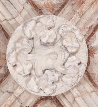 Zdjęcie nr 20: Zachowana dekoracja malarska znajduje się w tzw. starej zakrystii, określanej także jako oratorium królewskie. Dobudowano ją od północy do prezbiterium niepołomickiego kościoła. Jest to niewielka budowla na rzucie wydłużonego prostokąta, nakryta trójprzęsłowym krzyżowo-żebrowym sklepieniem, od wschodu zamknięta dwubocznie. Od zachodu w narożniku południowym widoczne jest załamanie muru, tworzącego dwie ściany wieżyczki schodowej. Do jej wnętrza prowadzi ostrołukowy portal. Oratorium oświetlają trzy ostrołukowe okna. Tylko czwarte, obecnie zamurowane, przeprute w murze północno-wschodnim pochodzi z czasów budowy kościoła. Stara zakrystia połączona jest z kościołem za pomocą ostrołukowego, profilowanego kamiennego portalu umieszczonego w środkowym przęśle ściany południowej. Na sklepieniu znajdują się rzeźbione zworniki z przedstawieniem w przęśle wschodnim głowy Chrystusa w nimbie krzyżowym, w środkowym maski liściastej, a w zachodnim motywów roślinnych. Podobnie rzeźbione motywy roślinne  pokrywają wsporniki, na które spływają żebra. 
Zachowana polichromia tworzy z architekturą starej zakrystii harmonijną całość. Białe wysklepki sklepień otoczone są wielobarwnymi, namalowanymi wzdłuż żeber, iluzjonistyczno-geometrycznymi pasami imitującymi kamienne inkrustacje w typie "arte cosmatesca". Pierwotnie polichromowane były także same żebra oraz rzeźbione zworniki i wsporniki. Pionowym rytmom barwnych pasów przeciwstawiają się na ścianie wschodniej, południowej i zachodniej dwa poziome, iluzjonistyczne malowane fryzy. Górny, w odcieniach brązów jest szerszy i przypomina gzyms. Przebiega w połowie wysokości ścian, na poziomie wsporników. Poniżej znajduje się drugi, o połowę węższy, skomponowany z wielobarwnych geometrycznych rozet w rombowych polach. Fryzy wyznaczają trzy strefy dekoracji. Dolny pas uległ zniszczeniu za wyjątkiem niewielkiego fragmentu iluzjonistycznie malowanej konsolki na ścianie południowej. Dla strefy środkowej głównej tło stanowi niebieska barwa. Niestety oba te pasy obecnie są mocno uszkodzone. 
Pierwotnie pas środkowy ścian zajmowały naturalnej wielkości postacie kobiece, ujęte powyżej kolan. Z namalowanych dwunastu świętych do naszych czasów przetrwało sześć - w całości cztery (na ścianie wschodniej, południowej i zachodniej) oraz jedna bez głowy (ściana południowa) i jedna w połowie (ściana zachodnia). Są to jasno lub ciemnowłose młode kobiety, trzymające palmy męczeństwa. Ubrane są w suknie z narzuconymi płaszczami w kolorach żółtym, oliwkowym, różowym, liliowym, brązowym i błękitnym. Jedna z nich, wyobrażona ponad wejściem na klatkę schodową w wieżyczce, jest ukazana jako kobieta w podeszłym wieku z okrytą głową i dłońmi uniesionymi na wysokość piersi w geście orantki. Głowy męczennic i orantki okalają plastycznie, tłoczone w zaprawie nimby zdobione promieniami. Na niektórych głowach dziewic zachowały się ślady namalowanych brązową farbą koron o niskich sterczynach w kształcie heraldycznych lilii. 
W ścianie północno-wschodniej dwubocznego zamknięcia znajduje się obecnie zamurowane lancetowate, ostrołukowe okno z fragmentami polichromii w glifie okiennym. Pierwotnie tworzyło ją dziesięć czterolistnych obramowań wpisanych w romby, umieszczonych jeden nad drugim. Przedstawiono w nich w półpostaci aniołów z głowami otoczonymi nimbami. W dolnej części okno do  poziomu gotyckich wsporników otacza iluzjonistycznie malowana dekoracja utworzona z motywów kamiennych płyt.  
W górnej strefie oratorium wyobrażono cykl hagiograficzny, składający się z sześciu scen namalowanych w ostrołukowych polach, wyznaczonych łukami tarczowymi sklepień i ujętych w obramienia z plastycznie malowanych zębów. Ograniczający je od dołu, iluzjonistycznie malowany, jakby wystający gzyms nadaje przedstawieniom teatralną głębie. 
Na ścianie południowo-wschodniej przedstawiono bliżej niezidentyfikowaną scenę męczeństwa. Na tle ochrowo-żółtej architektury ukazano z lewej strony na pierwszym planie grupę  rycerzy, z których dwóch widocznych jest w całej postaci w średniowiecznych zbrojach stylizowanych na rzymskie, w hełmach i z ostrołukowymi tarczami trzymanymi w lewych rękach. Ich odzież ma kolor błękitny, granatowy, czerwony, fioletowy, cynobrowy. Rycerze lekko unoszą głowy w stronę półpostaci wychylającej się z okna loggi w górnej części architektury. Był to zapewne władca, dziś jego postać zachowała się tylko fragmentarycznie. Postać z okna wskazuje palcem na centralnie ukazany kocioł zawieszony pod arkadą, stanowiącą część architektury tła. Widoczna w nim jest w półpostaci jasnowłosa kobieta w białej sukni na ramiączkach z modlitewnie złożonymi rękami na piersi. Jej głowę otacza nimb. Kocioł wisi na haku za półokrągły uchwyt, pod nim pali się ognisko. Z prawej strony kotła widoczna jest fragmentarycznie zachowana postać rycerza w zbroi, który oburącz długim kijem miesza w kotle. 
Na prawo od sceny męczeństwa na ścianie południowej namalowano scenę określaną jako "przed władcą". W centrum przedstawienia na tle architektury wyobrażono tron z zasiadającym na nim władcą. Jest to brodaty mężczyzna ukazany z profilu z koroną na głowie, który w prawej dłoni unosi berło skierowane w stronę przyprowadzonej do niego kobiety. Tron i architektoniczne jego obramienie malowane jest w kolorach brązu i ochry. Jego zaplecek dekoruje zawieszona pasiasta tkanina. Ciemnowłosy władca ubrany jest w turkusową szatę z narzuconym na ramiona brązowym płaszczem. Za tronem z lewej strony stoi paź o kędzierzawej fryzurze wsparty na trzymanym ostrzem w dół mieczu. Stojąca przed władcą kobieta ubrana jest w czerwoną długą suknię. Ma jasne włosy, a jej głowę okala nimb. Ręce ma skrzyżowane i związane na wysokości pasa. Obok niej stoi inna postać także w długiej szacie, z uniesioną prawą dłonią. Za świętą widoczne są inne postacie, niestety skala zniszczenia malowidła uniemożliwia ich opis i identyfikację. 
Trzecie malowidło, usytuowane nad wejściem do oratorium, ukazuje scenę dysputyt. W centrum przedstawienia pod architektonicznym zadaszeniem w formie portyku lub altany o kasetonowym stropie, wspartym na dwóch czworobocznych filarach, ukazano widoczne z profilu trzy siedzące  kobiety. Jedna z lewej strony a dwie naprzeciwko z prawej. Kobieta z lewej  ma odkryte jasne, długie włosy. Jej głowę otacza nimb. Na wysokość piersi unosi obie dłonie, sprawiając wrażenie, jakby w nich trzymała owalny przedmiot. Ubrana jest w ciemnoczerwoną długą suknię, zakrywającą nogi. Naprzeciw niej siedzą dwie inne niewiasty o długich, jasnych włosach w prostych koronach na głowach. Jedna z nich unosi swoją prawą rękę. Obie ubrane są w długie suknie w kolorze ochry. Za nimi pomiędzy filarami widoczna jest rozpięta zasłona w pionowe oliwkowe, zielone, białe i czerwone pasy. Na podłodze leży dywan dekorowany w żółte, zielone, niebieskie i czerwone pasy. 
Mocno zniszczone w dolnej części czwarte przedstawienie ilustruje scenę chłosty. Z lewej strony kompozycji wyobrażono budowlę z architektoniczną loggią, z której w półpostaci wychyla się władca. W prawej ręce poziomo trzyma berło skierowane w stronę grupy osób, za którymi wykonywana jest kara chłosty. Władca, podobnie jak w drugiej scenie, został ukazany jako mężczyzna o ciemnym zaroście i takich samych włosach. Na głowie ma koronę. Ubrany jest w brązowe szaty o różnych odcieniach. Centralnie przedstawioną stłoczoną grupę tworzy czterech żołnierzy oraz starszy mężczyzna w zawoju na głowie z siwą, długą brodą. Żołnierze mają zbroje i hełmy. Jeden z nich, najbliżej stojący z lewej przedstawiony został w profilu z głową i prawą ręką skierowaną w stronę króla. Także w stronę władcy zwrócony jest mężczyzna w zawoju na głowie z dwiema dłońmi uniesionymi na wysokość piersi. Z prawej strony kompozycji namalowano, dziś fragmentarycznie zachowany, rodzaj drewnianej szubienicy, utworzonej z poprzecznie zawieszonego na drewnianych podporach drążka. Nad dróżką do góry nogami wisi postać (dziś zniszczona), z której zachowały się jedynie stopy związane w kostkach sznurem. W jej stronę zwraca się jeden z żołnierzy ze środkowej grupy. Po prawej stronie szubienicy widoczna jest część postaci oprawcy, z której zachował się tylko fragment głowy oraz uniesiona lewa ręka z drewnianą pałką. 
Dwie ostatnie sceny umieszczono na zachodnim murze oratorium. Pierwsza z nich przedstawia strącenie bożka i została połączona z drugą ukazującą uwolnienia z więzienia. Część centralną kompozycji stanowi potrzaskana, wywracająca się kolumna, z której spada szatan w postaci żywego demona pokrytego sierścią. Strącił go widoczny w półpostaci w górnej części malowidła anioł trzymający w prawej ręce miecz. Z lewej strony kompozycji  klęczy na skalistej ziemi święta ubrana w długą ciemnoczerwoną suknię. Niestety nie zachowała się górna część jej postaci. Za nią stoi stłoczona grupa przerażonych świadków tego wydarzenia. Natomiast z prawej strony malowidła wyobrażono scenę uwolnienia z więzienia. Jej zasadniczym elementem jest architektoniczna struktura nawiązująca kształtem do wieży mieszkalnej, więzienia bądź bramy miejskiej. Święta ze związanymi rękami w ciemnoczerwonej sukni wychodzi z niej z prawej strony. W centrum budowli widoczne jest półokrągłe okno, a w nim zapewne jej popiersie o długich jasnych włosach, trzymające w dłoniach jakiś przedmiot. Wszystkie sceny cyklu w jedną całość wiąże gładkie niebieskie tło. Niezachowana kompozycja polichromii na ścianie północnej musiała odbiegać swym układem od pozostałych ścian. Płaszczyzna ścian została podzielona za pomocą węższego dolnego fryzu na dwie strefy. Górną część najprawdopodobniej zajmowały duże postacie stojące (fragment jednej z nich zachował się w sąsiedztwie okna w ścianie północno-wschodniej). Pod fryzem w części dolnej najprawdopodobniej była namalowana iluzjonistycznie wisząca kotara.   
    




