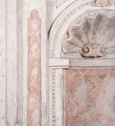 Zdjęcie nr 30: Zachowana dekoracja malarska znajduje się w tzw. starej zakrystii, określanej także jako oratorium królewskie. Dobudowano ją od północy do prezbiterium niepołomickiego kościoła. Jest to niewielka budowla na rzucie wydłużonego prostokąta, nakryta trójprzęsłowym krzyżowo-żebrowym sklepieniem, od wschodu zamknięta dwubocznie. Od zachodu w narożniku południowym widoczne jest załamanie muru, tworzącego dwie ściany wieżyczki schodowej. Do jej wnętrza prowadzi ostrołukowy portal. Oratorium oświetlają trzy ostrołukowe okna. Tylko czwarte, obecnie zamurowane, przeprute w murze północno-wschodnim pochodzi z czasów budowy kościoła. Stara zakrystia połączona jest z kościołem za pomocą ostrołukowego, profilowanego kamiennego portalu umieszczonego w środkowym przęśle ściany południowej. Na sklepieniu znajdują się rzeźbione zworniki z przedstawieniem w przęśle wschodnim głowy Chrystusa w nimbie krzyżowym, w środkowym maski liściastej, a w zachodnim motywów roślinnych. Podobnie rzeźbione motywy roślinne  pokrywają wsporniki, na które spływają żebra. 
Zachowana polichromia tworzy z architekturą starej zakrystii harmonijną całość. Białe wysklepki sklepień otoczone są wielobarwnymi, namalowanymi wzdłuż żeber, iluzjonistyczno-geometrycznymi pasami imitującymi kamienne inkrustacje w typie "arte cosmatesca". Pierwotnie polichromowane były także same żebra oraz rzeźbione zworniki i wsporniki. Pionowym rytmom barwnych pasów przeciwstawiają się na ścianie wschodniej, południowej i zachodniej dwa poziome, iluzjonistyczne malowane fryzy. Górny, w odcieniach brązów jest szerszy i przypomina gzyms. Przebiega w połowie wysokości ścian, na poziomie wsporników. Poniżej znajduje się drugi, o połowę węższy, skomponowany z wielobarwnych geometrycznych rozet w rombowych polach. Fryzy wyznaczają trzy strefy dekoracji. Dolny pas uległ zniszczeniu za wyjątkiem niewielkiego fragmentu iluzjonistycznie malowanej konsolki na ścianie południowej. Dla strefy środkowej głównej tło stanowi niebieska barwa. Niestety oba te pasy obecnie są mocno uszkodzone. 
Pierwotnie pas środkowy ścian zajmowały naturalnej wielkości postacie kobiece, ujęte powyżej kolan. Z namalowanych dwunastu świętych do naszych czasów przetrwało sześć - w całości cztery (na ścianie wschodniej, południowej i zachodniej) oraz jedna bez głowy (ściana południowa) i jedna w połowie (ściana zachodnia). Są to jasno lub ciemnowłose młode kobiety, trzymające palmy męczeństwa. Ubrane są w suknie z narzuconymi płaszczami w kolorach żółtym, oliwkowym, różowym, liliowym, brązowym i błękitnym. Jedna z nich, wyobrażona ponad wejściem na klatkę schodową w wieżyczce, jest ukazana jako kobieta w podeszłym wieku z okrytą głową i dłońmi uniesionymi na wysokość piersi w geście orantki. Głowy męczennic i orantki okalają plastycznie, tłoczone w zaprawie nimby zdobione promieniami. Na niektórych głowach dziewic zachowały się ślady namalowanych brązową farbą koron o niskich sterczynach w kształcie heraldycznych lilii. 
W ścianie północno-wschodniej dwubocznego zamknięcia znajduje się obecnie zamurowane lancetowate, ostrołukowe okno z fragmentami polichromii w glifie okiennym. Pierwotnie tworzyło ją dziesięć czterolistnych obramowań wpisanych w romby, umieszczonych jeden nad drugim. Przedstawiono w nich w półpostaci aniołów z głowami otoczonymi nimbami. W dolnej części okno do  poziomu gotyckich wsporników otacza iluzjonistycznie malowana dekoracja utworzona z motywów kamiennych płyt.  
W górnej strefie oratorium wyobrażono cykl hagiograficzny, składający się z sześciu scen namalowanych w ostrołukowych polach, wyznaczonych łukami tarczowymi sklepień i ujętych w obramienia z plastycznie malowanych zębów. Ograniczający je od dołu, iluzjonistycznie malowany, jakby wystający gzyms nadaje przedstawieniom teatralną głębie. 
Na ścianie południowo-wschodniej przedstawiono bliżej niezidentyfikowaną scenę męczeństwa. Na tle ochrowo-żółtej architektury ukazano z lewej strony na pierwszym planie grupę  rycerzy, z których dwóch widocznych jest w całej postaci w średniowiecznych zbrojach stylizowanych na rzymskie, w hełmach i z ostrołukowymi tarczami trzymanymi w lewych rękach. Ich odzież ma kolor błękitny, granatowy, czerwony, fioletowy, cynobrowy. Rycerze lekko unoszą głowy w stronę półpostaci wychylającej się z okna loggi w górnej części architektury. Był to zapewne władca, dziś jego postać zachowała się tylko fragmentarycznie. Postać z okna wskazuje palcem na centralnie ukazany kocioł zawieszony pod arkadą, stanowiącą część architektury tła. Widoczna w nim jest w półpostaci jasnowłosa kobieta w białej sukni na ramiączkach z modlitewnie złożonymi rękami na piersi. Jej głowę otacza nimb. Kocioł wisi na haku za półokrągły uchwyt, pod nim pali się ognisko. Z prawej strony kotła widoczna jest fragmentarycznie zachowana postać rycerza w zbroi, który oburącz długim kijem miesza w kotle. 
Na prawo od sceny męczeństwa na ścianie południowej namalowano scenę określaną jako "przed władcą". W centrum przedstawienia na tle architektury wyobrażono tron z zasiadającym na nim władcą. Jest to brodaty mężczyzna ukazany z profilu z koroną na głowie, który w prawej dłoni unosi berło skierowane w stronę przyprowadzonej do niego kobiety. Tron i architektoniczne jego obramienie malowane jest w kolorach brązu i ochry. Jego zaplecek dekoruje zawieszona pasiasta tkanina. Ciemnowłosy władca ubrany jest w turkusową szatę z narzuconym na ramiona brązowym płaszczem. Za tronem z lewej strony stoi paź o kędzierzawej fryzurze wsparty na trzymanym ostrzem w dół mieczu. Stojąca przed władcą kobieta ubrana jest w czerwoną długą suknię. Ma jasne włosy, a jej głowę okala nimb. Ręce ma skrzyżowane i związane na wysokości pasa. Obok niej stoi inna postać także w długiej szacie, z uniesioną prawą dłonią. Za świętą widoczne są inne postacie, niestety skala zniszczenia malowidła uniemożliwia ich opis i identyfikację. 
Trzecie malowidło, usytuowane nad wejściem do oratorium, ukazuje scenę dysputyt. W centrum przedstawienia pod architektonicznym zadaszeniem w formie portyku lub altany o kasetonowym stropie, wspartym na dwóch czworobocznych filarach, ukazano widoczne z profilu trzy siedzące  kobiety. Jedna z lewej strony a dwie naprzeciwko z prawej. Kobieta z lewej  ma odkryte jasne, długie włosy. Jej głowę otacza nimb. Na wysokość piersi unosi obie dłonie, sprawiając wrażenie, jakby w nich trzymała owalny przedmiot. Ubrana jest w ciemnoczerwoną długą suknię, zakrywającą nogi. Naprzeciw niej siedzą dwie inne niewiasty o długich, jasnych włosach w prostych koronach na głowach. Jedna z nich unosi swoją prawą rękę. Obie ubrane są w długie suknie w kolorze ochry. Za nimi pomiędzy filarami widoczna jest rozpięta zasłona w pionowe oliwkowe, zielone, białe i czerwone pasy. Na podłodze leży dywan dekorowany w żółte, zielone, niebieskie i czerwone pasy. 
Mocno zniszczone w dolnej części czwarte przedstawienie ilustruje scenę chłosty. Z lewej strony kompozycji wyobrażono budowlę z architektoniczną loggią, z której w półpostaci wychyla się władca. W prawej ręce poziomo trzyma berło skierowane w stronę grupy osób, za którymi wykonywana jest kara chłosty. Władca, podobnie jak w drugiej scenie, został ukazany jako mężczyzna o ciemnym zaroście i takich samych włosach. Na głowie ma koronę. Ubrany jest w brązowe szaty o różnych odcieniach. Centralnie przedstawioną stłoczoną grupę tworzy czterech żołnierzy oraz starszy mężczyzna w zawoju na głowie z siwą, długą brodą. Żołnierze mają zbroje i hełmy. Jeden z nich, najbliżej stojący z lewej przedstawiony został w profilu z głową i prawą ręką skierowaną w stronę króla. Także w stronę władcy zwrócony jest mężczyzna w zawoju na głowie z dwiema dłońmi uniesionymi na wysokość piersi. Z prawej strony kompozycji namalowano, dziś fragmentarycznie zachowany, rodzaj drewnianej szubienicy, utworzonej z poprzecznie zawieszonego na drewnianych podporach drążka. Nad dróżką do góry nogami wisi postać (dziś zniszczona), z której zachowały się jedynie stopy związane w kostkach sznurem. W jej stronę zwraca się jeden z żołnierzy ze środkowej grupy. Po prawej stronie szubienicy widoczna jest część postaci oprawcy, z której zachował się tylko fragment głowy oraz uniesiona lewa ręka z drewnianą pałką. 
Dwie ostatnie sceny umieszczono na zachodnim murze oratorium. Pierwsza z nich przedstawia strącenie bożka i została połączona z drugą ukazującą uwolnienia z więzienia. Część centralną kompozycji stanowi potrzaskana, wywracająca się kolumna, z której spada szatan w postaci żywego demona pokrytego sierścią. Strącił go widoczny w półpostaci w górnej części malowidła anioł trzymający w prawej ręce miecz. Z lewej strony kompozycji  klęczy na skalistej ziemi święta ubrana w długą ciemnoczerwoną suknię. Niestety nie zachowała się górna część jej postaci. Za nią stoi stłoczona grupa przerażonych świadków tego wydarzenia. Natomiast z prawej strony malowidła wyobrażono scenę uwolnienia z więzienia. Jej zasadniczym elementem jest architektoniczna struktura nawiązująca kształtem do wieży mieszkalnej, więzienia bądź bramy miejskiej. Święta ze związanymi rękami w ciemnoczerwonej sukni wychodzi z niej z prawej strony. W centrum budowli widoczne jest półokrągłe okno, a w nim zapewne jej popiersie o długich jasnych włosach, trzymające w dłoniach jakiś przedmiot. Wszystkie sceny cyklu w jedną całość wiąże gładkie niebieskie tło. Niezachowana kompozycja polichromii na ścianie północnej musiała odbiegać swym układem od pozostałych ścian. Płaszczyzna ścian została podzielona za pomocą węższego dolnego fryzu na dwie strefy. Górną część najprawdopodobniej zajmowały duże postacie stojące (fragment jednej z nich zachował się w sąsiedztwie okna w ścianie północno-wschodniej). Pod fryzem w części dolnej najprawdopodobniej była namalowana iluzjonistycznie wisząca kotara.   
    




