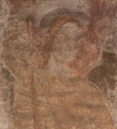 Zdjęcie nr 1: Malowidła z przedstawieniem św. Michała Archanioła pokonującego szatana i św. Jerzego walczącego ze smokiem zostały wykonane na ścianie północnej w dwóch wnękach podokiennych. Obie kompozycje powstały w polach o kształcie wydłużonego prostokąta. Święty Michał Archanioł został przedstawiony frontalnie w całej postaci z głową w ujęciu trzech czwartych w lewo. W uniesionej ponad głowę prawej ręce trzyma włócznię, wbitą w deptanego pod nogami szatana, którą jednocześnie podtrzymuje lewą ręką. Z tyłu widać jego rozpostarte skrzydła, skrzyżowane nad głową. Archanioł ma owalną twarz o wydatnym nosie oraz jasne włosy spływające na ramiona. Ubrany jest w przepasaną  tunikę sięgającą goleni i w narzucony na ramiona płaszcz. Postać diabła pod jego stopami obutymi w buty jest prawie niewidoczna. W podobny sposób przedstawiono św. Jerzego. Święty został ukazany frontalnie na rozstawionych nogach w całej postaci ujętej w kontrapoście z głową w trzech czwartych skierowaną w lewo. Prawą rękę ma uniesioną ponad głową i zgiętą w łokciu. Trzyma w niej lancę podtrzymywaną lewą ręką. Pod jego stopami widoczny jest zarys zwiniętego smoka o zarysie bazyliszka. Św. Jerzy ubrany jest w strój rycerski. Na głowie ma spiczasto zakończony hełm z kolczugą. Ciało okrywa mocno taliowana w pasie tunika zdobiona u dołu ornamentem z motywem trójkąta równoramiennego. Na nogach ma założone wysokie buty. W obu przedstawieniach widoczne są ciemne ugry, ciemna czerwień, żółcień, błękit i brąz. Tła są szare. 