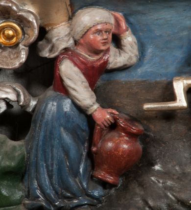 Zdjęcie nr 27: Obraz w formie stojącego prostokąta zamkniętego łukiem półkolistym. W centrum siedząca Matka Boska ukazana do kolan, frontalnie, lewym ramieniem obejmuje siedzące na jej kolanie Dzieciątko, w prawej ręce z przodu trzyma berło. Twarz ma owalną, o delikatnych rysach, dużych, migdałowatych oczach, długim, prostym nosie i niewielkich, pełnych ustach, okoloną długimi brązowymi włosami, opadającymi na ramiona. Ubrana jest w różową suknię, marszczoną przy dekolcie, z dekoracyjną lamówką oraz w obfity ciemnoniebieski płaszcz zarzucony na ramiona i opadający na kolana, ze złoconą lamówką i gwiazdą na prawym barku. Na głowie ma koronę otwartą, wokół nimb gwieździsty. Dzieciątko w pozycji siedzącej, zwrócone w trzech czwartych w prawo, w lewej ręce trzyma jabłko królewskie, prawą unosi w geście błogosławieństwa. Twarz ma kwadratową o pełnych policzkach, migdałowatych oczach, małym nosie i pełnych ustach, okoloną jasnymi, kręconymi włosami. Ubrane jest w fioletową tunikę oraz czerwony płaszcz przerzucony przez kolana. Na głowie ma koronę otwartą. Postacie ukazane na pomarańczowo-brązowym tle, koncentrycznie rozjaśnionym wokół głowy Marii, którą flankują dwa niewielkie anioły z rękami złożonymi w geście modlitwy. Obraz ujęty ornamentalną ramą utworzoną z wici roślinnej przeplatanej kwiatami, tworzącą nad łukiem szczyt z medalionem w wieńcu laurowym, ze skrzyżowanymi laskami marszałkowskimi w polu zwieńczonym koroną zamkniętą. W dolnej partii ramy płaskorzeźbione przedstawienie Chrystusa i Samarytanki przy studni z inicjałami „T(homas) O(linski) D(ecanus) W(ielicensis) P(lebanus) N(iepolomicensis) V(ir) I(llustris)”. 

