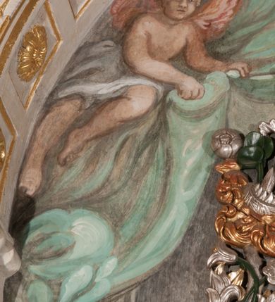 Zdjęcie nr 30: Obraz w formie stojącego prostokąta zamkniętego łukiem półkolistym. W centrum siedząca Matka Boska ukazana do kolan, frontalnie, lewym ramieniem obejmuje siedzące na jej kolanie Dzieciątko, w prawej ręce z przodu trzyma berło. Twarz ma owalną, o delikatnych rysach, dużych, migdałowatych oczach, długim, prostym nosie i niewielkich, pełnych ustach, okoloną długimi brązowymi włosami, opadającymi na ramiona. Ubrana jest w różową suknię, marszczoną przy dekolcie, z dekoracyjną lamówką oraz w obfity ciemnoniebieski płaszcz zarzucony na ramiona i opadający na kolana, ze złoconą lamówką i gwiazdą na prawym barku. Na głowie ma koronę otwartą, wokół nimb gwieździsty. Dzieciątko w pozycji siedzącej, zwrócone w trzech czwartych w prawo, w lewej ręce trzyma jabłko królewskie, prawą unosi w geście błogosławieństwa. Twarz ma kwadratową o pełnych policzkach, migdałowatych oczach, małym nosie i pełnych ustach, okoloną jasnymi, kręconymi włosami. Ubrane jest w fioletową tunikę oraz czerwony płaszcz przerzucony przez kolana. Na głowie ma koronę otwartą. Postacie ukazane na pomarańczowo-brązowym tle, koncentrycznie rozjaśnionym wokół głowy Marii, którą flankują dwa niewielkie anioły z rękami złożonymi w geście modlitwy. Obraz ujęty ornamentalną ramą utworzoną z wici roślinnej przeplatanej kwiatami, tworzącą nad łukiem szczyt z medalionem w wieńcu laurowym, ze skrzyżowanymi laskami marszałkowskimi w polu zwieńczonym koroną zamkniętą. W dolnej partii ramy płaskorzeźbione przedstawienie Chrystusa i Samarytanki przy studni z inicjałami „T(homas) O(linski) D(ecanus) W(ielicensis) P(lebanus) N(iepolomicensis) V(ir) I(llustris)”. 

