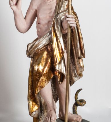 Zdjęcie nr 5: Pełnoplastyczna rzeźba przedstawia Chrystusa Zmartwychwstałego, stojącego w lekkim kontrapoście, z ciężarem ciała wspartym na lewej nodze, która depcze węża trzymającego w paszczy jabłko. Zbawiciel prawą nogę lekko ugina w kolanie opierając ją na ludzkiej czaszce. Chrystus w lewej ręce trzyma złotą laskę krzyżową z podwieszoną chorągwią, prawą zaś unosi w geście błogosławieństwa. Ma owalną twarz z prostym nosem, z uniesionymi ku górze brązowymi oczami i jasnoróżowymi ustami. Jego głowę okalają długie, brązowe włosy opadające na ramiona w lekkich lokach oraz krótka, brązowa broda. Zmartwychwstały ubrany jest w złocony płaszcz ze srebrną podszewką, odsłaniający prawe ramię, przerzucony z przodu przez lewą rękę i opadający miękkimi fałdami zakrywając prawy bok postaci. Karnacja ciała jest bladoróżowa. Na dłoniach, boku oraz stopach widoczne są czerwone rany po gwoździach i lancy. 