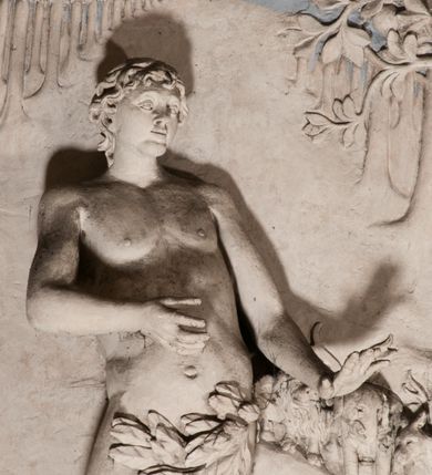 Zdjęcie nr 46: Pełnoplastyczna figura Chrystusa Ukrzyżowanego umieszczona jest na belce tęczowej. Chrystus został ukazany na krzyżu w dużym zwisie na wyprężonych ramionach, tworzących kształt litery „V”. Jego korpus jest wydłużony i esowato wygięty z silnym zaznaczeniem modelunku anatomicznego. Nogi zostały lekko zgięte w kolanach i nieznacznie odchylone w bok, zaś stopy skrzyżowane i przybite jednym gwoździem do krzyża. Wyeksponowano muskulaturę kończyn, żebra i ranę w boku. Głowa Zbawiciela opada na prawe ramię. Jego twarz jest podłużna, z długim, prostym nosem, o zamkniętych oczach i otwartych ustach w grymasie bólu. Otacza ją gęsta, kręcona broda oraz długie, ciemne włosy opadające lokami na oba ramiona. Na głowie widoczna jest cierniowa korona o długich kolcach. Biodra Zbawiciela zostały przepasane długim perizonium sięgającym kolan. Jest ono na środku drapowane za pomocą misowych fałd układających się poprzecznie, zaś po bokach zostało wywinięte za pomocą dwóch festonów opadających kaskadowo wzdłuż ud. Ponad głową Chrystusa umieszczony jest złocony titulus o kształtach barokowych w formie kartusza z napisem „INRI”.Rzeźba jest polichromowana, a perizonium srebrzone z zastosowaniem laserunków.