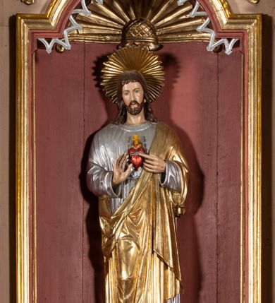 Zdjęcie nr 2: Nastawa architektoniczna, jednoosiowa, jednokondygnacyjna ze zwieńczeniem. Ołtarz drewniany, sarkofagowy, na cokole, z drewnianą mensą i kamiennym portatylem. Na froncie ołtarza namalowany owalny medalion ujęty wieńcem róż, z krzyżem, kotwicą i gorejącym sercem. Na ołtarzu tabernakulum w formie drewnianej skrzynki, ujętej parą kolumienek podtrzymujących imposty, z rocaille'owymi uszami. Drzwiczki w formie stojącego prostokąta zamkniętego łukiem półkolistym nadwieszonym. 
Nastawa ustawiona na cokole z wyłamanymi pod kątem czterema prostopadłościanami, dekorowanymi zwisami liściastymi. Retabulum ujęte dwiema parami kolumn, o trzonach dekorowanych rytą ornamentacją, z zewnętrzną parą ustawioną pod kątem, podtrzymującymi belkowanie, częściowo przerwane nad polem środkowym. Na belkowaniu fragmenty przerwanego, falistego przyczółka z siedzącymi puttami oraz para aniołków. W polu głównym wnęka w formie stojącego prostokąta zamkniętego łukiem odcinkowym nadwieszonym, ujęta profilowaną ramą, z figurą Najświętszego Serca Jezusa. Wnęka otoczona stylizowanymi ornamentami – akantem, rocaille'm i roślinnym, pomiędzy kolumnami roślinne zwisy, w partii fryzu rozety. Nastawa ujęta uszami utworzonymi ze stylizowanego ornamentu roślinnego. Zwieńczenie w formie zbliżonej do stojącego prostokąta, zamkniętego łukiem odcinkowym nadwieszonym, ujęte profilowaną ramą, przechodzącą po bokach w woluty,  dekorowane muszlą, ornamentem roślinnym i uskrzydlonymi główkami anielskimi. W polu wnęka w formie analogicznej do zwieńczenia, w profilowanej ramie, z obrazem wizji św. Małgorzaty Alacoque. Struktura polichromowana w kolorach bladoróżowym i pomarańczowym, kolumny, profile i ornamentyka złocone, detal srebrzony. 

