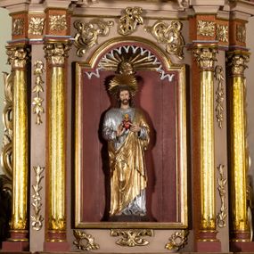 Zdjęcie nr 1: Nastawa architektoniczna, jednoosiowa, jednokondygnacyjna ze zwieńczeniem. Ołtarz drewniany, sarkofagowy, na cokole, z drewnianą mensą i kamiennym portatylem. Na froncie ołtarza namalowany owalny medalion ujęty wieńcem róż, z krzyżem, kotwicą i gorejącym sercem. Na ołtarzu tabernakulum w formie drewnianej skrzynki, ujętej parą kolumienek podtrzymujących imposty, z rocaille&#039;owymi uszami. Drzwiczki w formie stojącego prostokąta zamkniętego łukiem półkolistym nadwieszonym. 
Nastawa ustawiona na cokole z wyłamanymi pod kątem czterema prostopadłościanami, dekorowanymi zwisami liściastymi. Retabulum ujęte dwiema parami kolumn, o trzonach dekorowanych rytą ornamentacją, z zewnętrzną parą ustawioną pod kątem, podtrzymującymi belkowanie, częściowo przerwane nad polem środkowym. Na belkowaniu fragmenty przerwanego, falistego przyczółka z siedzącymi puttami oraz para aniołków. W polu głównym wnęka w formie stojącego prostokąta zamkniętego łukiem odcinkowym nadwieszonym, ujęta profilowaną ramą, z figurą Najświętszego Serca Jezusa. Wnęka otoczona stylizowanymi ornamentami – akantem, rocaille&#039;m i roślinnym, pomiędzy kolumnami roślinne zwisy, w partii fryzu rozety. Nastawa ujęta uszami utworzonymi ze stylizowanego ornamentu roślinnego. Zwieńczenie w formie zbliżonej do stojącego prostokąta, zamkniętego łukiem odcinkowym nadwieszonym, ujęte profilowaną ramą, przechodzącą po bokach w woluty,  dekorowane muszlą, ornamentem roślinnym i uskrzydlonymi główkami anielskimi. W polu wnęka w formie analogicznej do zwieńczenia, w profilowanej ramie, z obrazem wizji św. Małgorzaty Alacoque. Struktura polichromowana w kolorach bladoróżowym i pomarańczowym, kolumny, profile i ornamentyka złocone, detal srebrzony. 

