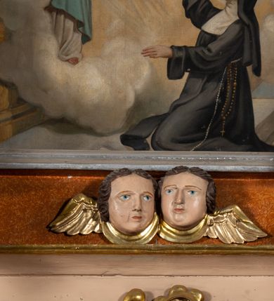 Zdjęcie nr 3: Obraz w formie stojącego prostokąta, zamkniętego łukiem odcinkowym nadwieszonym, o wklęsłych bokach. Święta Małgorzata ukazana w prawej, dolnej części obrazu, z profilu, w pozycji klęczącej, przed ołtarzem, z uniesioną głową i rozłożonymi na boki rękami. Ubrana jest w czarny habit, przepasany w talii, białą podwikę i czarny welon. Na ziemi leży otwarta księga. Przed nią, na tle ołtarza ukazany Chrystus unoszący się na tle obłoków. Zwrócony jest w trzech czwartych w lewo, z pochyloną głową, lewą ręką wskazuje na gorejące serce na jego piersi, prawą ma opuszczoną. Twarz ma szczupłą, okoloną jasną brodą i włosami. Ubrany jest w białą tunikę oraz jasnoniebieski płaszcz. Z jego ran na dłoniach i serca wydobywają się wiązki promieni skierowane w stronę świętej. Scena ukazana we wnętrzu z posadzką. W górnej części obrazu przedstawione obłoki i trzy uskrzydlone główki anielskie. 


