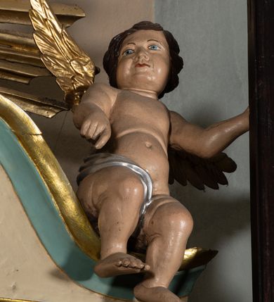 Zdjęcie nr 8: Nastawa architektoniczna, jednokondygnacyjna, jednoosiowa, ustawiona na cokole z wyodrębnionymi prostopadłościanami. Ołtarz drewniany, sarkofagowy, na cokole, z drewnianą mensą i kamiennym portatylem. Cokół nastawy dekorowany płycinami z akantem. Retabulum ujęte parą kolumn o skręconych trzonach i korynckich kapitelach, dźwigających pełne belkowanie, nad polem środkowym wyłamane na kształt łuku odcinkowego. Na belkowaniu fragmenty falistego, przerwanego przyczółka z siedzącymi puttami. Całe pole środkowe wypełnione wnęką w formie stojącego prostokąta zamkniętego łukiem półkolistym nadwieszonym, ujętą profilowaną ramą, z obrazem Matki Boskiej Wspomożenia Wiernych. Nastawa flankowana uszami utworzonymi z akantu i kratki regencyjnej. W miejscu zwieńczenia figura siedzącego na obłoku Chrystusa trzymającego krzyż, w glorii promienistej. Struktura polichromowana w kolorze beżowym, z jasnoniebieskimi i niebieskimi detalami, złoconymi kolumnami, profilami i ornamentyką oraz srebrzonymi detalami. 
