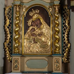 Zdjęcie nr 1: Nastawa architektoniczna, jednokondygnacyjna, jednoosiowa, ustawiona na cokole z wyodrębnionymi prostopadłościanami. Ołtarz drewniany, sarkofagowy, na cokole, z drewnianą mensą i kamiennym portatylem. Cokół nastawy dekorowany płycinami z akantem. Retabulum ujęte parą kolumn o skręconych trzonach i korynckich kapitelach, dźwigających pełne belkowanie, nad polem środkowym wyłamane na kształt łuku odcinkowego. Na belkowaniu fragmenty falistego, przerwanego przyczółka z siedzącymi puttami. Całe pole środkowe wypełnione wnęką w formie stojącego prostokąta zamkniętego łukiem półkolistym nadwieszonym, ujętą profilowaną ramą, z obrazem Matki Boskiej Wspomożenia Wiernych. Nastawa flankowana uszami utworzonymi z akantu i kratki regencyjnej. W miejscu zwieńczenia figura siedzącego na obłoku Chrystusa trzymającego krzyż, w glorii promienistej. Struktura polichromowana w kolorze beżowym, z jasnoniebieskimi i niebieskimi detalami, złoconymi kolumnami, profilami i ornamentyką oraz srebrzonymi detalami. 
