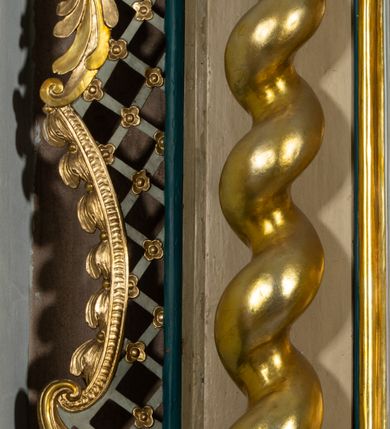 Zdjęcie nr 11: Nastawa architektoniczna, jednokondygnacyjna, jednoosiowa, ustawiona na cokole z wyodrębnionymi prostopadłościanami. Ołtarz drewniany, sarkofagowy, na cokole, z drewnianą mensą i kamiennym portatylem. Cokół nastawy dekorowany płycinami z akantem. Retabulum ujęte parą kolumn o skręconych trzonach i korynckich kapitelach, dźwigających pełne belkowanie, nad polem środkowym wyłamane na kształt łuku odcinkowego. Na belkowaniu fragmenty falistego, przerwanego przyczółka z siedzącymi puttami. Całe pole środkowe wypełnione wnęką w formie stojącego prostokąta zamkniętego łukiem półkolistym nadwieszonym, ujętą profilowaną ramą, z obrazem Matki Boskiej Wspomożenia Wiernych. Nastawa flankowana uszami utworzonymi z akantu i kratki regencyjnej. W miejscu zwieńczenia figura siedzącego na obłoku Chrystusa trzymającego krzyż, w glorii promienistej. Struktura polichromowana w kolorze beżowym, z jasnoniebieskimi i niebieskimi detalami, złoconymi kolumnami, profilami i ornamentyką oraz srebrzonymi detalami. 
