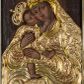 Zdjęcie nr 1: Obraz w formie stojącego prostokąta zamkniętego łukiem półkolistym nadwieszonym. Postacie przesłonięte są drewnianą sukienką w partiach szat, odsłaniającą twarze, dłonie i nogi. W centrum Matka Boska ukazana do kolan, zwrócona w trzech czwartych w prawo, obiema rękami obejmuje Dzieciątko, przytulając swoją twarz do jego policzka. Twarz ma trójkątną, o migdałowatych oczach, łukowato wygiętych brwiach, prostym, wąskim nosie i małych ustach. Ubrana jest w suknię i płaszcz nakrywający głowę i opadający na kolana, przesłonięte sukienką o płaskorzeźbionym roślinnym wzorze, z płaszczem o dekoracyjnej lamówce imitującej kameryzację. Dzieciątko ukazane z profilu, lewą nogą stoi na kolanach Matki, prawą unosi, przytula twarz do Marii i obejmuje ją prawą ręką. Twarz ma okrągłą, o dużych, skierowanych w górę oczach, małym, zadartym nosie i pełnych ustach, okoloną krótkimi, brązowymi włosami. Jego ciało przesłonięte jest drewnianą sukienką, w formie tuniki o płaskorzeźbionym, roślinnym wzorze, odsłaniającą nogi i rękę. Nad głowami obu postaci aplikowane metalowe korony zamknięte. Postacie ukazane na ciemnobrązowym tle, rozjaśnionym wokół postaci Marii. 



