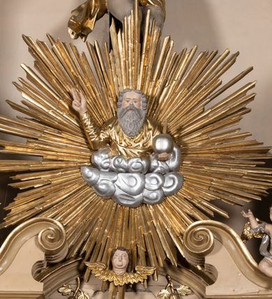 Zdjęcie nr 8: Nastawa architektoniczna, jednokondygnacyjna, jednoosiowa, ustawiona na cokole z wyodrębnionymi prostopadłościanami. Ołtarz drewniany, sarkofagowy, na cokole, z drewnianą mensą i kamiennym portatylem. Na ołtarzu ustawiony postument, ujęty spływami wolutowymi, dekorowany z przodu akantem i muszlą. Cokół nastawy dekorowany płycinami z uskrzydlonymi główkami anielskimi. Retabulum ujęte parą kolumn o skręconych trzonach i korynckich kapitelach, dźwigających niepełne belkowanie, częściowo przerwane nad polem środkowym, na którym gzyms wyłamany jest na kształt łuku odcinkowego. Na belkowaniu fragmenty falistego, przerwanego przyczółka z siedzącymi puttami. Całe pole środkowe wypełnione niszą w formie stojącego prostokąta zamkniętego łukiem półkolistym nadwieszonym, ujętą profilowaną ramą, z figurą św. Józefa z Dzieciątkiem. Nad niszą uskrzydlona główka anielska i dwie kiści winogron. Nastawa flankowana uszami utworzonymi z akantu i wstęgi regencyjnej. W miejscu zwieńczenia płaskorzeźbiona półpostać Boga Ojca pośród obłoków, w glorii promienistej. Struktura polichromowana w kolorze beżowym, z jasnoróżowymi detalami, srebrzonymi trzonami kolumn oraz złoconymi profilami i ornamentyką. 
