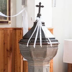 Zdjęcie nr 1: Chrzcielnica kamienna o formie kielichowej, składająca się z czary z pokrywą i trzonu na podstawie. Baza ośmioboczna, uskokowa. Na niej trzon zdobiony w dolnej części kółkami, a wyżej blendami przypominającymi maswerki, nad którymi gładki fryz. Czara ośmioboczna, zdobiona płycinami, ze wstęgą napisu poniżej krawędzi, nakryta ośmioboczną pokrywą zwieńczoną krzyżem. 