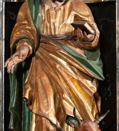 Zdjęcie nr 6: Ambona przyścienna, wisząca, ustawiona na północnym węgarze arkady tęczowej, dostępna przez schody od strony zakrystii. Kosz na planie sześcioboku z wysuniętą w stronę ołtarza częścią prowadzącą do drzwi. Ścianki wydzielone kolumnami o kapitelach korynckich, ustawionymi na postumentach, podtrzymującymi parapet z silnie wysuniętym gzymsem. Między kolumnami płytkie nisze zwieńczone konchami z figurami czterech ewangelistów i Chrystusa. Przyłucza, fryz i cokół dekorowany akantem. Kosz u spodu z podwieszoną szyszką. Wąski zaplecek ujęty pilastrami podtrzymującymi belkowanie. W polu obraz ze św. Janem Nepomucenem w profilowanej ramie w kształcie stojącego prostokąta zamkniętego łukiem nadwieszonym. Przyłucza i fryz dekorowany akantem i rozetami. Baldachim na planie sześcioboku, przedzielony belką arkady tęczowej. Podstawę tworzy belkowanie z wydatnym gzymsem, wyłamane w narożach. Kopuła dekorowana spływami akantowymi oraz girlandami, zwieńczona sześciobocznym cokołem, na którym sześć zwężających się kabłąków utworzonych z ażurowego akantu. Pod baldachimem sześcioboczny kaseton z podwieszoną gołębicą Ducha Świętego. Ambona marmoryzowana w odcieniu ciemnoszarym, ornamentyka i detale architektoniczne złocone, srebrzone i czerwone.