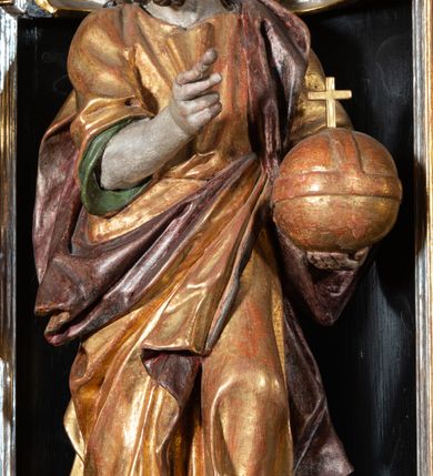 Zdjęcie nr 5: Ambona przyścienna, wisząca, ustawiona na północnym węgarze arkady tęczowej, dostępna przez schody od strony zakrystii. Kosz na planie sześcioboku z wysuniętą w stronę ołtarza częścią prowadzącą do drzwi. Ścianki wydzielone kolumnami o kapitelach korynckich, ustawionymi na postumentach, podtrzymującymi parapet z silnie wysuniętym gzymsem. Między kolumnami płytkie nisze zwieńczone konchami z figurami czterech ewangelistów i Chrystusa. Przyłucza, fryz i cokół dekorowany akantem. Kosz u spodu z podwieszoną szyszką. Wąski zaplecek ujęty pilastrami podtrzymującymi belkowanie. W polu obraz ze św. Janem Nepomucenem w profilowanej ramie w kształcie stojącego prostokąta zamkniętego łukiem nadwieszonym. Przyłucza i fryz dekorowany akantem i rozetami. Baldachim na planie sześcioboku, przedzielony belką arkady tęczowej. Podstawę tworzy belkowanie z wydatnym gzymsem, wyłamane w narożach. Kopuła dekorowana spływami akantowymi oraz girlandami, zwieńczona sześciobocznym cokołem, na którym sześć zwężających się kabłąków utworzonych z ażurowego akantu. Pod baldachimem sześcioboczny kaseton z podwieszoną gołębicą Ducha Świętego. Ambona marmoryzowana w odcieniu ciemnoszarym, ornamentyka i detale architektoniczne złocone, srebrzone i czerwone.