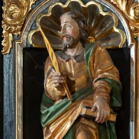 Zdjęcie nr 1: Rzeźba pełnoplastyczna, przedstawiająca św. Marka Ewangelistę. Święty ustawiony frontalnie, z głową zwróconą w prawo, z lewą nogą ugiętą w kolanie, księgą w lewej dłoni, którą wspiera o biodro oraz piórem w prawej dłoni.   Twarz pociągła z wysokim czołem, okolona zarostem, włosy średniej długości  z przedziałkiem na środku głowy. Ubrany jest w długą, złotą suknię z brązowym kołnierzem, przepasaną w talii i złoty płaszcz podbity na zielono, przewieszony przez lewe ramię i zawieszony na lewym boku. Przy prawej nodze lew, zwrócony w prawo. Polichromia naturalistyczna w partiach ciała, szaty złocone.