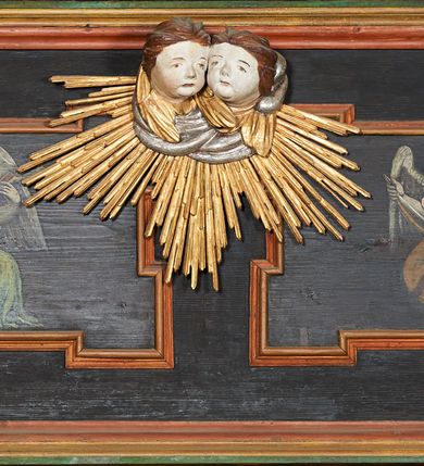 Zdjęcie nr 25: Prospekt organowy podwieszony przy północnej ścianie nawy, oparty na czterech filarach, dostępny z parapetu chóru. Balustrada drewniana z malowaną dekoracją; u spodu pas z ornamentem roślinnym; od frontu podzielona na trzynaście jednofiguralnych przedstawień w ramach, w formie wydłużonych, stojących prostokątów z przedstawieniami aniołów grających na instrumentach. Z boku na balustradzie dwie sceny w formie leżącego prostokąta ze św. Dawidem grającym na lirze i św. Cecylią grająca na organach, oddzielone pasem z dekoracją roślinną. 
Prospekt organowy architektoniczny, pięcioosiowy o bogatej dekoracji snycerskiej. Organy umieszczone na podstawie w kształcie leżącego prostokąta, dekorowanej dwiema płycinami z uszakami w narożach, z malowanymi przedstawieniami grających na instrumentach aniołów oraz z rzeźbionymi uskrzydlonymi główkami anielskimi w glorii pośrodku. Pod cokołem podwieszona dekoracja malarsko-rzeźbiarska nałożona na balustradę chóru. W centrum kompozycji malarskie przedstawienie trzech aniołów (jeden czyta księgę, a dwaj grają na instrumentach) w wieńcu laurowym. Poniżej, rzeźbiona uskrzydlona główka anielska, a całość ujęta ornamentem małżowinowo-chrząstkowym i zakończona u dołu szyszką. Prostokątna podstawa wspiera niski cokół, na którym ustawiona jest trójwieżyczkowa część główna. Środkowa, wyższa wieżyczka jest o przekroju półkolistym, a boczne kątowe o przekroju trójkątnym. Wieżyczki rozdzielają niższe prostokątne płyciny wypełnione piszczałkami. Pod wieżyczkami bocznymi podwieszone są złocone szyszki. Ażurowa dekoracja rzeźbiarska małżowino-chrząstkowa zdobi uszy organu, jest również umieszczona nad płycinami rozdzielającymi wieżyczki. Zwieńczenie tworzą na osiach bocznych strome szczyty, a pośrodku dwugłowy orzeł, na piersi którego w kartuszu w kształcie serca widnieją sygle „A[LBERTUS] B[INKOWICZ] / P[LEBANUS] O[RAVIENSIS]”. Piszczałki przysłaniają od góry ażurowe, rzeźbione firanki o motywie małżowinowo-chrząstkowym, a u dołu wąski pas dekoracji ornamentalnej z motywem silnie przestylizowanych lilii. Organy polichromowane na czarno, profilowania w kolorze czerwonym, zielonym i pomarańczowym, ornamentyka złocona i srebrzona. 



