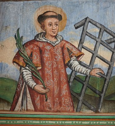 Zdjęcie nr 28: Prospekt organowy podwieszony przy północnej ścianie nawy, oparty na czterech filarach, dostępny z parapetu chóru. Balustrada drewniana z malowaną dekoracją; u spodu pas z ornamentem roślinnym; od frontu podzielona na trzynaście jednofiguralnych przedstawień w ramach, w formie wydłużonych, stojących prostokątów z przedstawieniami aniołów grających na instrumentach. Z boku na balustradzie dwie sceny w formie leżącego prostokąta ze św. Dawidem grającym na lirze i św. Cecylią grająca na organach, oddzielone pasem z dekoracją roślinną. 
Prospekt organowy architektoniczny, pięcioosiowy o bogatej dekoracji snycerskiej. Organy umieszczone na podstawie w kształcie leżącego prostokąta, dekorowanej dwiema płycinami z uszakami w narożach, z malowanymi przedstawieniami grających na instrumentach aniołów oraz z rzeźbionymi uskrzydlonymi główkami anielskimi w glorii pośrodku. Pod cokołem podwieszona dekoracja malarsko-rzeźbiarska nałożona na balustradę chóru. W centrum kompozycji malarskie przedstawienie trzech aniołów (jeden czyta księgę, a dwaj grają na instrumentach) w wieńcu laurowym. Poniżej, rzeźbiona uskrzydlona główka anielska, a całość ujęta ornamentem małżowinowo-chrząstkowym i zakończona u dołu szyszką. Prostokątna podstawa wspiera niski cokół, na którym ustawiona jest trójwieżyczkowa część główna. Środkowa, wyższa wieżyczka jest o przekroju półkolistym, a boczne kątowe o przekroju trójkątnym. Wieżyczki rozdzielają niższe prostokątne płyciny wypełnione piszczałkami. Pod wieżyczkami bocznymi podwieszone są złocone szyszki. Ażurowa dekoracja rzeźbiarska małżowino-chrząstkowa zdobi uszy organu, jest również umieszczona nad płycinami rozdzielającymi wieżyczki. Zwieńczenie tworzą na osiach bocznych strome szczyty, a pośrodku dwugłowy orzeł, na piersi którego w kartuszu w kształcie serca widnieją sygle „A[LBERTUS] B[INKOWICZ] / P[LEBANUS] O[RAVIENSIS]”. Piszczałki przysłaniają od góry ażurowe, rzeźbione firanki o motywie małżowinowo-chrząstkowym, a u dołu wąski pas dekoracji ornamentalnej z motywem silnie przestylizowanych lilii. Organy polichromowane na czarno, profilowania w kolorze czerwonym, zielonym i pomarańczowym, ornamentyka złocona i srebrzona. 



