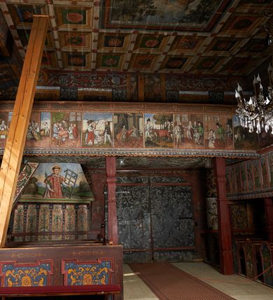 Zdjęcie nr 4: Prospekt organowy podwieszony przy północnej ścianie nawy, oparty na czterech filarach, dostępny z parapetu chóru. Balustrada drewniana z malowaną dekoracją; u spodu pas z ornamentem roślinnym; od frontu podzielona na trzynaście jednofiguralnych przedstawień w ramach, w formie wydłużonych, stojących prostokątów z przedstawieniami aniołów grających na instrumentach. Z boku na balustradzie dwie sceny w formie leżącego prostokąta ze św. Dawidem grającym na lirze i św. Cecylią grająca na organach, oddzielone pasem z dekoracją roślinną. 
Prospekt organowy architektoniczny, pięcioosiowy o bogatej dekoracji snycerskiej. Organy umieszczone na podstawie w kształcie leżącego prostokąta, dekorowanej dwiema płycinami z uszakami w narożach, z malowanymi przedstawieniami grających na instrumentach aniołów oraz z rzeźbionymi uskrzydlonymi główkami anielskimi w glorii pośrodku. Pod cokołem podwieszona dekoracja malarsko-rzeźbiarska nałożona na balustradę chóru. W centrum kompozycji malarskie przedstawienie trzech aniołów (jeden czyta księgę, a dwaj grają na instrumentach) w wieńcu laurowym. Poniżej, rzeźbiona uskrzydlona główka anielska, a całość ujęta ornamentem małżowinowo-chrząstkowym i zakończona u dołu szyszką. Prostokątna podstawa wspiera niski cokół, na którym ustawiona jest trójwieżyczkowa część główna. Środkowa, wyższa wieżyczka jest o przekroju półkolistym, a boczne kątowe o przekroju trójkątnym. Wieżyczki rozdzielają niższe prostokątne płyciny wypełnione piszczałkami. Pod wieżyczkami bocznymi podwieszone są złocone szyszki. Ażurowa dekoracja rzeźbiarska małżowino-chrząstkowa zdobi uszy organu, jest również umieszczona nad płycinami rozdzielającymi wieżyczki. Zwieńczenie tworzą na osiach bocznych strome szczyty, a pośrodku dwugłowy orzeł, na piersi którego w kartuszu w kształcie serca widnieją sygle „A[LBERTUS] B[INKOWICZ] / P[LEBANUS] O[RAVIENSIS]”. Piszczałki przysłaniają od góry ażurowe, rzeźbione firanki o motywie małżowinowo-chrząstkowym, a u dołu wąski pas dekoracji ornamentalnej z motywem silnie przestylizowanych lilii. Organy polichromowane na czarno, profilowania w kolorze czerwonym, zielonym i pomarańczowym, ornamentyka złocona i srebrzona. 



