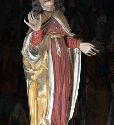 Zdjęcie nr 5: Rzeźba pełna, Chrystus przybity do krzyża trzema gwoździami w lekkim zwisie z głową silnie skręconą w prawo. Twarz podłużna z otwartymi ustami i półprzymkniętymi oczami, okolona kędzierzawą, ciemną brodą; włosy długie spływające na plecy i prawe ramię. Nogi delikatnie ugięte w kolanach; stopy przebite jednym gwoździem, w układzie prawa na lewą. Na głowie Chrystus ma założoną zieloną koronę cierniową. Perizonium w formie tkaniny przewiązanej diagonalnie przez biodra, ze zwisem na prawym boku. Sylwetka wychudzona, smukła, o delikatnym skręcie bioder, z wyraźnie zaznaczonym użyleniem i czerwono-sinymi śladami męki. Polichromia naturalistyczna w partiach ciała, o bladej kolorystyce bieli i błękitu oraz intensywnej czerwonej krwi; perizonium złocone. Nad głową Chrystusa zawieszony zielono-czarny titulus w formie kartusza z napisem „INRI”, ozdobiony motywem małżowinowo-chrząstkowym. Krzyż drewniany, prosty, malowany na czarno. U dołu krzyża zawieszone cztery wota w kształcie złotych serduszek przypiętych czerwonymi kokardkami.